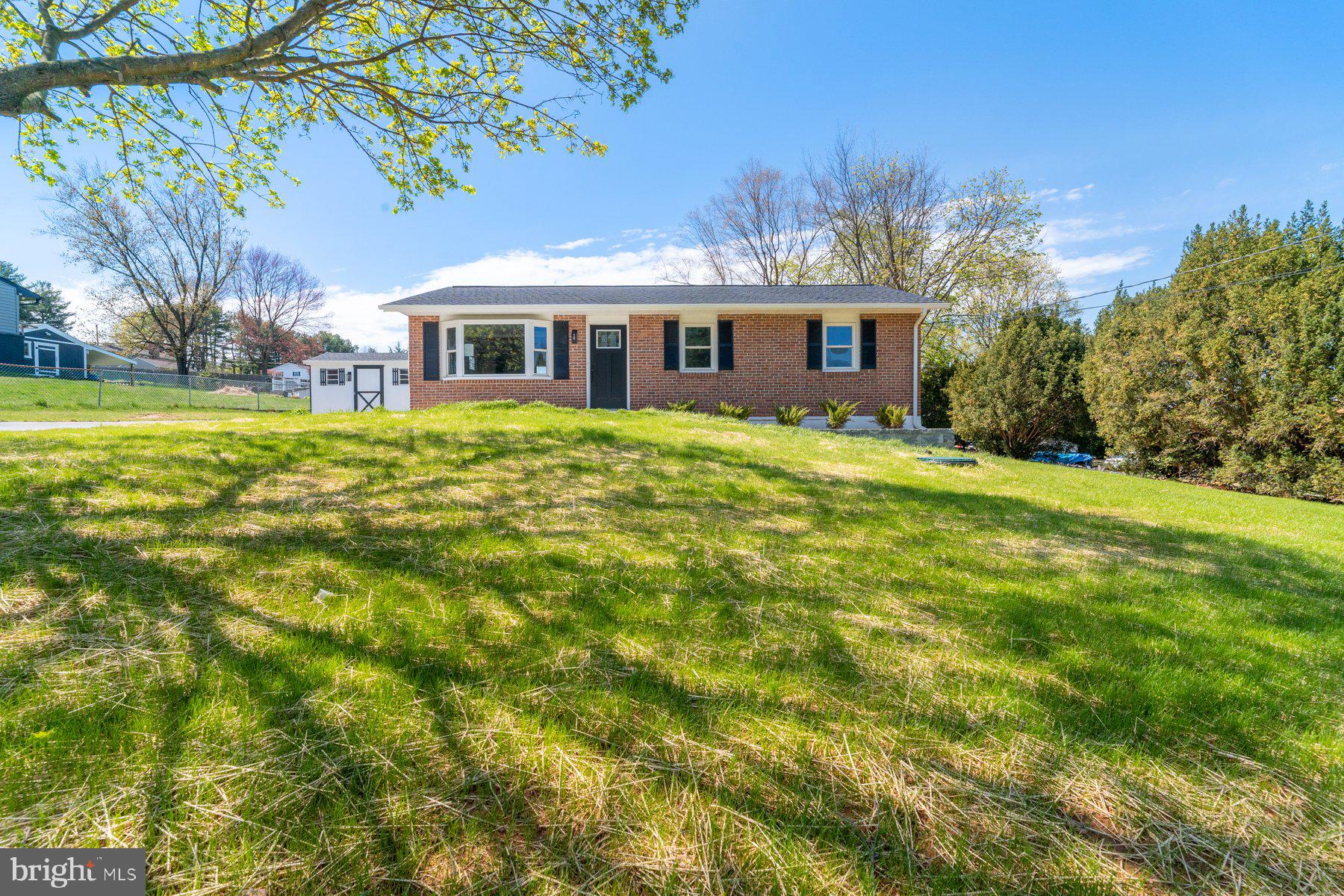 Beautifully remodeled 4BR/2BA Rancher located on a spacious lot in a quiet neighborhood. Parking is ample in the extra long and wide driveway that leads to the newly poured concrete walkway and front patio, and the door into your forever home.  Step inside to an open floor plan with tons of natural light, recessed lighting and stunning wood grain flooring on both the first and second floor, and wood accents throughout.  The spacious living room offers a feature wall with a wood mantel and an electric fireplace feature.  The dining room is sizable with a feature wall and is open to the beautiful kitchen.  The kitchen boasts plenty of cabinets to the ceiling finished with crown moldings, stainless steel appliances, sleek quartz countertops with a complimenting tile backsplash, and a stainless sink under a window.  Down the hall are two sizable secondary bedrooms, a larger primary bedroom, and a newly remodeled and beautifully tiled full bath.  The lower level is finished featuring the fourth bedroom, a large family room with a built-in dry bar, a full bath featuring a bench inside the beautifully tiled walk-in shower, open shelving, laundry with a table for folding, storage cabinets, unfinished storage space, and a walk-out to the oversized yard through Bilco door.  From the kitchen step outside to an amazing yard boasting plenty of green space, a shed, and so many possibilities.  This home is move-in ready with so much to offer new homeowners, and is located in close proximity to shopping, restaurants, and commuter routes.