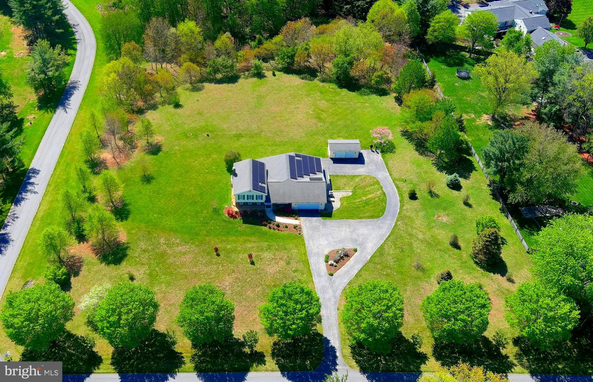 A spacious, bright house ideally situated on a beautiful 3-acre lot on a quiet, tree lined, cul-de-sac road. This 3-level house was redesigned and expanded in 2006 with permits to offer accessibility, exceptional flexibility, space, and privacy. All living situations are easily accommodated including multigenerational families, work-at-home offices, long-term visits,
and supplemental rental income. The house is accessible with no step entrances, wide halls and
doorways and accessible bathrooms. There is a purpose built, 700 sq ft. apartment with sweeping views of the back yard on the lower level. The above ground apartment has a private, porch covered entrance and parking. Sleeping, work, and play space can be allocated to meet a family’s needs with 3 en-suite rooms (one on each level) and 3 additional rooms with closets that may serve either as bedrooms, offices, craft rooms, or whatever is needed. There are 4 full baths, 2 half baths, and 2 laundry areas. Enter the main level through a welcoming foyer which leads to a large, bright kitchen where everyone gathers. French doors lead to a peaceful 3 season room and deck. All of this has views of the beautiful backyard, trees, and sky beyond. A formal dining room flows from the kitchen into the living room. Pocket doors allow the
dining room and living room to be open to the rest of the house or closed off for privacy and
solitude. Behind the kitchen, a hall with 2 pantry closets leads to a large, en-suite room with
more great views and a wall of closets. Just off this hall is a mud room with laundry hook ups
and access to the oversized garage. Just off the foyer and 2 steps down is a level with a family
room with a fireplace and sliders to the deck. This level also has a convenient half bath, and one
of the rooms with a closet that the current owner uses as a work-at-home office. The upper level has yet another en-suite bedroom with a walk-in closet, two more secondary rooms, a full family bathroom, and tons of linen closets. The lower level includes a rec room that leads to the apartment, a half bath, laundry room, and a storage room. The apartment is a light filled, private space with a generous living and dining room, a full kitchen, and a large en-suite bedroom with a wall of closets. The apartment has its own HVAC system. The entire lower level can be designated for the apartment so that it has its own office/den, one and a half bathrooms, and laundry room. Outside is spectacular with trees ringing the backyard. There is
a custom-built storage shed/shop with electricity and dual garage doors to accommodate your outdoor toys, tools, and lawn equipment. The attached oversized, two car garage is served by an expansive circular driveway that can accommodate a lot of cars. The house is energy efficient with a 16.225 kw solar panel system (owner owned) installed in 2017, dual paned windows, and R-60 insulation in the attics. Additional upgrades include 400-amp electrical service, dual HVAC for the main house, a propane generator for peace of mind, a 1,000 gal buried propane tank (owner owned), and a large heat pump hot water heater. There are three Cat 5, ethernet connections in the house. Both kitchens have gas cooktops. All of this is
conveniently located just minutes from shopping, dining, health care, library, senior center, parks, hiking trails, and major commuter routes in the historic town of Mount Airy. This area offers great schools and the perfect blend of rural tranquility and everyday convenience. This is a rare opportunity to own a beautiful home in a peaceful setting, that is versatile to adapt to your lifestyle. Please note that while the home has 6 flexible rooms with closets that can serve a variety of purposes, the septic is rated for four bedrooms.