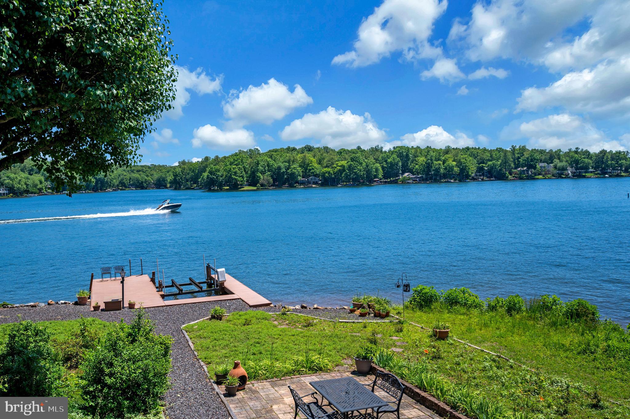 Welcome to 102 Flat Run, a stunning waterfront home that offers captivating 180-degree lake views, including both sunrises and sunsets. Perfectly positioned to maximize privacy from the road and scenic views toward the lake, this residence delivers an exceptional blend of comfort and low-maintenance lakeside living.
Gleaming hardwood floors run throughout all living areas (excluding bathrooms), adding warmth and elegance.
The first level features an inviting living room/office with a grand fireplace. A few steps then lead you to the expansive family room and dining area, highlighted by a dramatic wall of windows and doors that flood the space with natural light and showcase the breathtaking views. The well-appointed kitchen includes an island and a bright breakfast room, ideal for casual meals while enjoying the water. 
Step outside to the stunning composite deck overlooking the lake — the perfect spot for morning coffee or evening entertaining.
The massive primary bedroom suite is a true retreat, complete with a luxurious bath featuring a soaking tub, separate shower, and two large walk-in closets. A second bedroom, full bath, and a half bath with laundry area complete the main level. 
The fully finished lower level offers outstanding versatility and space for guests or relaxation. It includes a spacious rec room, two additional bedrooms, a flex room with its own exterior door (ideal for a home office, gym, or guest suite), and another full bath. A huge screened porch runs the entire length of the house, providing even more outdoor living space protected from the elements. Direct access to the three-car garage is conveniently located on this level.
Outside, the home boasts a maintenance-free yard with no grass to mow. Enjoy the stunning, colorful landscape, composite decking on the dock, a generous paver patio, and an electric boat lift — everything you need for effortless lakeside enjoyment.
This exceptional waterfront property offers move-in-ready space with panoramic views, abundant natural light, and a lifestyle of relaxation and recreation. Don’t miss the opportunity to make this your new lake home.
Located in a private, gated, secure community, Lake of the Woods offers anything and everything you could want. Home to two lakes (the 550-acre main lake and a 35-acre "fishing lake"), a golf course, an equestrian center, a fire and rescue department, and a church all within the gates, Lake of the Woods simply has it all. Whether your passion is boating, water skiing, kayaking, golfing, horseback riding, or simply taking in the breathtaking views from the clubhouse while enjoying a fabulous meal, from your deck or yard, or from one of the beaches, you won't be disappointed! Perhaps you'd like a game of bridge or volunteer your time and talents...Lake of the Woods offers more than 60 clubs and organizations. Located in a private, gated, secure community, Lake of the Woods offers anything and everything you could want. Home to two lakes (the 550-acre main lake and a 35-acre "fishing lake"), a golf course, an equestrian center, a fire and rescue department, and a church all within the gates, Lake of the Woods has it all. Whether your passion is boating, water skiing, kayaking, golfing, horseback riding, or simply taking in the breathtaking views from the clubhouse while enjoying a fabulous meal, from your deck or yard, or from one of the beaches, you won't be disappointed! Perhaps you'd like a game of bridge or volunteer your time and talents...Lake of the Woods offers more than 60 clubs and organizations from which you may choose to become involved. Located in Orange County, we are fortunate to enjoy low real estate taxes. Coupled with home prices ranging from $300,000+ to over $2,000,000, Lake of the Woods is the perfect community for full-time residents and weekenders. But don't take my word for it, please come see for yourself!