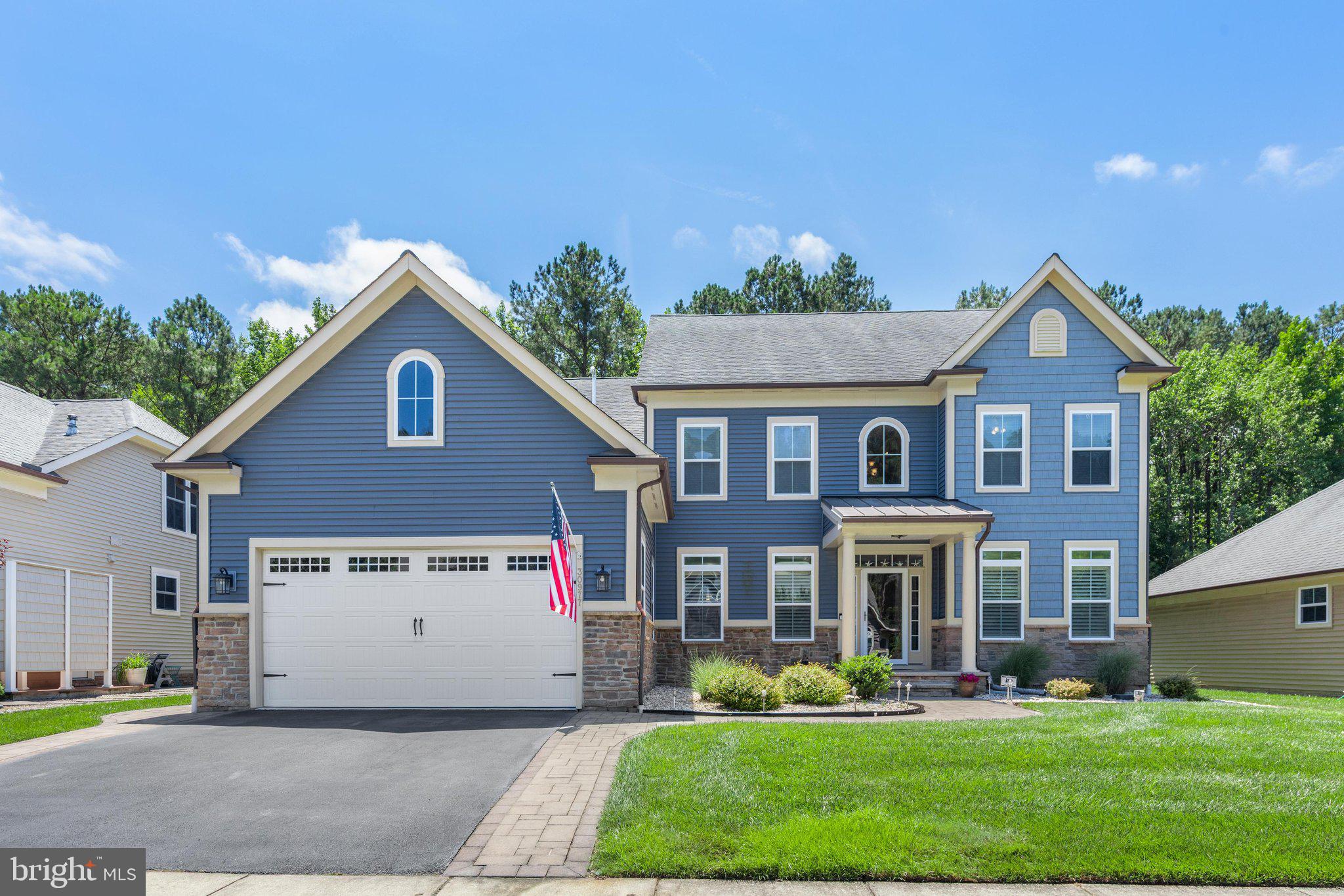 Located on a private wooded homesite in Bay Forest, this spacious 4-bedroom + Bonus Room, 3.5-bath home offers approx. 3,800 square feet of living space along with exceptional outdoor living areas designed to enjoy the coastal lifestyle.

The curb appeal begins with a covered stone front porch, custom stone walkways, and extensive hardscaping that wraps around the home. Out back, you'll find a true outdoor retreat featuring a large deck, an expansive screened porch with sun shades, and a beautiful stone patio with sitting wall—all overlooking a peaceful wooded backdrop that provides both privacy and a natural setting rarely found in resort communities.

Inside, a dramatic two-story foyer welcomes guests through a stunning stained-glass front door accented with sidelights and transom windows. Hardwood flooring, plantation shutters, crown molding, decorative trim, and wrought-iron stair railings add character throughout the home. The formal living room features a bay window, while the spacious dining room provides plenty of room for gatherings and holiday entertaining.

The family room showcases a vaulted ceiling and gas fireplace with upgraded tile surround and flows into the large kitchen featuring granite countertops, tiled backsplash, stainless steel appliances, luxury vinyl plank flooring, and an oversized dining area.

The first-floor owner's suite offers a tray ceiling, large walk-in closet, and private bath with soaking tub and frameless glass shower. Also on the first floor are a laundry room with cabinetry and a powder room. Upstairs, a second owner's suite, two additional bedrooms, full bath, and an oversized bonus recreation room provide ample space for family and guests.

Additional features include first floor laundry room with cabinets and utility sink,  a tankless water heater, lawn irrigation (with its own well and a new controller), ceiling fans throughout, a two-car garage with upgraded flooring, shelving, and workbench area, and a recently updated HVAC system  and new sump pump for added peace of mind.

Residents of Bay Forest enjoy resort-style amenities including a lazy river and water slides, 2 resort-style pools, clubhouse, fitness center, tennis and pickleball courts (indoor courts, too), walking trails, playgrounds, kayak launch and kayak storage, herb garden, game room with skeeball, foosball, ping pong, shuffleboard, bocce, indoor basketball, and a seasonal beach shuttle to Bethany Beach.  Located just minutes from Bethany Beach, this property offers the perfect balance of resort-style living and coastal convenience. Spend your days enjoying the community's outstanding amenities or take a short trip to the beach, boardwalk, and local dining before returning home to your private backyard retreat surrounded by woods.