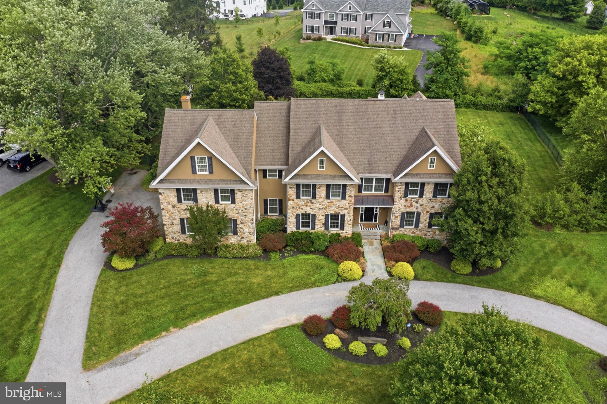 Welcome to 408 Mattrissa Ridge, an exceptional luxury estate nestled in the prestigious community of Darlington Pointe and within the award-winning Rose Tree Media School District. Meticulously curated and beautifully maintained, this remarkable residence offers an unparalleled blend of timeless elegance, sophisticated design, and resort-inspired living. A grand and inviting floor plan unfolds with gleaming hardwood flooring, extensive custom millwork, and professionally curated spaces ideal for both intimate gatherings and large-scale entertaining. At the heart of the home, the gourmet chef’s kitchen is a masterpiece, featuring commercial-grade appliances, floor-to-ceiling custom cabinetry, a butler’s pantry, and an adjoining breakfast room overlooking the grounds. The kitchen flows seamlessly into the stunning family room, where a coffered ceiling and dramatic floor-to-ceiling stone fireplace create a warm yet refined atmosphere. A formal dining space provides the perfect backdrop for elegant entertaining, while a private first-floor guest suite with ensuite bath, walk-in closet, and custom built-ins offers exceptional flexibility for extended family, guests, or an au pair. A richly appointed office with custom built-ins, mudroom with custom cubbies, laundry room, and stunning powder room complete the main level. The upper level is anchored by a luxurious owner’s retreat featuring an expansive custom walk-in closet and a spa-inspired bath with dual vanities, soaking tub, dedicated vanity area, and oversized shower. Four additional spacious bedrooms and three beautifully updated bathrooms provide comfort and privacy for family and guests alike. The fully finished lower level rivals the finest private clubs, offering a dedicated fitness area with sauna, theater space, custom bar, and full bath—creating an extraordinary destination for recreation, wellness, and entertaining. Beyond the interior, an extraordinary backyard oasis awaits. Designed for effortless indoor-outdoor living, the grounds showcase an expansive travertine terrace, a spectacular zero-entry pool with cascading spa, outdoor kitchen and grilling station, stacked stone fireplace, and an impressive pool house complete with its own kitchen and bath. Whether hosting a summer gathering or enjoying a quiet evening at home, the outdoor spaces offer a true resort-style experience. Expansive lawn areas provide abundant space for recreation, gardening, and play while maintaining a sense of privacy and tranquility. Ideally located just moments from the charm of Media Borough’s acclaimed restaurants, boutiques, farmers markets, community events, and popular Dining Under the Stars, 408 Mattrissa Ridge presents a rare opportunity to enjoy luxury living at its finest in one of Delaware County’s most sought-after locations.
