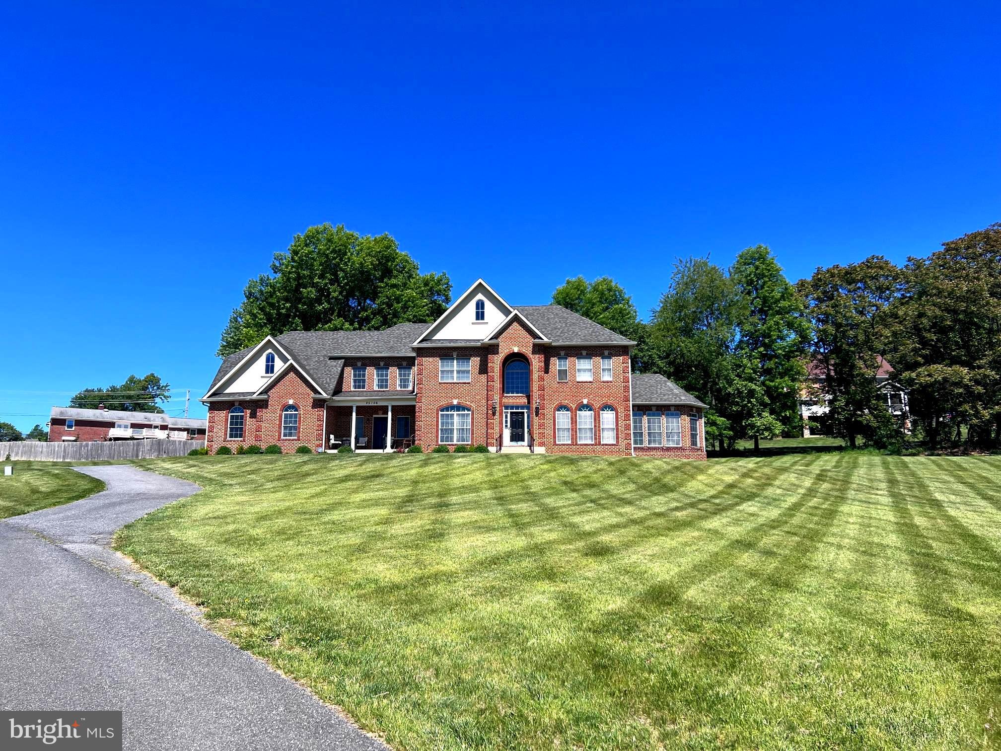 Welcome to this exceptional Colonial home in the highly sought-after County View Community of Laytonsville,  offering 1.36 acres and over 8,000 sq. ft., where timeless elegance meets modern comfort. From the moment you step into the dramatic two-story foyer, you'll be captivated by the home's open, light-filled design, gleaming hardwood floors, and thoughtfully crafted living spaces. Perfect for both everyday living and entertaining, the formal living and dining rooms showcase exquisite architectural details, including crown molding, chair rail, box wainscoting, and a decorative ceiling medallion that create an elegant setting for memorable gatherings. The breathtaking two-story family room is the heart of the home, featuring a striking gas fireplace with a sophisticated black surround, a grand Palladian window, and expansive windows that fill the space with natural light while framing beautiful outdoor views. The gourmet kitchen is a chef's dream, complete with an oversized center island and breakfast bar, granite countertops, stainless steel appliances, dual wall ovens, 42-inch cabinetry, a butler's pantry, planning station, and a spacious casual dining area. Just beyond, the sun-filled breakfast room opens to the patio, making it the perfect spot to enjoy your morning coffee or dine al fresco.  An elegant sunroom with a tray ceiling offers a peaceful retreat for reading, relaxing, or simply taking in the surrounding views.  A private home office with French doors and crown molding provides an ideal workspace for today's lifestyle. Two powder rooms and a convenient main-level laundry room complete this beautifully designed floor.  Upstairs, the luxurious owner's suite is a true sanctuary, featuring a tray ceiling with recessed lighting, a spacious sitting room, and a spa-inspired bath with cathedral ceilings, dual granite vanities, a jetted soaking tub, a glass-enclosed shower, and an oversized walk-in closet. Three additional generously sized bedrooms, including one with a private en-suite bath and two connected by a Jack-and-Jill bath, provide comfort and privacy for family and guests. The finished lower level is designed for entertaining and relaxation, offering a spacious recreation room, an impressive full bar with Black Galaxy granite countertops and a wet bar, a dedicated media room wired for a projector, an additional bedroom with walk-out access, a full bath, and abundant storage. Completing this remarkable home is an oversized three-car side-entry garage with convenient main-level access. Combining sophisticated design, exceptional space, and an unbeatable location, this stunning residence offers everything you've been searching for. Don't miss the opportunity to make this extraordinary home your own. Seeing is believing.