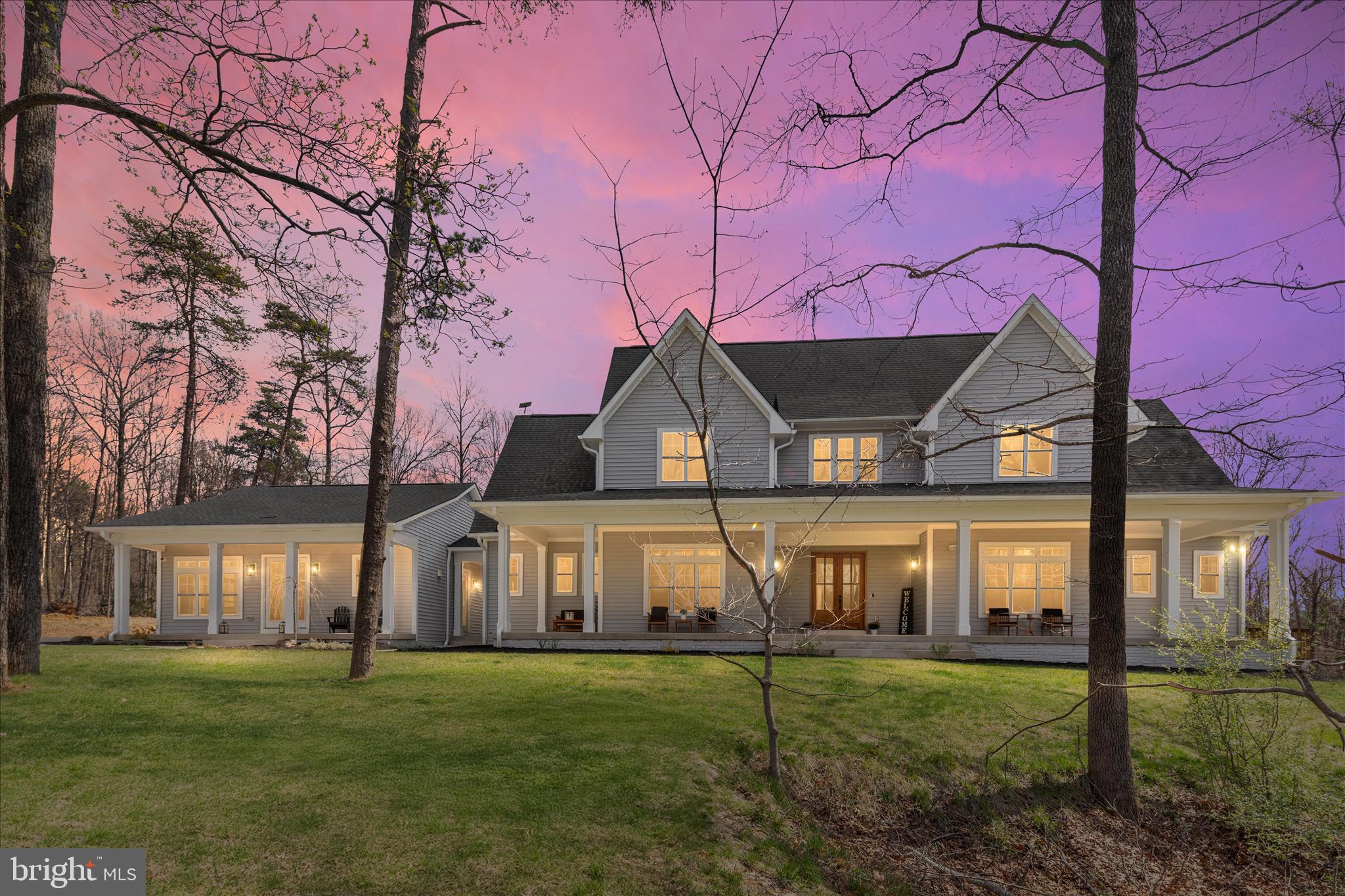 Welcome to this stunning custom-built Farmhouse with attached carriage house and pond, situated on a private lot of 12.25 acres with trees and mountain views. This is a one-of-a-kind opportunity to own this estate style property minutes from downtown Warrenton. This home was thoughtfully designed for modern day living. It features 5 bedrooms, 4.5 bathrooms, a 4-car garage, and an unfinished basement with walk-up access to the beautiful backyard. Enjoy sitting on the front porches or relax on the covered rear patio with family and friends to take in beautiful sunsets. Built just three years ago and showing like a model home, this meticulously landscaped property offers impressive curb appeal and over 4,952 finished square feet of impeccably maintained living space. Step inside the foyer and you will be impressed by the open concept floor plan and gorgeous hardwood floors. The main level features the great room with a cozy gas fireplace and custom built-ins, a formal dining room with beautiful mountain views, a gourmet kitchen, spacious office, owner’s suite, laundry room, and powder room. The gourmet kitchen is a true showpiece. It features stainless steel appliances, a gas oven/range, pot filler, built-in microwave, wall oven, quartz countertops, custom white cabinetry, and an impressive tile backsplash. A large center island with bar seating makes it ideal for everyday living and entertaining. Behind the kitchen, you will find a beverage bar with custom cabinetry and quartz countertops, as well as a walk-in pantry. Retreat to the luxurious owner’s suite, which features access to the rear covered patio and walk-in closets with customized built-ins. The spa-like bathroom showcases stunning cabinetry with dual vanities, an oversize soaking tub, and a spacious frameless glass shower with bench seating. Upstairs, the Princess Suite offers its own private en suite bath with custom tile, perfect for guests. Bedrooms three and four are generously sized with spacious closets and great views of the property. The hallway bathroom features an upgraded tile package with dual vanities. As a bonus, the upper level includes a huge loft/recreation room with rough-in plumbing for a wet bar. A spacious main level laundry room with custom cabinetry is conveniently located in the main house, with access through the attached breezeway to the carriage house.  The carriage house was thoughtfully designed for multi-generational living, featuring a large living room, spacious bedroom, and luxurious bathroom. It also includes rough-in plumbing for a future kitchen, offering incredible flexibility for extended family or guests. The lower level is unfinished and ready for you to customize to suit your needs. It includes rough-in plumbing for an additional bathroom and walk-up access to the backyard. With over 12 acres of land, this property is the perfect retreat from the city. Explore the trails, ride ATVs, and fish at the pond. A storage shed with garage door provides convenient storage for ATVs and equipment to maintain this one-of-a-kind property. This is a rare opportunity to own a truly exceptional custom-built Farmhouse on over 12 private acres. Schedule your private showing today. You do not want to miss the chance to make this your forever home!