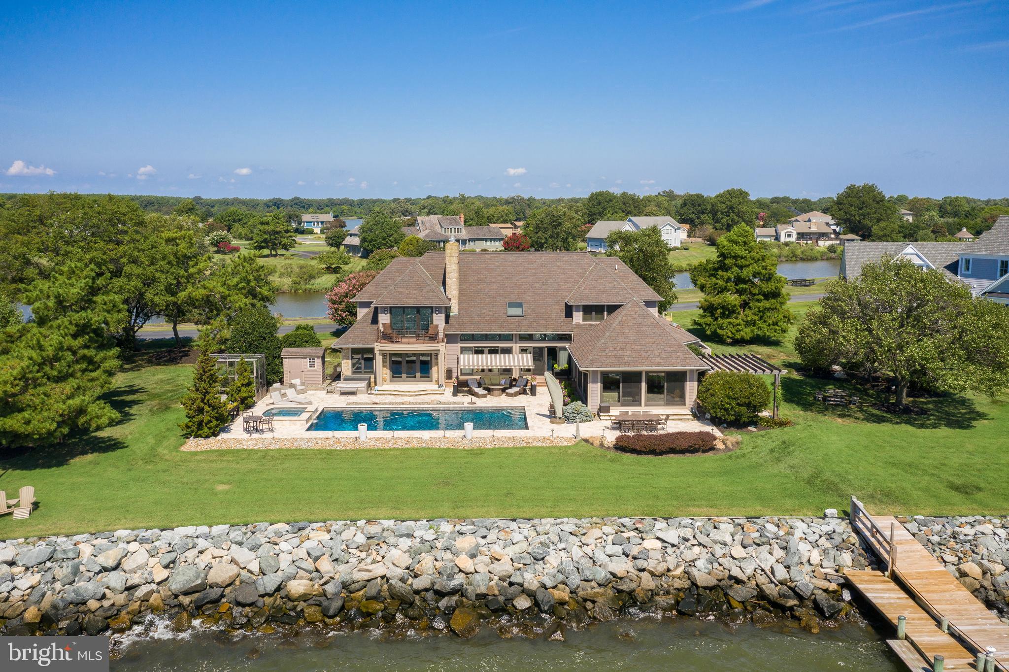 A timeless home, tucked away on Eastern Bay with 250 ft of waterfront! Shielded, with lush foliage & trees this stunning 4500 sq. foot residence breathes luxury & is built for entertaining!
 The Living room, sunroom is expansive with wonderful views of Eastern Bay, saltwater pool, and spa with a cooling bay breeze. Chefs and entertainers will delight in the kitchen, Viking, Wolf, Thermador & Dacor appliances, custom Teak cabinets with family dining, overlooking the pool and waterfront. Second kitchen in the sunroom is ready for any party. Four bedrooms three full and three half baths accommodate family and guests. The master suite is especially magical with high coffer ceilings, custom cabinetry, stack stone fireplace & balcony offering wide open water views. Primary bath offers a steam shower, jacuzzi tub, walk-in closets and 2 granite vanities. Executive office on first floor, with water views, stack stone fireplace & built-in office cabinets, is ideal work area.  The first floor features an additional large guest suite with a private entry. Endless up-grades and thoughtful finishes include an elevator, wine room with teak cabinets racks, wine refrigerators & draws. Remodeled in 2009 from the ground up with luxury influence, soaring vaulted ceiling and so much more.
 The outside revels many entertaining spaces wrapped around the home.  Travertine tumble stone surrounds the pool & spa, many outdoor living spaces including, a outdoor kitchen with pergola with canvas top so you can enjoy the breathtaking water views & wildlife. A pier with two boat lifts, two jet ski lifts with lower extension to launch kayaks or  for crabbing & fishing all day long.  This completes your immediate access to the waterfront lifestyle.
 The neighborhood, amenities include golf, beach, marina, tennis and much more. Located 6 to 10 minutes from dining, shopping, and blue-ribbon schools. This home is a complete luxury experience with invaluable privacy. A timeless home for a discerning buyer, and not an opportunity to miss.