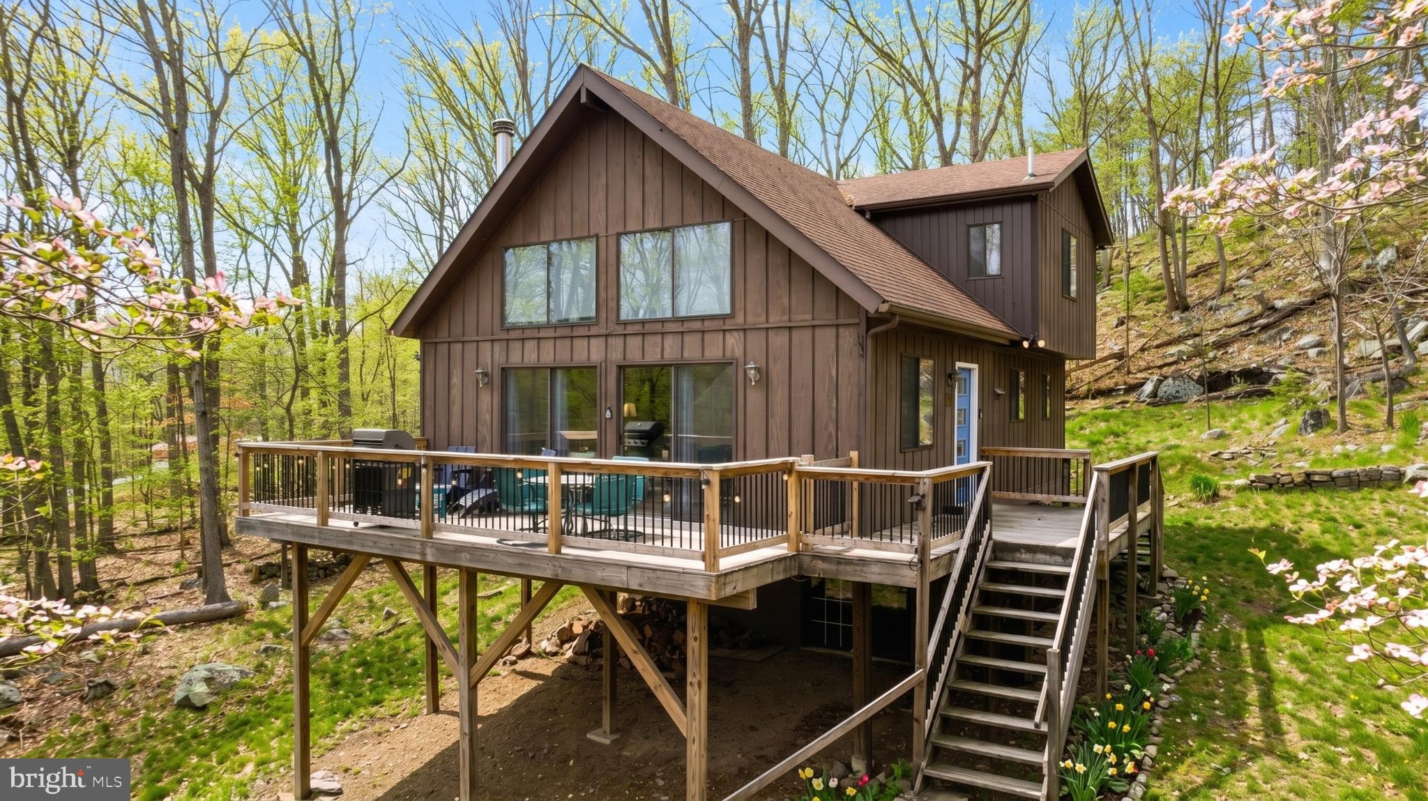 Charming fully furnished 3-bedroom, 2-bath secluded cabin, offering beautiful views and easy access to nearby walking and hiking trails – and only 5 minutes from Cacapon State Park. The home features a soaring two-story living area with vaulted wood ceilings, abundant windows, luxury vinyl plank flooring, and a cozy wood-burning stove. The open kitchen includes stainless steel appliances and flows naturally into the dining and living spaces, while a loft nook provides a peaceful spot for reading, working, or taking in the views. Mini-split systems provide efficient year-round heating and cooling, and a water filtration system adds everyday convenience. Outside you’ll find a spacious elevated deck overlooking the woods, ample outdoor seating for relaxing or entertaining, and a fire pit. Reliable Frontier Fiber internet makes the property equally appealing for weekend escapes or extended stays. As a vacation rental, the property has generated over $39,000 of rental income over the past year, comes fully furnished, and can include an existing property manager and cleaner for a seamless transition. See seller docs for detailed rental history and financials. $1,000 buyer credit available if you continue using the current property manager. Perfect full-time home, mountain getaway, or investment property!