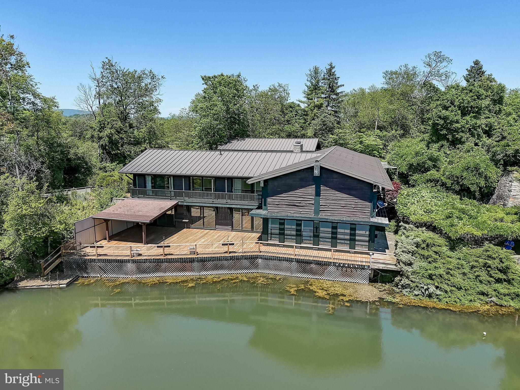 Situated on an expansive 41 acres off Spahrs Quarry Rd., "Auburn Springs" offers a unique retreat with breathtaking views of the Catoctin Mountains. A serene 5+ acre lake greets you upon arrival, with a circular driveway leading to the main house and a detached 3-car garage with an upper-level guest suite. A separate 2-car garage is tucked away nearby. Step onto the Wisteria-covered Terrace, leading to a Grand Room boasting panoramic views of the lake. The home features a Den, Kitchen, and Dining Room with a wine closet, opening to a covered porch and balcony. Upstairs, find a one-bedroom suite, guest room, and Owner's suite, each with balcony access. An additional two-story house with a detached 2-car garage serves as the caretaker's residence. Room count includes both properties. Enjoy recreational activities on the lake, including fishing, boating, and hunting. The property, just 6 miles from Camp David and 20 minutes from Frederick, Maryland, offers vast potential with permitted uses on the 28 acres north of Spahrs Quarry Rd. Discover the charm of Auburn Springs through its captivating pictures, 3D tour and floorplans.