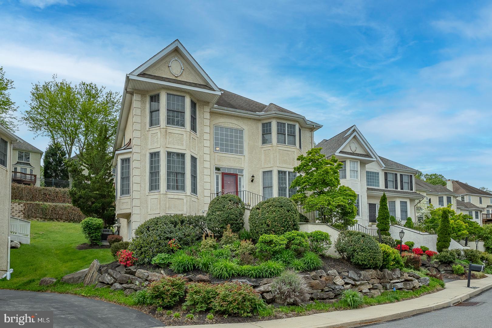 Welcome to 1109 Riverview Lane in the sought-after Merion Hill community, an elegant and beautifully appointed 3 bedroom, 3 full and 1 half bathroom residence offering 3,645 square feet of refined living space, complete with a private elevator for ultimate convenience. A gracious entry foyer with rich hardwood floors sets the tone and highlights a stunning curved staircase, flanked by a formal living room with crown molding and a sophisticated dining room featuring large windows and classic chair rail detail. The heart of the home is the expansive, open-concept kitchen designed for both everyday living and entertaining, featuring an updated kitchen with white wood cabinetry, quartz countertops, a center island, breakfast bar, and a sun-filled breakfast area. This space flows seamlessly into the dramatic two-story family room, anchored by a gas fireplace and walls of windows that flood the space with natural light, with direct access to a oversized rear deck and backyard.  A convenient half bathroom completes this level. Upstairs, the spacious primary suite offers a peaceful retreat with a sitting area accented by custom built-in bookshelves, two walk-in closets, and a luxurious en-suite bathroom with dual vanities and a large walk-in shower. A second bedroom and full hall bathroom with tub complete this level. The finished lower level provides exceptional flexibility, featuring a second family room with wet bar, an additional bedroom, full bathroom, and a private office, ideal for guests, in-laws, or work-from-home needs. Ample storage and direct access to the attached two-car garage add to the home’s convenience. Ideally located just minutes from major roadways and the vibrant shopping and dining scenes of Conshohocken and Villanova, this exceptional home offers the perfect blend of elegance, space, and accessibility.
