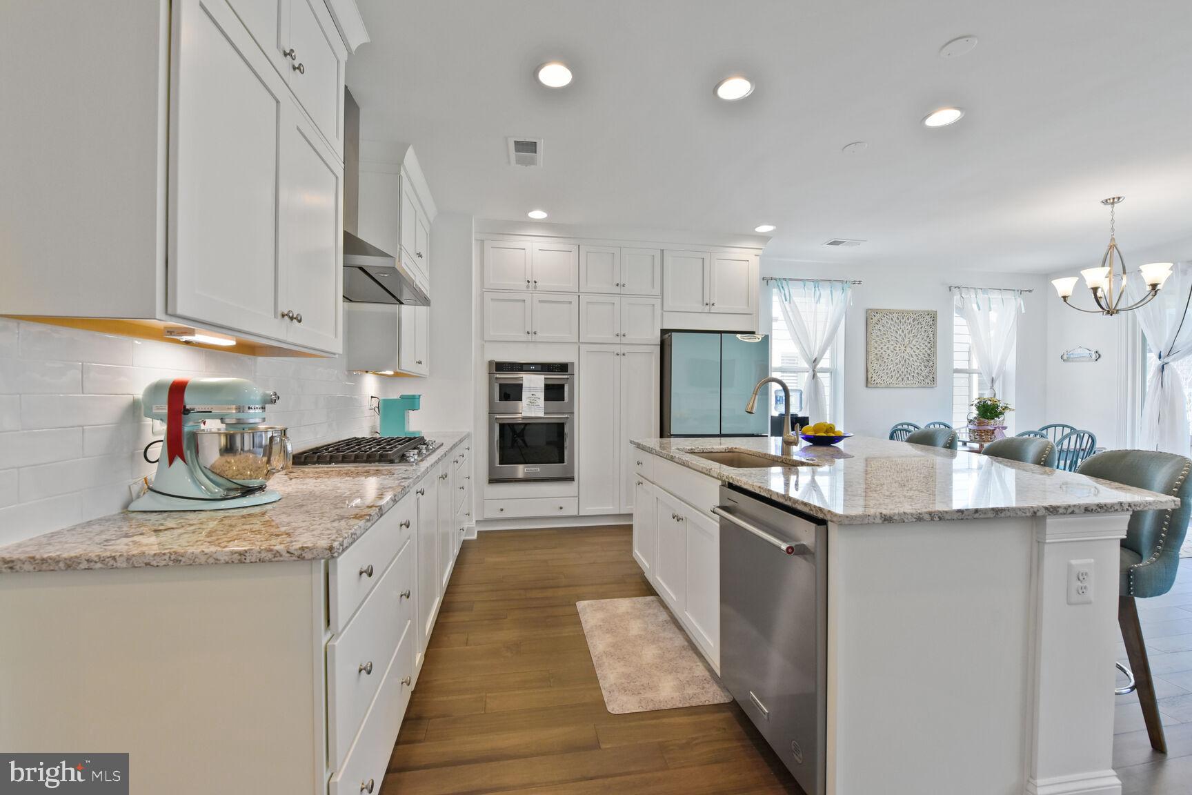 Welcome to this sun-drenched Aspen II model, offering the perfect blend of luxury and convenience with 2 bedrooms, an office, 2 full bathrooms, and a spacious 2-car garage—all designed for true single-level living. You’ll immediately appreciate over $74,000 in upgrades, including a dream kitchen (Shea's Signature model) featuring an expansive granite island, elegant white cabinetry that extends to the ceiling, and upgraded KitchenAid stainless steel appliances, including a sleek range hood and large pantry. The modern Samsung Bespoke refrigerator with a flex drawer completes the high-end kitchen experience.  Panels on the Bespoke refrigerator can be changed to different colors for those desiring a more traditional look.

The open-concept design seamlessly connects the living room, dining room, and conversation nook, allowing for easy entertaining and a natural flow between spaces. The 9-foot ceilings and abundant windows fill the home with natural light, creating an airy and bright atmosphere. In winter, gather around the gas fireplace with its stunning wood and marble hearth, while in summer, open the extra-tall sliding doors to enjoy your own covered patio with a lighted ceiling fan, perfect for relaxing with a cold drink or entertaining.
The spacious owner’s suite is an inviting retreat, with its 9-foot ceilings, large tiled shower, dual sinks on white vanities, and a generous walk-in closet. 

Throughout the common areas, rich brown engineered hardwoods create a cohesive, sophisticated look, while plush neutral carpeting enhances the comfort of both bedrooms. The laundry room is a highlight, complete with a sink, matching washer and dryer, ample cabinet and counter space, and a built-in trash bin—making everyday chores feel effortless.

Comfort is key with central air and a smart thermostat, while smart lights, a smart keypad for both the front door and garage, and a water softener provide modern convenience. Outside, the efficient irrigation system and fully fenced backyard with multiple gates create an ideal space for pets, gardening, or bird-watching.

The HOA handles the mowing, allowing you more time to enjoy the resort-like amenities—fish at the lake, dine at the award-winning Region's 117 restaurant, swim, work-out, walk your dog along 8 miles of scenic paths, or take him to the dedicated dog park. Play pickleball, enjoy a game of pool, shuffleboard or pinball, and take part in social events such as wine tastings, dancing, and live music around the fire ring.

The incredible Trilogy lake 55+ community is gated for added peace of mind, and with over 60 member-led clubs to choose from, there’s always something to do. This location offers amenities galore!  Whether you want to be social or simply relax with a good book by the lake, surrounded by nature, Lake Frederick offers an exceptional lifestyle in an unparalleled setting.