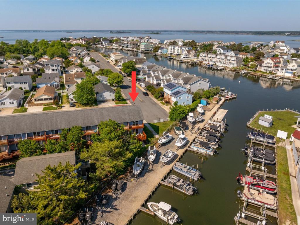 Welcome to one of the most entertaining waterfront views at the beach! From your FULLY FURNISHED upgraded beach retreat in North Ocean City!  You have a front row seat to the nonstop parade of boats, sunset skies and coastal energy  that makes this the PERFECT LOCATION.  Grab a drink, settle onto your deck and enjoy the same iconic views that locals and visitors flock to get at nearby Harpoon Hanna's. 
GORGEOUSLY RENOVATED END UNIT  townhouse-style condo in the quiet community of Caine Woods, just minutes from everything Ocean City and Fenwick Island have to offer. The main level features an open-concept kitchen/living area and half bath, while upstairs offers 2 bedrooms, full bath, and updated laundry for comfortable separate sleeping quarters.

Extensive upgrades include cherry hardwood flooring throughout, a stunning kitchen with upgraded quartz counters, custom cabinetry, stylish tiled backsplash, farmhouse sink, and island + peninsula. Additional features include tiled bathrooms with granite counters, Bose speakers, built-in shelving with desk space, plantation shutters, upgraded slider blinds, and solid-core doors. Plus enjoy private decks off both levels!

Restaurants, movie theater, putt putt, Freeman Arts Pavilion, shopping, entertainment, and of course the BEACH are all incredibly close by. Condo association allows short & long term rentals. Covered carport under unit fits 2 cars and includes storage for all your beach toys, plus an additional assigned parking spot in the private lot. Tax record square footage incorrect — actual unit size is approximately 905 sq ft.