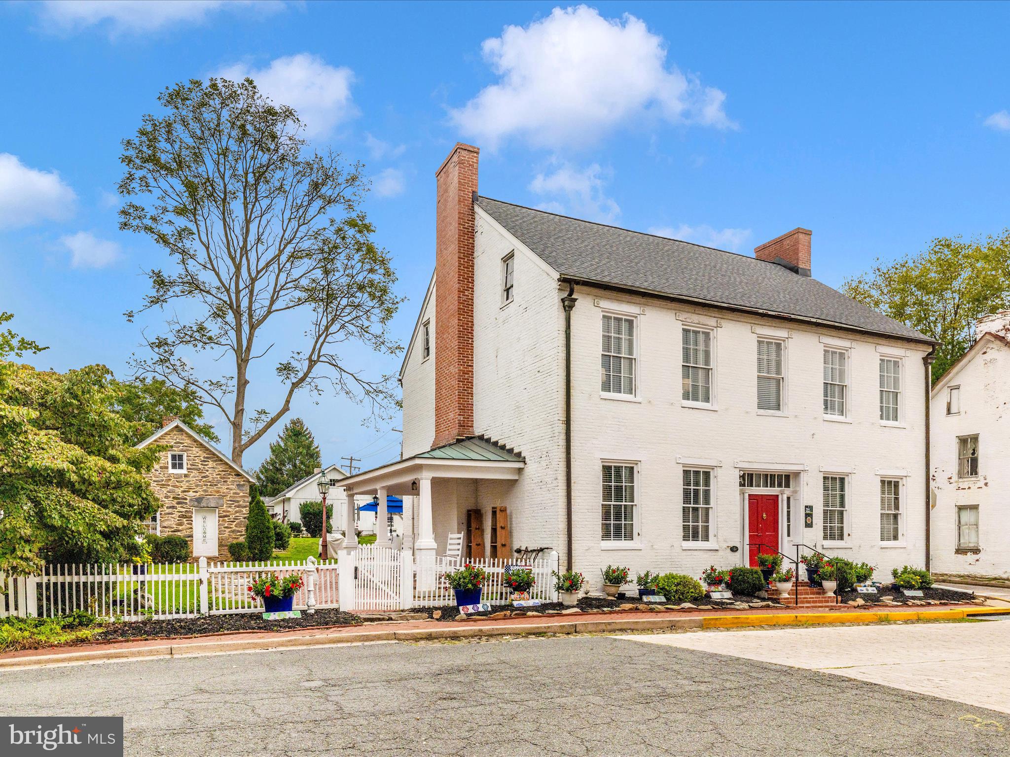 Spring into this delightful blend of historic charm and modern updates, ideally located in the heart of Burkittsville. This beautifully restored home offers timeless character with thoughtful improvements that make everyday living comfortable and inviting.

Step inside to find wide-plank floors, soaring ceilings, and classic architectural details paired with a fully updated kitchen featuring granite countertops, soft-close cabinetry, farmhouse sink, and premium appliances. The home offers spacious living areas, a flexible floor plan, and abundant natural light throughout.

Recent updates provide peace of mind, including major systems and cosmetic improvements that enhance both function and style.

Outside, enjoy a private, fenced yard with a brick patio and plenty of space for relaxing or entertaining. The detached garage and additional outbuildings offer versatility for storage, hobbies, or workshop space.

Located just minutes from commuter routes while surrounded by scenic countryside, this home offers the perfect balance of convenience and charm.

Prominently positioned on the village square, the home blends preserved architectural character with significant modern updates completed over the past two years. Improvements include two-zone HVAC systems, a 50-year architectural roof, updated electrical, refinished wide-plank floors, reglazed windows with storm inserts, fresh interior paint, new lighting, a remodeled main-level full bath, and a new water heater.

Inside, timeless details define the space—soaring 10-foot ceilings, vintage pocket doors, intricate moldings, built-ins, and decorative stone fireplaces that create striking focal points throughout. The kitchen has been thoughtfully redesigned with granite countertops, soft-close cabinetry, a farmhouse sink, premium appliances, under-cabinet lighting, and a generous pantry, seamlessly blending historic charm with everyday function.

With five bedrooms and two full baths, the layout offers flexibility and comfort. The rear upstairs room has been recently finished, adding valuable living space. The adjacent laundry area provides adaptable space with strong potential for future customization, including the opportunity to create a private ensuite bath.

Outdoor spaces complement the home’s character. A brick patio and flagstone walkway extend the living area outdoors, framed by a privacy fence and landscaped yard. The detached stone summer kitchen, complete with exposed beams and a large working fireplace, offers exceptional versatility as a studio, workshop, or creative retreat. A detached three-bay garage with new doors and electric service provides functionality rarely found in properties of this era.

Once serving as both a stagecoach inn and Civil War hospital, although Not on the Historic Registry, the home carries a rich local legacy while offering the comfort expected today. Located just minutes from Middletown, Brunswick, Frederick, national parks, and nearby wineries, it delivers the perfect balance of small-town charm and modern convenience.

Opportunities like this are uncommon—schedule your private showing and experience the craftsmanship, space, and setting for yourself.

Room measurements are estimated.