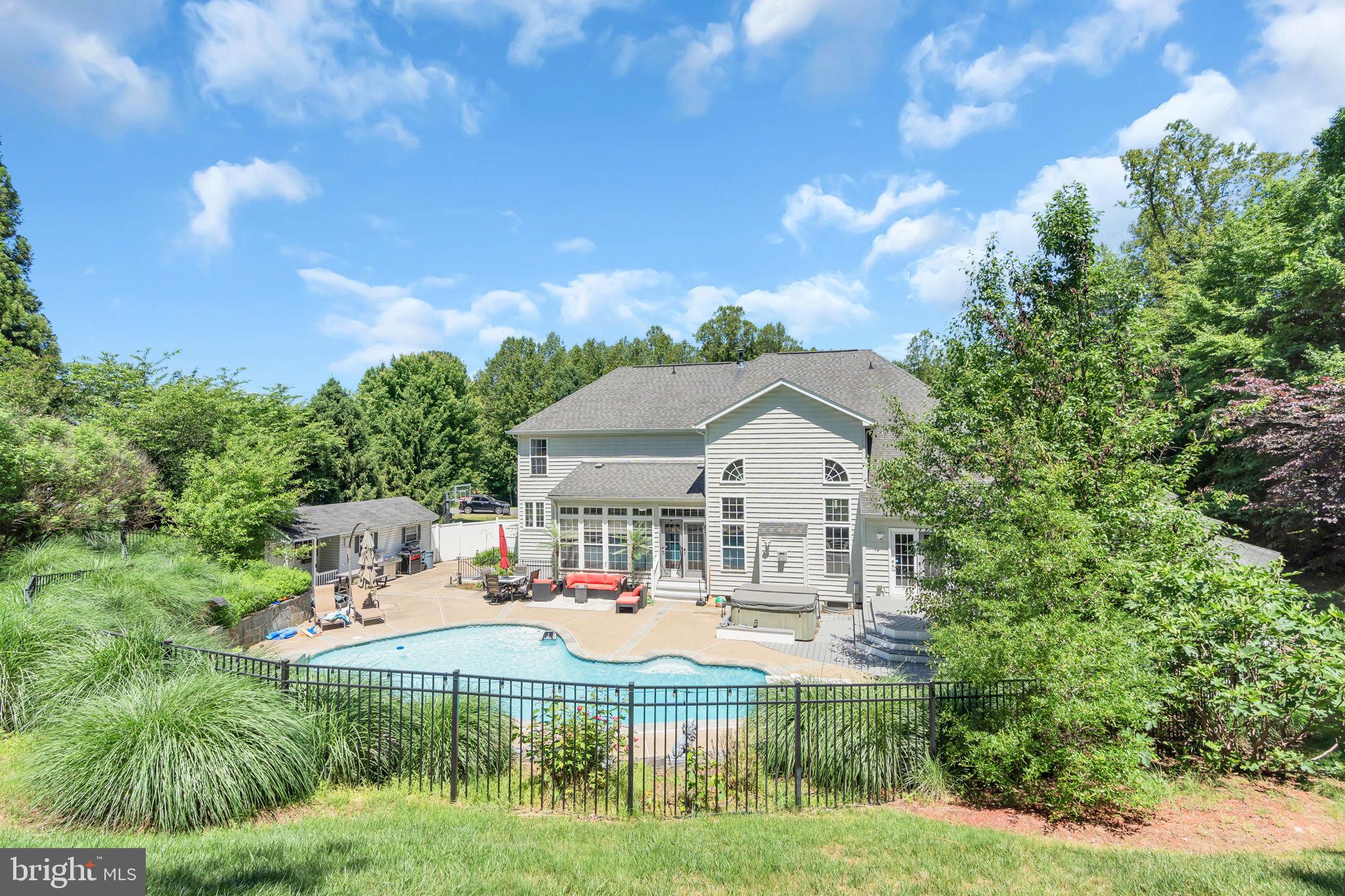 Exceptional luxury residence on a quiet cul-de-sac in Manassas, situated on a beautifully landscaped nearly 2-acre lot with over 6,400 finished square feet of resort-style living. This stunning 3-level home features 6 bedrooms, 5 full baths, a desirable main-level bedroom with full bath, and a private office with peaceful views—ideal for today’s work-from-home lifestyle.  Bright and light-filled throughout, the home offers elegant oak staircases, a spacious family room with stone gas fireplace, formal dining room, and a gourmet kitchen with oversized island, upgraded stainless steel appliances, granite countertops, abundant cabinetry, bar seating, and breakfast area.  Upstairs features luxurious bedroom suites, upgraded ceramic tile baths, expansive walk-in closets, a private en-suite secondary bedroom, and Jack-and-Jill bath. The fully finished walk-out basement is designed for entertaining with a recreation room, built-ins, wet bar, private home theater/media room, additional bedroom, full bath, workshop, and extensive storage space.  Enjoy your own backyard oasis featuring a custom 9-foot deep saltwater pool with waterfall and fountain features, new composite deck, screened gazebo, and large storage shed. Recent pool upgrades include a new pump, salt cell generator, sensor, and lighting.  Additional peace of mind comes from the recently replaced main sewer drain line, a significant improvement with an approximate $10,000 value.  Conveniently located near I-95, Route 234, Prince William Parkway, Quantico, Fort Belvoir, the Pentagon, FBI Academy, Sentara Northern Virginia Medical Center, shopping, dining, and major commuter routes. Zoned for sought-after Marshall ES, Benton MS, and Colgan HS.  ***Furniture, décor, and select items may be available for purchase separately. Nighttime exterior photo has been virtually enhanced to illustrate lighting and lifestyle potential.  ***OPEN HOUSE Sunday, May 31 | 1–4 PM