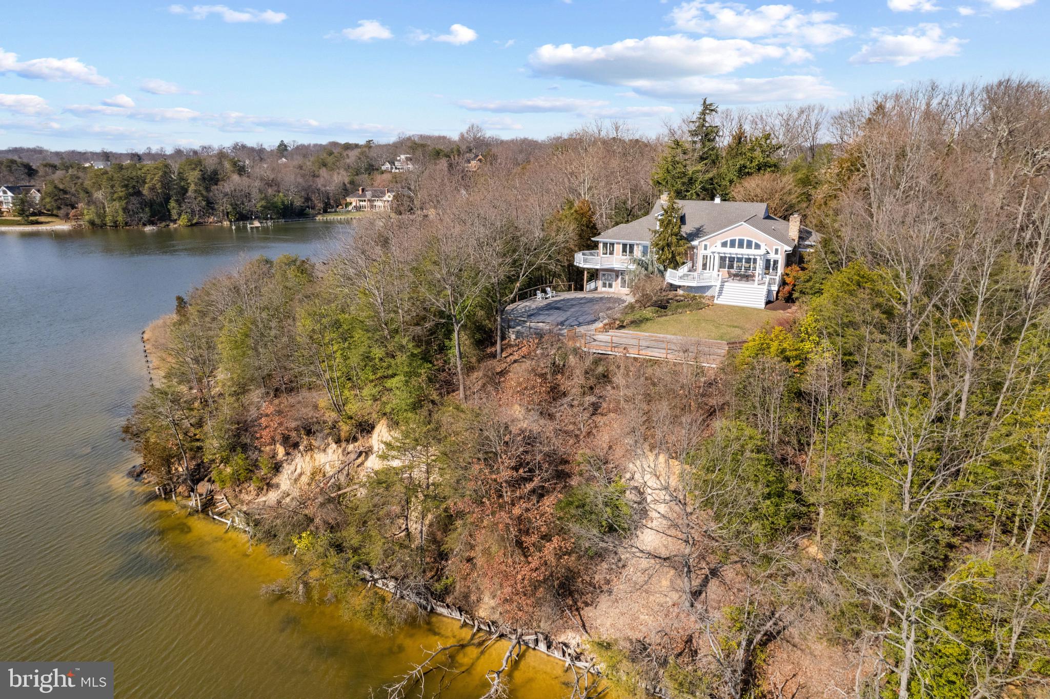 Indulge in the serenity of an extraordinary waterfront retreat on the shores of the majestic Severn River. A rare find just minutes from the heart of Severna Park, this sprawling 7-acre estate with 1600 feet of prime waterfrontage offers an unparalleled sanctuary, graced with endless vistas of the Severn River and the meandering beauty of Forked Creek. Elevate your lifestyle within the confines of a grand three-level residence, boasting a thoughtful layout that seamlessly captures views of the water and surrounding nature from every room.  With 4 bedrooms on the main level, including a spacious waterfront primary suite, there is plenty of room for everyone, while the finished basement with additional full bath provides endless possibilities.  The grand Living Room with soaring ceilings, stone fireplace and walls of windows perfectly captures the extensive views of Round Bay, the Severn River and beyond. The continuation of the water views from the Primary suite and the wrap around deck overlooking the pool and grounds provides tranquility at the end of the day. The well-appointed ensuite is complete with a water-view tub, allowing you to unwind in luxurious comfort. Destined to become a true legacy property, the elevated acreage is secluded amidst mature greenery and located on a point of land. The outdoor space is transformed into a haven of leisure with multiple decks and heated waterfront swimming pool, offering a captivating setting for both relaxation and entertainment. This is more than a residence; it is the embodiment of waterfront living along the Severn River's edge. Your private escape to a world enveloped by water and nature, and where each day is a celebration of panoramic beauty. Welcome Home!