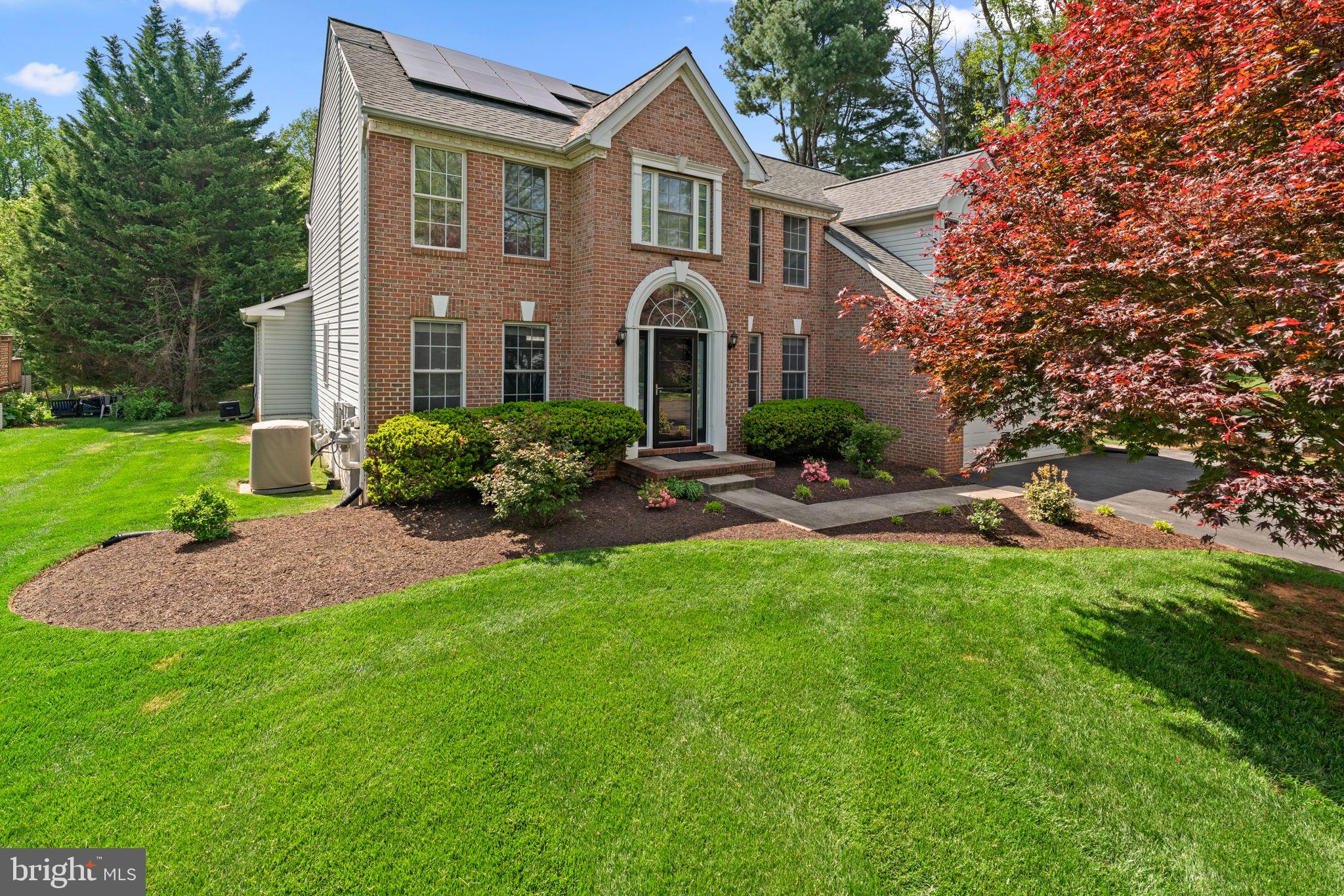 Stately brick-front Colonial situated on over half an acre in desirable Clary’s Discovery, surrounded by lush landscaping and offering exquisite indoor and outdoor living spaces—including a full in-law suite and pool. Step inside to find hardwood floors flowing throughout a traditional yet open layout, beginning in the grand foyer. To the left, the formal living room welcomes you with timeless elegance, while to the right, the formal dining room features a chair railing, a statement chandelier, and detailed wainscoting. The eat-in kitchen is a chef’s dream, boasting luxury vinyl tile, quartz countertops, stainless steel appliances, a central island with breakfast bar seating, a charming window bench, stunning tile backsplash, ample cabinetry, and direct access to the deck and laundry room. Hardwood floors continue into the expansive family room, highlighted by a soaring two-story ceiling, arched windows, and a cozy gas fireplace. Tucked off the family room is a convenient powder room and an exceptional main-level in-law suite or apartment featuring a sitting room or office with luxury vinyl tile flooring, a bedroom with built-in bookcases, a walk-in closet, and a full ensuite bath, and a full kitchen with stainless steel appliances and private deck access—ideal for guests or multi-generational living.

Upstairs, a lofted hallway leads to four bedrooms and two full bathrooms. The opulent owner’s suite impresses with vaulted ceilings, a walk-in closet, a sitting area, and a spa-like ensuite bath complete with dual vanities, a soaking tub, separate shower, and a private water closet. Three additional bedrooms feature luxury vinyl flooring throughout. The fully finished lower level offers a spacious recreation room with an open layout, including a designated game area with a wet bar and built-in bench seating, a versatile bonus room, a storage room, and a full bathroom. Outdoor living shines with two Trex® decks (updated in 2021), a stamped concrete patio, a beautifully landscaped and fenced yard bordered by mature trees, with a storage shed, stone firepit, and a stepping stone path leading to a private, filtered, heated in-ground saltwater pool, also updated in 2021 with a stamped concrete surround.