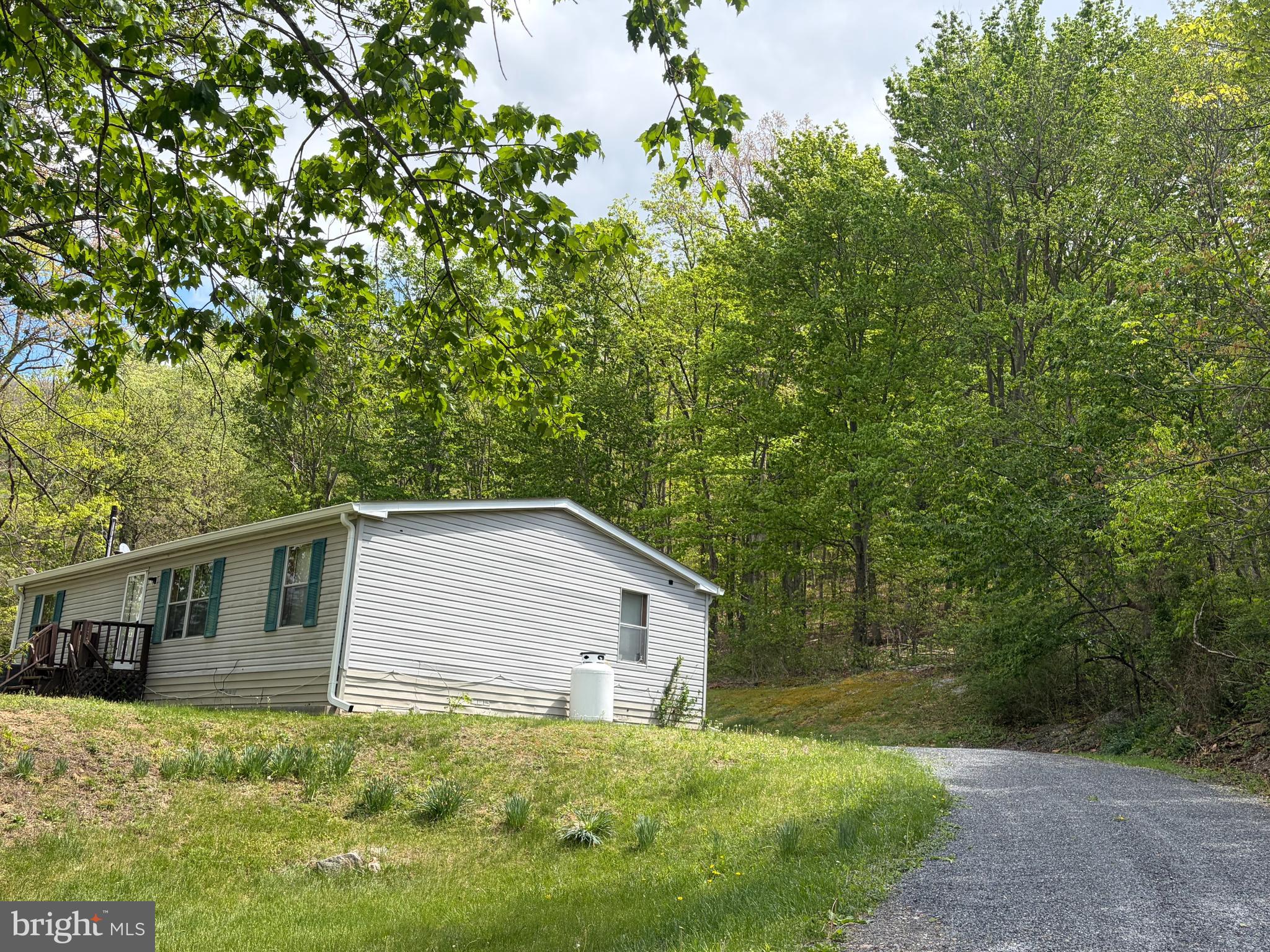 Quiet living on 5 unrestricted acres in Hardy County! The big ticket items are already done - Roof installed 2022, HVAC 2022, 50 gallon water heater 2025, whole house water filtration system 2024, driveway re-graveled 2025, gutters and gutter guards 2024. Over 1200 square feet of main level living space which includes 3 bedrooms, 2 full bathrooms, large kitchen with room for an island and table space, large living room, laundry room, and covered porch.  Property has public water and private septic tank, which was pumped in September 2022. The real estate taxes are super low too; less than $300/year. Circular driveway for easy ingress and egress. Home is being sold As-Is.