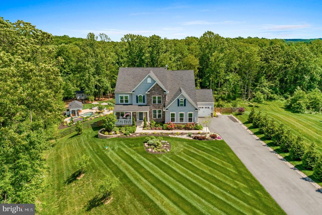 This is an exquisite custom estate situated on an incredible 1.22 acre lot that offers the ultimate serenity.   There are no two homes like this!  This 6 year old home looks barely lived in and has every upgrade.  Walk into this lovely two story foyer.  Wide plank luxury vinyl plank flooring on the first level.  Upgraded moldings throughout.   Wrought iron railings on the steps going up to the upper level.  Separate living room and dining room areas that are meant for entertaining.   Incredible Chef's kitchen with white cabinets, granite counters, Stainless Steel appliances and tile backsplash opens to a back morning room/breakfast area that creates an even larger entertainment space.  Two story family room with a stone fireplace with mantle and hearth opens to the kitchen.  First floor office so you an work from home comfortably and there is even an access from the office to the screened porch overlooking a stunning backyard.  Mudroom on first level has a seating area.   The upper level boasts a large primary bedroom suite with a wet bar and tray ceilings.   Primary bath has upgraded tile and granite vanities and upgraded fixtures.   Every bathroom in this home is upgraded with upgraded tile and granite  vanities and upgraded fixtures.  Three other large bedrooms on the upper level with two additional baths.  Fully finished basement with a stunning wet bar that is fully upgraded with granite , media room, exercise area with patio access and an upgraded full bath.  The backyard is an oasis!  It features extensive hardscaping throughout including the patio below the screened porch, walk-ways with lots of lush landscaping, a salt water pool with waterfall, an outdoor kitchen and a no- maintenance deck.   There is also a bathroom outside for a changing area.   Lovely shed in the back for more storage.  Lastly, enjoy the firepit area amidst the trees on a chilly night with friends.  It is also fully fenced (newly stained)  and backs to trees.  Other features include a generator and a full outdoor speaker system.  Every single detail have been accounted for.