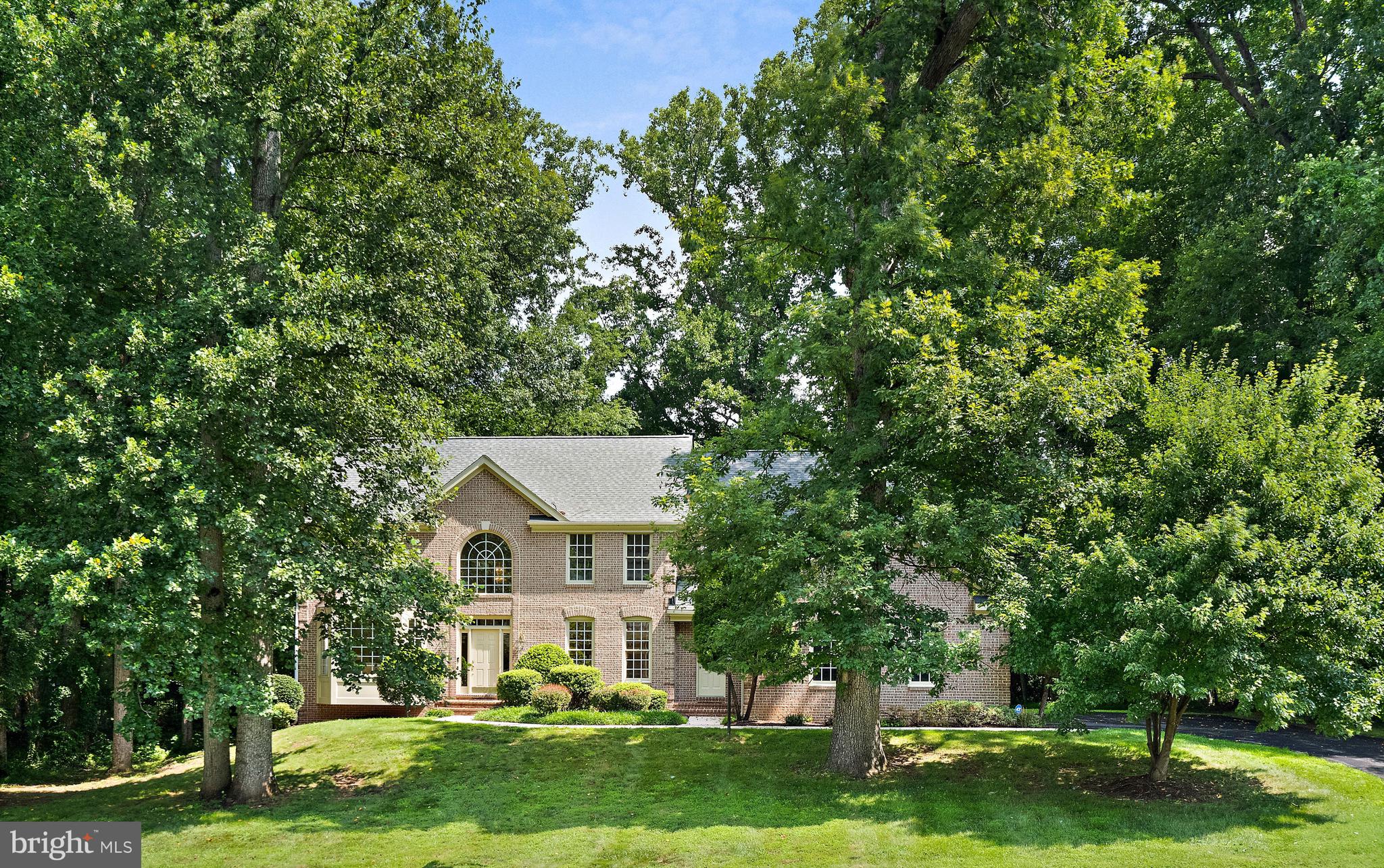 Welcome to this beautiful 4 bedroom, 4.5-bath home offering timeless elegance, generous living spaces, and thoughtful updates throughout. From the moment you enter, you'll be greeted by a dramatic two-story foyer with hardwood flooring, an elegant split landing staircase, and abundant natural light. The spacious main level features formal living and dining rooms, a warm family room with cathedral ceilings and a wall of windows overlooking the backyard, and a handsome library complete with custom built-ins and French doors. The kitchen is designed for both everyday living and entertaining, featuring granite countertops, a large center island with cooktop, tile flooring, recessed lighting, abundant cabinetry and counterspace. A bright breakfast area opens to the expansive re-stained deck, creating a seamless indoor-outdoor flow. Upstairs, the spacious primary suite offers a peaceful retreat with a sitting room, tray ceiling, walk-in closet and a luxurious bath featuring a soaking tub, walk-in shower, and dual vanities. Three additional bedrooms complete the upper level, all with custom closet shelving, as well as two more full bathrooms. The finished walk-up lower level provides exceptional flexibility with a large recreation room featuring a gas fireplace, built-in bookshelves, wet bar, dedicated exercise room, wine cellar, full bath, and bonus room. Recent improvements include a new roof (2026), new driveway (2024), re-stained deck (2026), and a commercial-grade sump pump for added peace of mind. A side-load garage with a solid wood door and beautifully designed living spaces make this exceptional property the perfect place to call home.