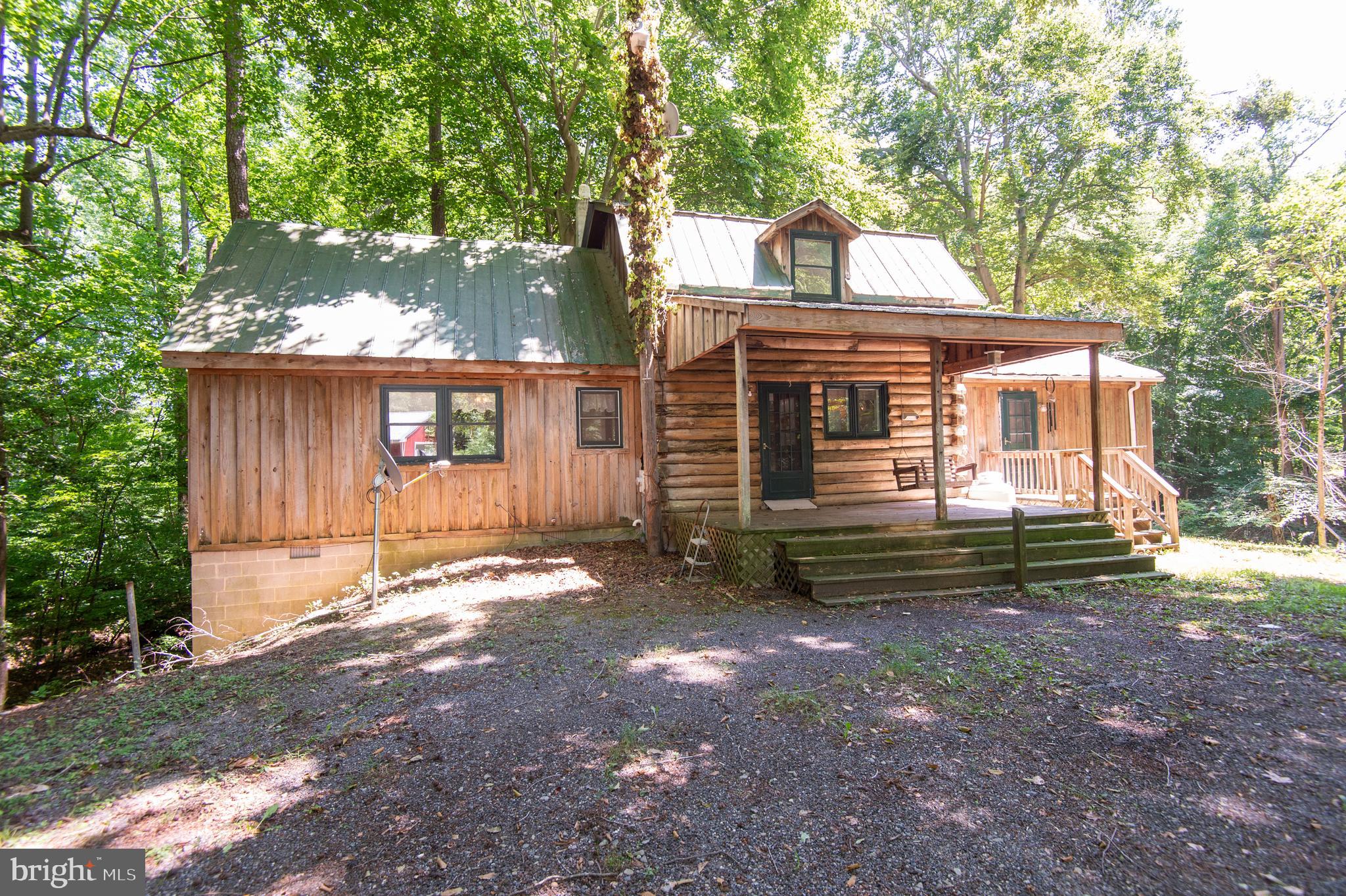 Very rustic and private 3 bedroom, 1 and a 1/2 bath log cabin on 15 private wooded acres. There is a large building and a sun porch overlooking a stream running through the property. Excellent hunting property for whitetail deer and turkey!