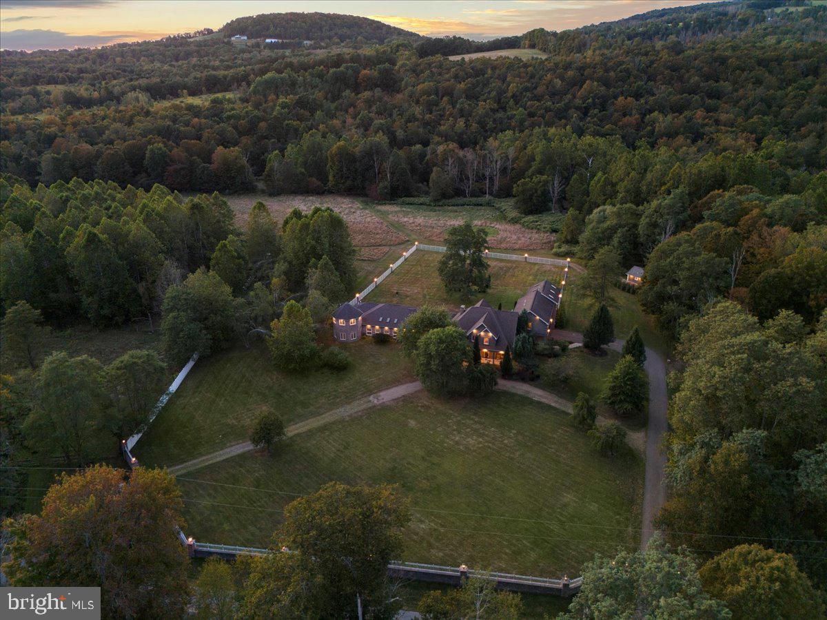 $350K IN ANNUAL AVG INCOME In the heart of the Endless Mountain Range, The Manor at Elk Mountain offers living space designed for gathering and retreat with accommodations for OVER 26 GUESTS plus a 2BD 1 BA CARRIAGE HOUSE. The estate is utterly PRIVATE, immersed in nature, and enjoys rare TRANQUILITY FREE FROM ROAD NOISE AND AIR TRAFFIC. A creek winds through the property, STOCKED WITH TROUT and offering a REFRESHING SWIMMING HOLE, while the wooded back acres provide space for HUNTING, RIDING, AND HIKING. Amenities include aN INDOOR HEATED POOL AND SPA, game room, and pool tables, libraries, and smart TVs. Outdoors, patios, lawns, and gardens frame the home with grilling and gathering areas. Concierge, chauffeur, private chef, yoga, massage, and staff services are available regionally. MINUTES FROM ELK MOUNTAIN SKI RESORT, the property offers premier skiing while preserving the feel of a secluded sanctuary. Beyond winter, the region offers hiking, biking, kayaking, horseback riding, golf, wineries, and state parks. A VRBO PREMIER PARTNER and AIRBNB SUPERHOST, the Manor commands NIGHTLY RATES OF $1,995OFF-SEASON and $2,295 DURING PEAK PERIODS. Its scale, amenities, and privacy make it a destination for REUNIONS, RETREATS, WEDDINGS, AND MILESTONES. NO ZONING. For international or tristate buyers, the Manor offers a rare opportunity: a private sanctuary where nature, recreation, and income converge. ADD LOTS could be avail with equestrian facilities or add acreage