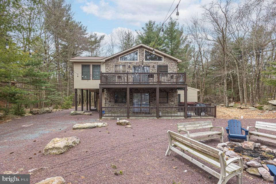 Expansive stone-front Pocono vacation home nestled in popular Lake Harmony Estates with access to it's own private community beach, tennis courts, rare Power boat Lake Harmony, as well as Jack Frost and Big Boulder slopes! This perfect investment property is ideal for guests, boasting 7 bedrooms including 2 primary suites, 4 baths, 6-8 car parking, huge firepit for roasting marshmallows, and lush yard with pretty outdoor lighting, rare central air, an oversized trex deck, and large hot tub! The sundrenched great room boasts gleaming hardwood floors, dramatic stone fireplace, cathedral vaulted ceilings with knotty pine, stunning wall of windows, and bright sliders to the Trex deck. The gourmet kitchen features granite countertops and island, stainless steel appliances, wine fridge, recessed lighting, and opens to a large dining area. The expansive family room features a game room/media room with wet bar/ kitchenette that can be easily used as an in-law suite, wide-plank LVP flooring, and propane stone fireplace! The two primary suites on each level have huge closets, plush carpeting, and their own full bathrooms. The additional bedrooms are also spacious, with large closets, wall-to-wall carpets, and neutral paint. The four season sunroom can also be used as a bedroom or library. Plenty to do at the Pocono Raceway, Camelback, Camelbeach, Split Rock's indoor waterpark, Kalahari, Mt Airy Casino, Pocono Premium Outlets, Hickory Run State Park, golfing & whitewater rafting in Jim Thorpe! Approx 210K income. (165K on platforms plus private bookings).