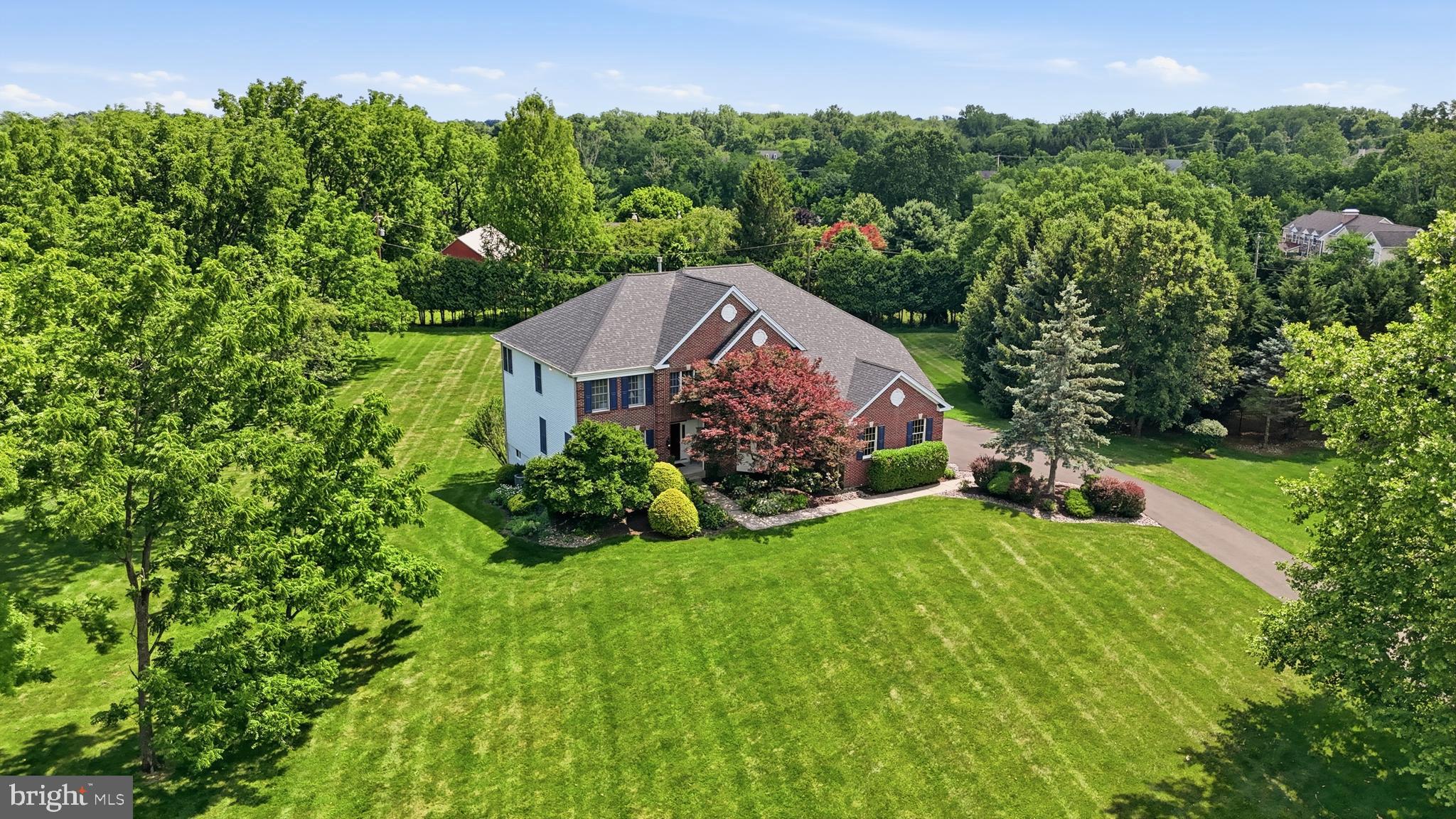 Where refined architecture, elevated ambiance, and more than $350,000 in distinguished enhancements converge, this exceptional four-bedroom residence with Bonus Room offers a sophisticated lifestyle just moments from Newtown Borough. Privately positioned on the largest homesite within an intimate cul-de-sac enclave, the property pairs coveted walkability to downtown Newtown with convenient access to shopping, dining, public water and sewer, and impeccable move-in condition. A gracious, generously proportioned floor plan is enriched by contemporary refinements, including a dramatic volume-ceiling Great Room, sunlit open living spaces, a private Study with serene nature views, and a fresh, understated neutral palette. Upon entry, sightlines extend gracefully toward the expansive rear grounds, while natural light beautifully reflects across the white oak herringbone flooring. Thoughtful enhancements are evident throughout, most notably in the beautifully updated baths and the showstopping Primary Bath. Designed with a resort-inspired sensibility, the Primary Bath features a steam shower, freestanding soaking tub, radiant heated flooring, and exquisite marble finishes. Additional amenities include a finished walk-out Lower Level with a dedicated gym, flexible living space, and a full bath, along with a newer roof, new water heater, water filtration system, newer driveway, upgraded upper-level carpeting, smart thermostat, ample driveway parking, and a three-car garage with EV charger. Outdoor living is equally impressive, offering a choice of the lower bluestone covered patio with saltwater hot tub or the expanded upper composite deck, each overlooking a beautifully sized, tree-lined rear yard designed for private relaxation and refined entertaining. With convenient access to the I-295 corridor for travel to Philadelphia, Princeton, and New York City, and located within the award-winning Council Rock School District, this residence presents a rare opportunity to experience the very best of elevated Bucks County living.