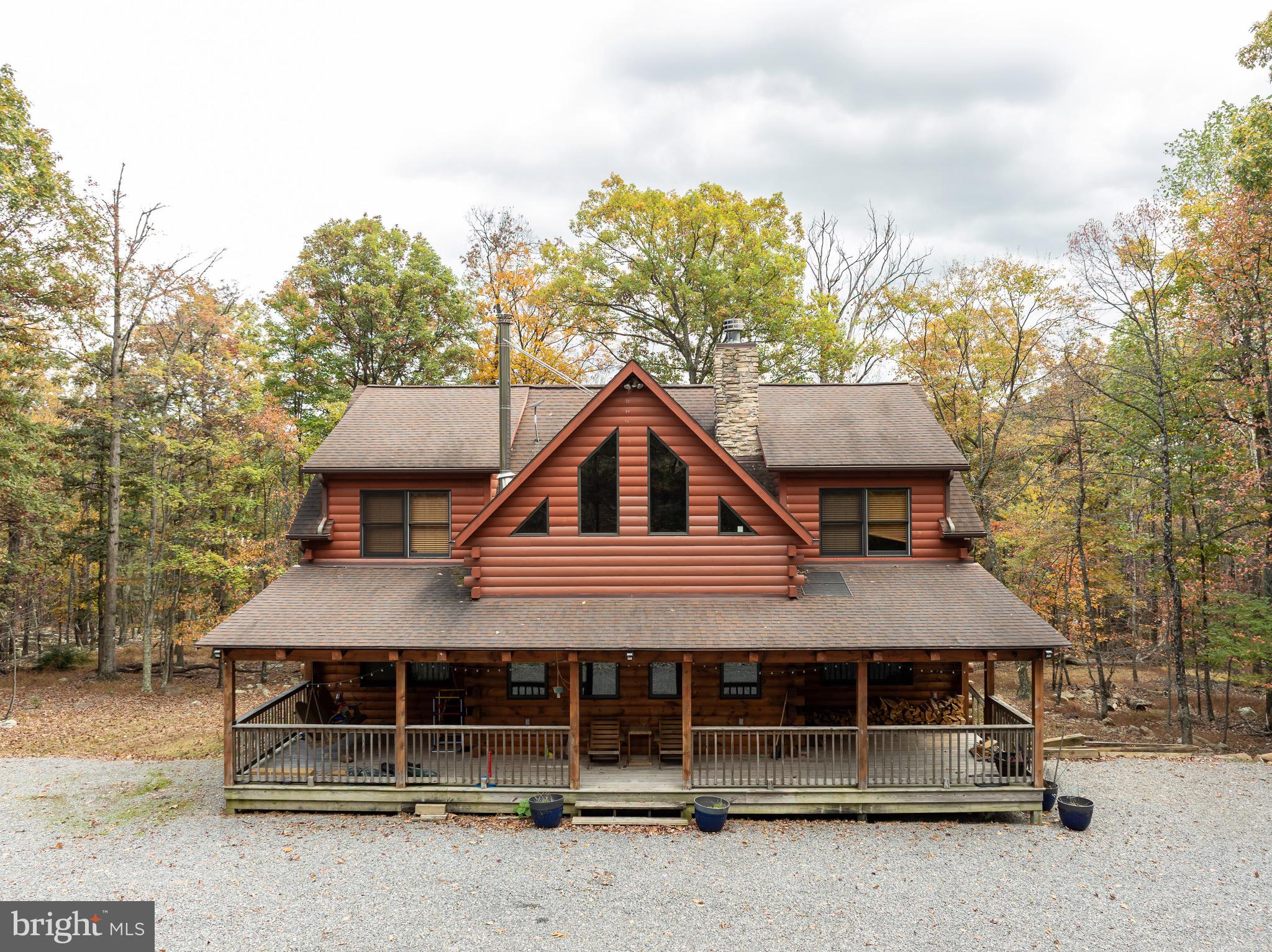 Welcome to this well-maintained log home situated on a 2.25-acre wooded lot near Cacapon State Park. Conveniently located just off Route 522 and close to the state line, this property offers an easy commute while providing the privacy and charm of mountain living.
The home features a spacious two-story living room with exposed beams and abundant natural light. With five bedrooms, four full baths, and one half bath, there is ample space for family and guests. The open layout and warm wood finishes throughout create a comfortable and inviting atmosphere.
All furniture conveys with the sale, making this property truly move-in ready.
Enjoy the peaceful wooded surroundings from the covered porch or take advantage of nearby outdoor recreation opportunities at Cacapon State Park. Located just a short drive from downtown Berkeley Springs, this property combines convenience, comfort, and rustic appeal.