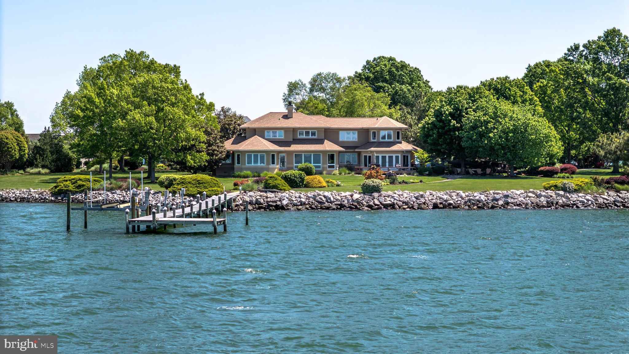 Sited on Cox Creek with 369 feet of waterfront, this elegant contemporary residence offers 2.3 private acres, spectacular western exposure, and breathtaking sunset views. Thoughtfully designed to maximize water vistas from nearly every room, the home features 4 bedrooms, 3 full baths and 2 half baths, and approximately 4,717 square feet of refined living space.
The gourmet kitchen is appointed with rich custom cabinetry, granite countertops, upgraded stainless steel appliances, and a gas cooktop, creating an ideal setting for both everyday living and entertaining. Custom hardwood flooring spans the main level, complemented by two fireplaces and timeless architectural details throughout.
The luxurious main-level primary suite offers serene water views, multiple walk-in closets, and a recently renovated spa-inspired bath. A beautiful three-season room overlooks the creek, providing the perfect space to relax and enjoy the tranquil setting. There is also ample room to add a pool.
Upstairs, three additional bedrooms and two full baths provide comfortable accommodations for family and guests, with three of the four bedrooms enjoying water views. The upper level has been recently updated with luxury vinyl plank flooring in place of carpet.
Additional highlights include mature professional landscaping, a temperature-controlled wine room, a 3-car garage, a new roof, private pier with electric and water, boat lift, jet ski lifts, and riprap shoreline protection.
Located in the desirable Southwind community, residents enjoy amenities including a boat launch, boat storage area, tennis courts, walking trails, and a clubhouse — all conveniently located near shopping, dining, and more.