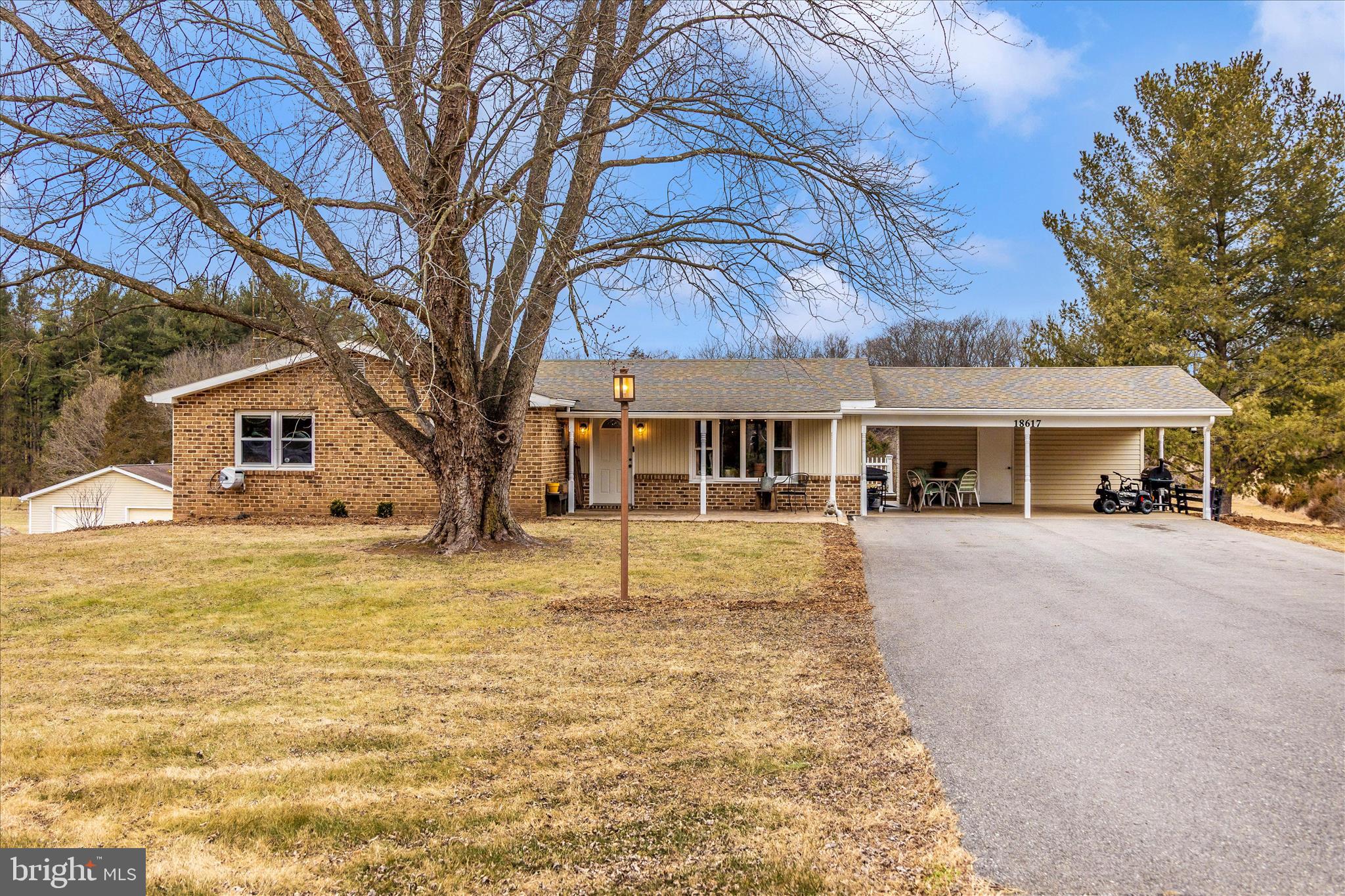 Private, peaceful, and move-in-ready, this rancher sits on over 3 acres with wooded views beyond the property line and beautiful sunset views from the expansive rear deck. The major systems and components have already been updated.  
The main level offers three bedrooms and two full bathrooms, including primary bedroom with ensuite and a generously sized second bedroom.  The fully finished, walk-out basement includes a kitchenette and provides excellent flexibility for guests, multi-generational living, or extended living space, with the potential to easily add an additional bedroom and bathroom. 
Some of the recent improvements include a new HVAC system with professionally cleaned ductwork, moisture barrier and insulated crawlspace, updated electrical panels, refinished hardwood floors throughout the main level, and underground electric dog fence.  
An attached two-car covered carport with additional storage provides everyday convenience, while an oversized detached garage with electric adds exceptional value -- ideal for vehicles, a workshop, or storage space.  The garage features a 45,000 BTU heater, window a/c unit that conveys, and measures 40'x30'.
There's no need to wait or overthink this one--schedule your tour, move right in , settle in comfortably, and look forward to an abundant summer blueberry harvest from your own mature blueberry bushes.