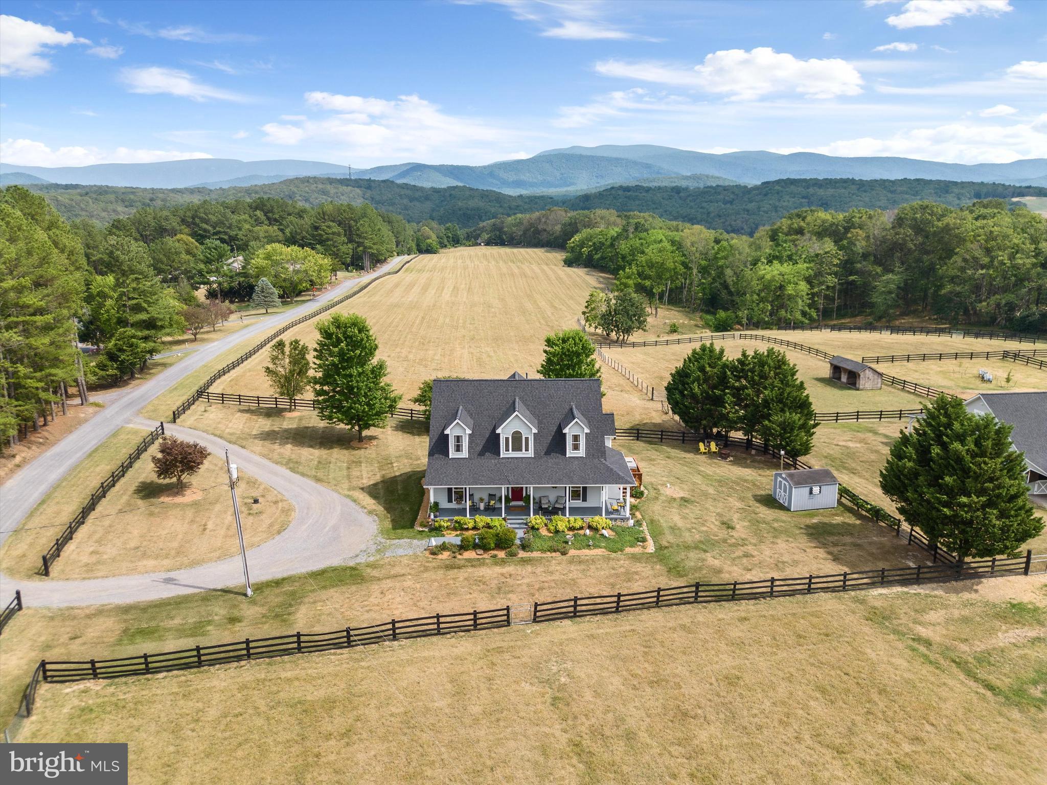 Premier 30-Acre Equestrian Estate Bordering George Washington National Forest. Shown by appointment only, no drive-bys. This is your chance to own this equestrian estate spanning 30 acres in Bentonville, VA, where tranquility meets adventure with unparalleled access to nature and outdoor activities. Bordering the George Washington National Forest on two sides and just a short hike or ride from the Shenandoah River State Park, this property is a haven for both equestrian enthusiasts and nature lovers alike. A six-stall horse barn features a concrete center aisle layout. Complete with a tack room/office, bathroom with hot and cold water, and a spacious hayloft, it offers a seamless blend of rustic charm and modern convenience for horse care and management. Adjacent to the barn, a spacious Conestoga building with skylights and electricity serves as an indoor riding arena, providing a versatile space for year-round riding and training. The arena is complemented by an outdoor riding arena with lights, catering to a variety of equestrian activities. New skylights were installed in 2024. Ensuring reliable water supply, the property includes an agricultural well, essential for sustaining livestock and supplying water to the homestead. Ten meticulously maintained pastures, including four run-ins and five paddocks, are enclosed with 3 & 4 board fencing and no-climb horse fence, prioritizing safety and security for horses. With direct access to the George Washington National Forest, enjoy endless trails for horseback riding, hiking, hunting, and outdoor adventures. The serene backdrop invites exploration and relaxation amidst nature's beauty. Access the Cullers Overlook horseback riding trail within the Shenandoah River State Park, offering picturesque views and a unique opportunity to explore the natural wonders along the Shenandoah River. Historically successful in boarding horses and raising Suffolk, Hampshire, and Polypay sheep, kunekune pigs, and a coop that currently houses a flock of 75 chickens, the property supports a variety of agricultural activities, presenting an opportunity for continued farming pursuits. The traditional 3-bedroom Cape Cod residence has been enhanced with a covered front porch, rear deck, and side deck with a hot tub. A new roof with architectural shingles was installed on house in 2023. Additionally, new AC units for the dual-zone HVAC were installed in 2024, and fencing repairs and painting have enhanced functionality and aesthetics. More recent updates include include new carpet in the primary bedroom and throughout upstairs, new kitchen tile and fresh interior paint. A well pump and hot water heater replacement in 2014 ensure efficient water management.