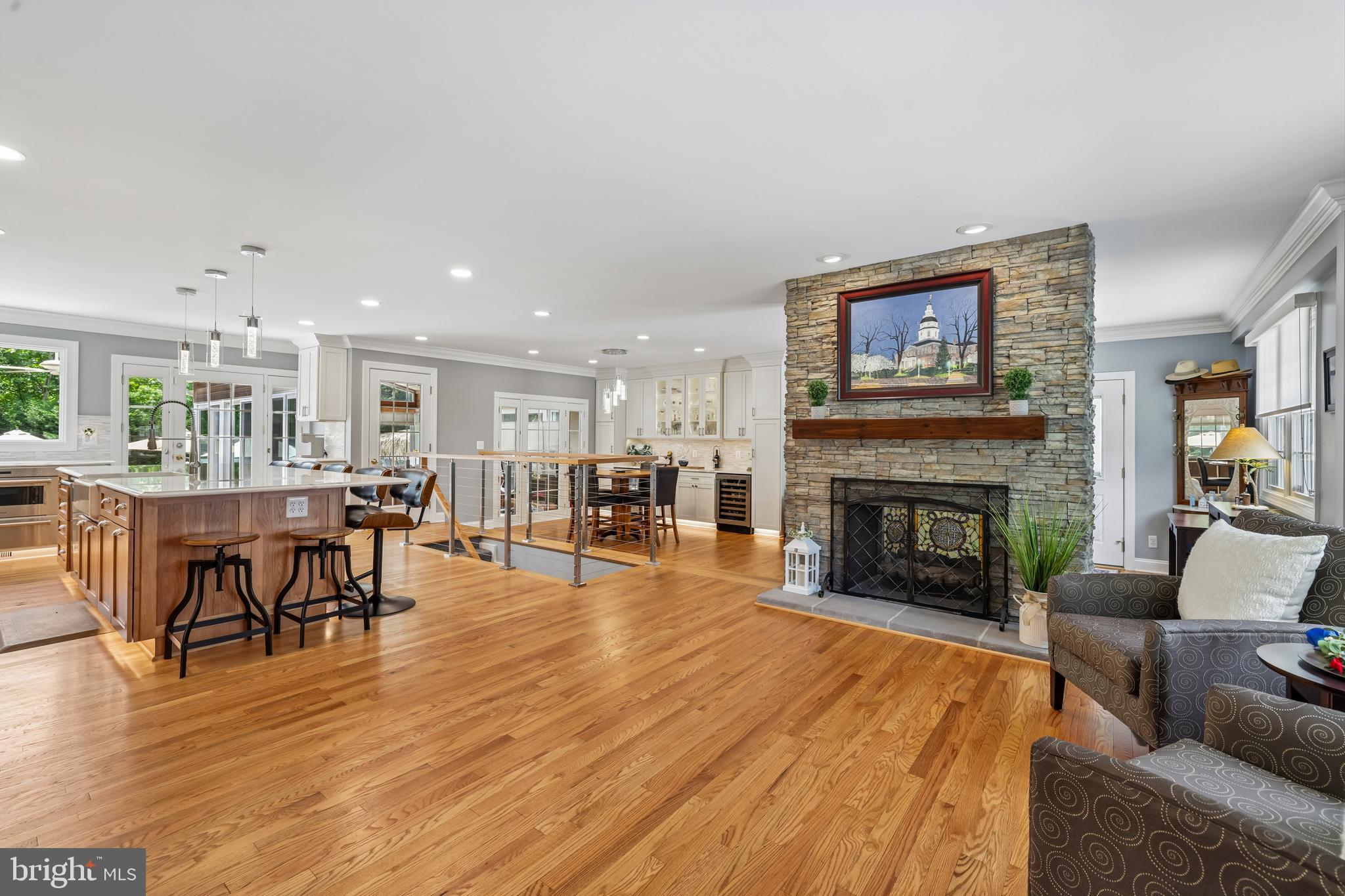 Welcome to this impeccably maintained and extensively updated ranch-style residence, offering an exceptional blend of luxury, comfort, and resort-inspired living just minutes from historic Annapolis. From the moment you arrive, the quality craftsmanship and meticulous attention to detail are evident throughout. At the heart of the home is a beautifully appointed gourmet kitchen featuring premium Wolf appliances, abundant custom cabinetry, quartz countertops, a beverage and wine refrigerator, and generous space for both everyday living and entertaining. Two double-sided gas fireplaces—one shared by the living room and the other featured in the primary suite—offer both warmth and architectural elegance, adding a distinctive touch to this exceptional home. Recent renovations have enhanced the home's appeal, highlighted by a spectacular oversized primary suite designed as a private retreat. The suite features a spacious walk-in closet and a spa-inspired ensuite bath complete with heated floors, instant hot water, and integrated Bluetooth speakers/exhaust fan. The fully finished lower level offers remarkable flexibility with luxury vinyl plank flooring, a custom wet bar with a full-size refrigerator/freezer with ice maker, a full bath, and a private exterior entrance—ideal for entertaining, hosting guests, multigenerational living, or a home-based business. Outdoor living is equally impressive. The fully fenced backyard is surrounded by mature landscaping, creating a private setting that rivals a boutique resort. Enjoy the heated in-ground pool, newly replastered in 2024, relax in the 15-foot swim spa, or entertain with ease at the custom-built tiki bar and outdoor kitchen. Thoughtfully designed, the tiki bar features a built-in grill, refrigerator, stainless steel storage, accent lighting, television, and bar seating. A stamped concrete pool deck and expansive composite deck with cable railings provide multiple spaces for gathering, dining, and unwinding. Adding even greater versatility is the detached pool house, complete with electricity and air conditioning. Whether used as a home office, fitness studio, creative workspace, or private retreat, this space offers endless possibilities. Additional highlights include a brand-new stamped concrete driveway with parking for up to five vehicles. Combining sophisticated interior finishes with extraordinary outdoor amenities, this turnkey property delivers a lifestyle rarely found in such a convenient Annapolis location.