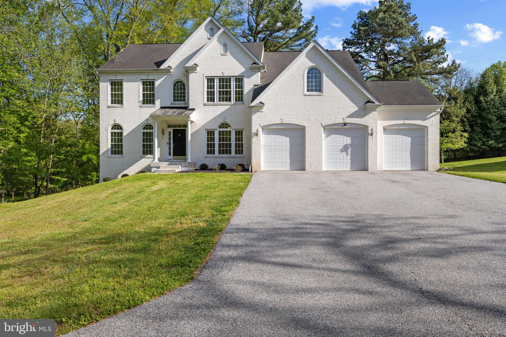 Set on a private, wooded homesite at the end of a quiet no-through street in highly desirable Ellicott City, this stately Colonial offers over 5,500 square feet of refined living, where timeless architecture meets thoughtful design. Rich maple hardwood floors, intricate millwork, classic columns, and a soft, neutral palette create a sense of understated sophistication throughout. // A gracious foyer introduces the home, elegantly framed by formal living and dining rooms, each adorned with striking tray ceilings. The living room is enhanced by graceful arched windows, while the dining room is illuminated by Palladian windows, accented with a classic chair rail and a statement chandelier that sets the tone for elevated entertaining. // At the heart of the home, the expansive great room unfolds with a beautifully appointed family room designed for both comfort and connection. Anchored by a gas fireplace, the space is filled with natural light from transom windows and enhanced by architectural bay detailing, all overlooking serene wooded views with seamless access to the outdoors. // The adjoining gourmet kitchen is designed to impress, featuring premium GE Monogram appliances, including a six-burner gas cooktop, double ovens, and a built-in griddle. A substantial center island with breakfast seating and designer lighting anchors the space, complemented by granite surfaces, custom maple cabinetry, a walk-in pantry, and a sunlit breakfast area with exterior access. A butler’s pantry, refreshed laundry room, and a private main-level bedroom with dual-access full bath add both convenience and flexibility. // Upstairs, the primary suite offers a true retreat, complete with a private sitting room and three closets, including two walk-ins. The spa-inspired bath features dual vanities, a deep soaking tub, an oversized walk-in shower, and a private water closet, creating a serene, restorative space. Secondary bedrooms are generously proportioned, including a shared bath arrangement with walk-in closets and an additional ensuite bedroom offering privacy and comfort for guests or family. // The fully finished walkout lower level extends the home’s versatility, featuring an expansive recreation area, multiple bonus spaces, and a full bath. An additional room with a closet and dual-access bath provides an ideal setting for guests, a home office, or extended living. // Surrounded by mature trees along the side and rear, the outdoor setting offers exceptional privacy and a peaceful natural backdrop—an ideal extension of the home’s refined interior. Select photos feature virtual staging.