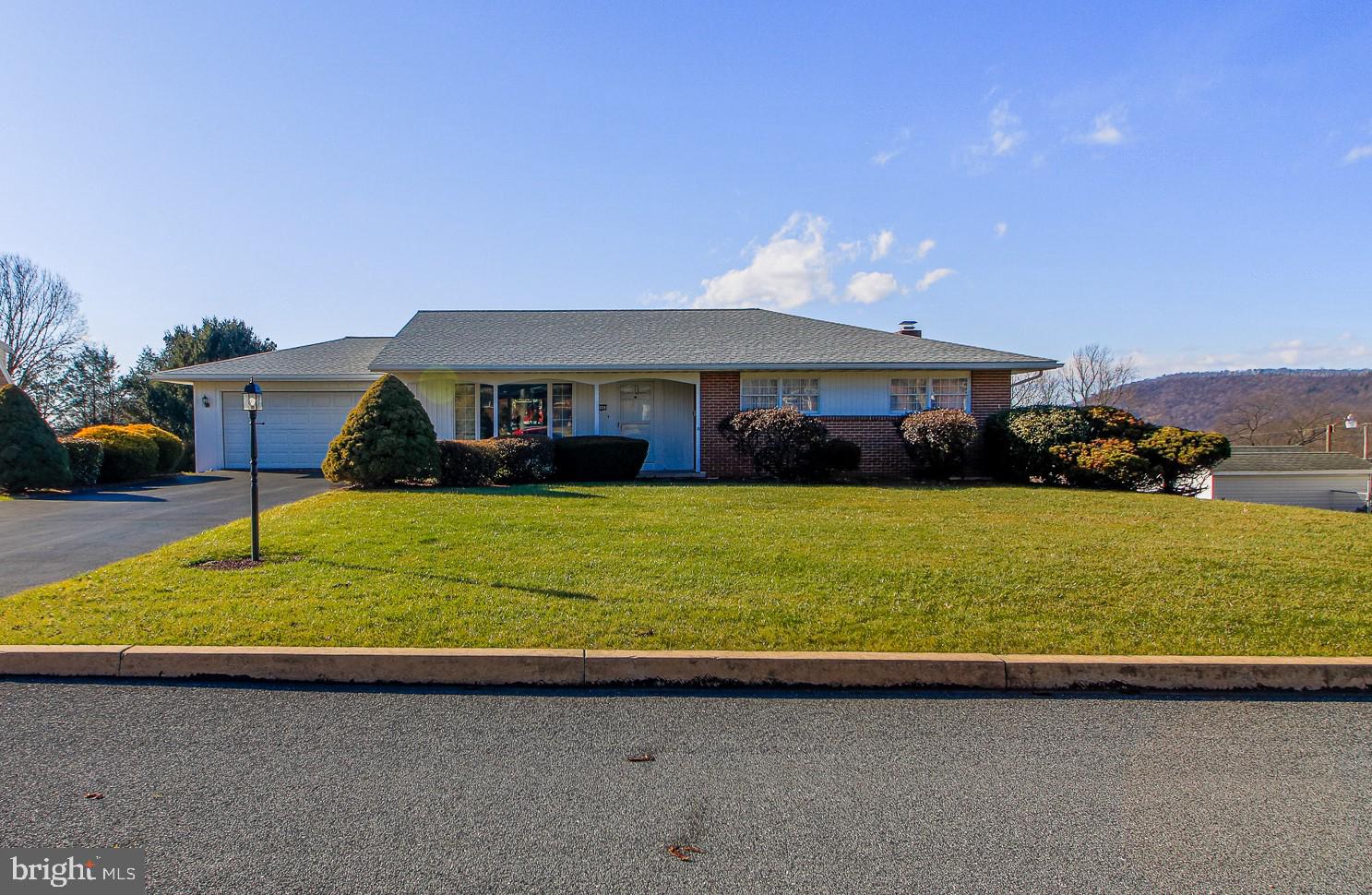 *****Multiple offers received. Please submit highest and best offer by noon on Monday.  PLEASE BE AWARE that HAMBURG REQUIRES A SIDEWALK TO BE INSTALLED...THIS WILL BE THE RESPONSIBILITY OF THE BUYER.******

This very well maintained 3 bedroom ranch house faces east and, Fung Shui followers belive this brings harmony, prosperity and good luck to those who live there. Morning sun bathes the living room and covered front porch. The ranch style house, with a two car garage, is on a large, .34 acre lot. In the evening you can watch the sunset over the Blue Mountains from the large deck or from the picture windows in the kitchen and dining room. The eat-in kitchen with beautiful maple cabinets, has plenty of storage space and all appliances convey with the property.  The Dining room is bright and large enough for those special family gatherings. On the main floor is the primary bedroom with a large, deep closet and beautiful hardwood flooring.  The other two bedrooms are good size, are bright and have hardwood flooring.  The bathroom has tile floors a tiled shower surround and a large vanity.
The lower level features a large, finished family room with high ceilings, a full wet bar, a beautiful stone fireplace, large windows that look out on the yard with a view of the mountains.  Just off the family room is a half bath and a large open utility room with washer and dryer. The utility room has a door that leads to the concrete patio. Past that is another room that could be used as a work shop. There is a door in the shop area that leads to the gently sloping back yard. There are also two doors that lead to the patio and . ***Other items of interest: The roof was replaced in March 2022; Garage floor was recently painted; Some of the furnishings are available for purchase.