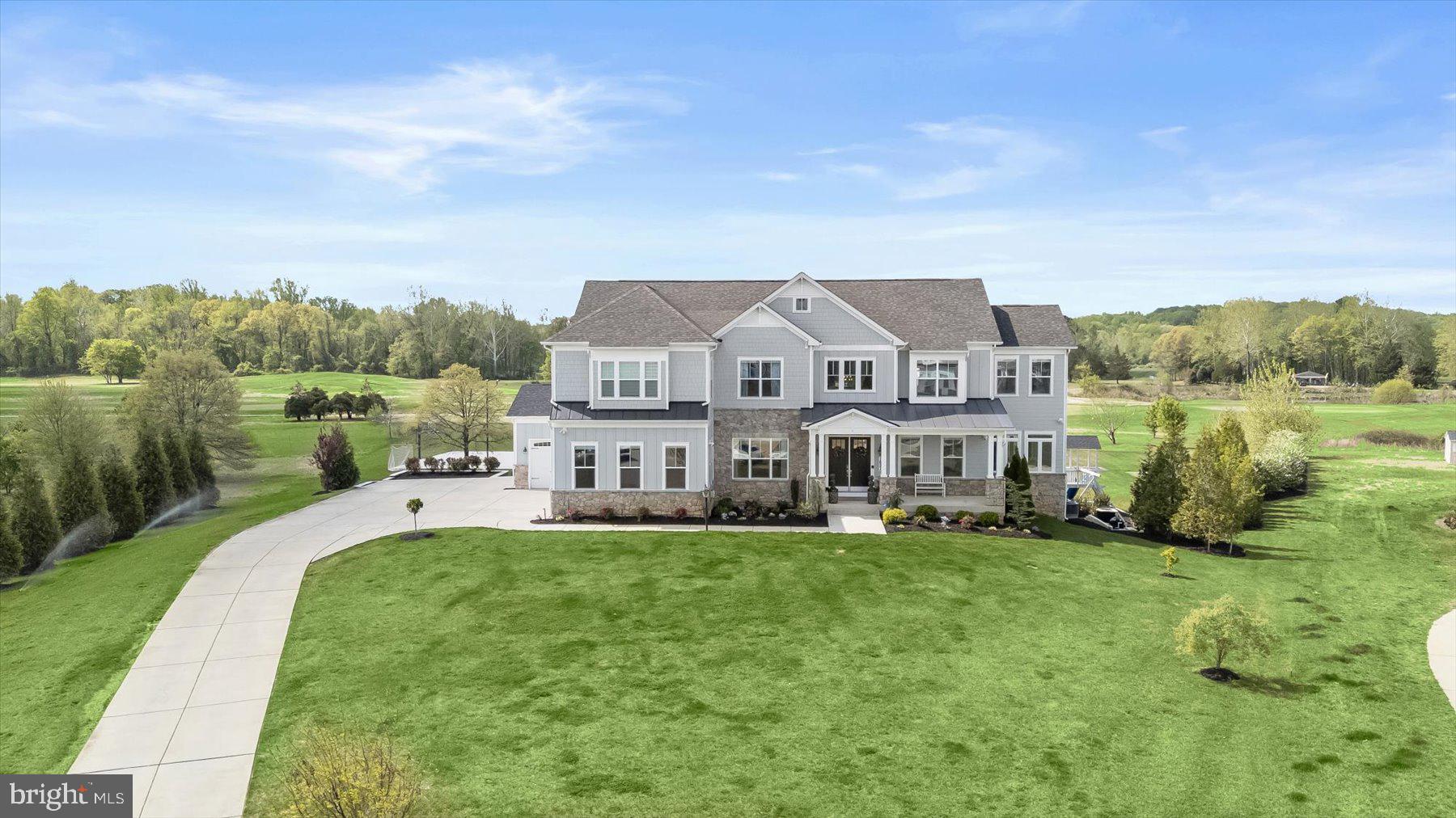 A Private Resort Estate Overlooking Renditions Golf Course, perfectly positioned on 1.67 acres in the coveted Southern Hills community of Davidsonville, this extraordinary estate represents a rare convergence of architectural sophistication, resort-caliber amenities, and an unrivaled golf course setting. Located on a premium cul-de-sac homesite—the highest premium lot originally designated by the community founder—this residence commands sweeping views of Hole #5 at Renditions Golf Course, a replica of Royal Birkdale #15.

From the moment you arrive, the home makes a striking impression with its HardiPlank and stone exterior, covered front porch, architectural shingle roof, and meticulously curated professional landscaping. A four-car garage and double solid wood entry doors further underscore the home’s scale and refinement.
Designed for seamless indoor-outdoor living, the rear of the home opens dramatically through multi-panel glass sliders to an expansive deck and wraparound outdoor living spaces. The backyard unfolds like a private resort, featuring a saltwater pool with a waterfall and automatic cover, a poolside spa, a covered entertaining pavilion with recessed lighting, a dedicated fire terrace, and a fully integrated sports court. Recreational luxury continues with an in-ground trampoline, custom climbing play structure, and a private putting green—all framed by lush, irrigated grounds.

Inside, the residence is equally compelling. A soaring 30-foot coffered great room serves as the architectural centerpiece, defined by a dramatic basket-weave feature wall, custom shiplap accents, and a wall of windows capturing panoramic backyard views. The chef’s kitchen is both refined and highly functional, showcasing bespoke cabinetry, quartz surfaces, professional-grade KitchenAid and GE Monogram appliances, a 48” commercial-style range, a wine cooler, and an oversized island designed for gathering and entertaining.

The upper level offers a serene primary suite retreat with cathedral ceilings, designer lighting, and a bespoke walk-in dressing room with custom built-ins and a center island. The spa-inspired bath features dual quartz vanities, a soaking tub, and an expansive walk-in shower with riverstone flooring. Additional ensuite bedrooms provide comfort and privacy, each thoughtfully appointed with modern finishes and refined detailing.

The lower level is an entertainment and wellness destination unto itself, offering a spacious recreation lounge, walk-out access to the backyard, fitness room, and a dedicated wellness suite complete with a cold plunge and infrared sauna. Additional guest accommodations and flexible living spaces ensure effortless hosting at any scale.

Smart home automation, whole-home audio, advanced security systems, and energy-efficient systems complete this exceptional offering—blending modern convenience with timeless luxury.