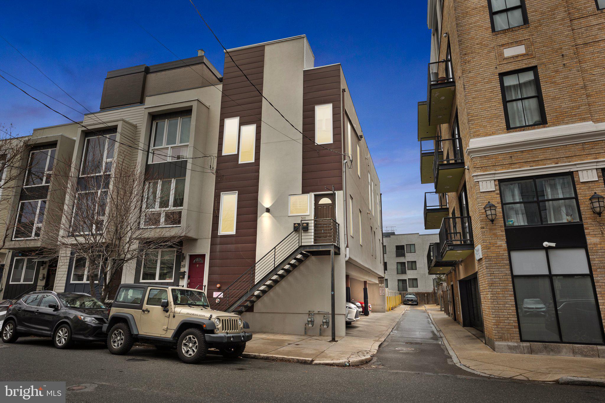 Welcome to 211 Green Street! This stunning 2 bedroom, 2 full bathroom second floor corner condo is in the heart of Northern Liberties with a private rooftop deck. This modern home features soaring 11-foot ceilings, an open floor plan, hardwood flooring throughout, and oversized windows, filling the space with natural light. The Chef's Kitchen boasts granite countertops, subway tiled backslash, shaker style walnut cabinets, stainless steel appliances, and a spacious island, perfect for entertaining. The primary bedroom features ample closet space and  an en-suite with  a subway tiled stall shower, while the second bedroom is ideal for guests or a home office. There is a second full bathroom with subway tiled stall shower as well. Walk up a staircase with access to a a private approximately 58'x18' rooftop deck perfect for hosting those summer nights. Also enjoy the convenience of in-unit laundry, recessed lighting, smart home features, and a private covered parking spot. Located just steps from trendy restaurants, cafes, shops, and public transit, this home offers the best of city living. Don’t miss out on this Northern Liberties gem!