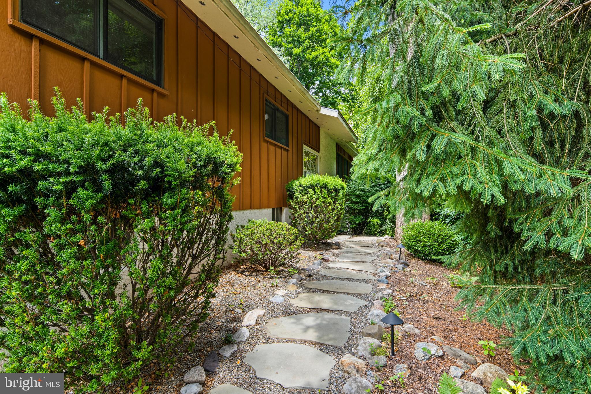 Welcome to a home that surprises at every turn. Set on just under one acre in the privacy of mature trees and greenery, this distinctive bi-level carries the warmth and clean lines of mid-century modern architecture   thoughtfully maintained and rich with personality.

A slate-floored entrance draws you upstairs to the heart of the home, where an eat-in kitchen with a skylight above the sink, warm maple cabinetry, a built-in wine rack, and a peninsula counter with seating sets the tone for easy everyday living. The kitchen opens naturally to the dining area and a sweeping great room anchored by an active wood-burning fireplace. Hardwood floors, crown molding, and oversized windows wrap the space in natural light and lush treetop views, with a glass slider leading out to an expansive deck where you can dine, lounge, and entertain amidst the canopy in complete privacy. Friends of the seller have long called this 'the home in the trees'   and one step outside, you'll understand exactly why.

Three bedrooms are positioned on the upper level, including a corner en suite primary with windows on two walls . The bathroom features a skylight & a sealed steam-shower   a genuine retreat. The second corner bedroom offers the same dual-exposure light. The third bedroom is currently used as a den with hardwood floors and a bold mid-century wall treatment. The hall bath is a standout, featuring a glass vessel sink, green top vanity, classic tile work, and a skylight that fills the space with natural light.

On the first floor, the home opens into a true recreation destination. A handsome wood bar with stools and lighted shelving, a pool table, and a dedicated wine cellar make this the kind of space people remember. The sunroom is wrapped in windows overlooking the grounds, it currently serves as an exercise room and features a working sauna and direct access to the lower patio. The fourth bedroom has two windows which add light & views of the surrounding greenery. It is flexible space that works equally well for guests, a home office, or both. A powder room and laundry complete this level, along with an attached two-car garage tucked neatly into the first floor footprint, a feature that sets this bi-level apart.

The fenced side yard provides open play space to this wooded sanctuary   a rare and lovely combination on 3/4+ acres of private, tree-filled grounds.

All of this in a location that simply works: served by the award-winning Tredyffrin-Easttown School District, walk to the Daylesford train station for an easy commute to Philadelphia, stroll to the Upper Main Line YMCA. Enjoy quick access to the dining, shopping, and conveniences of the Main Line.

This one lives larger than it looks   and feels like nowhere else.