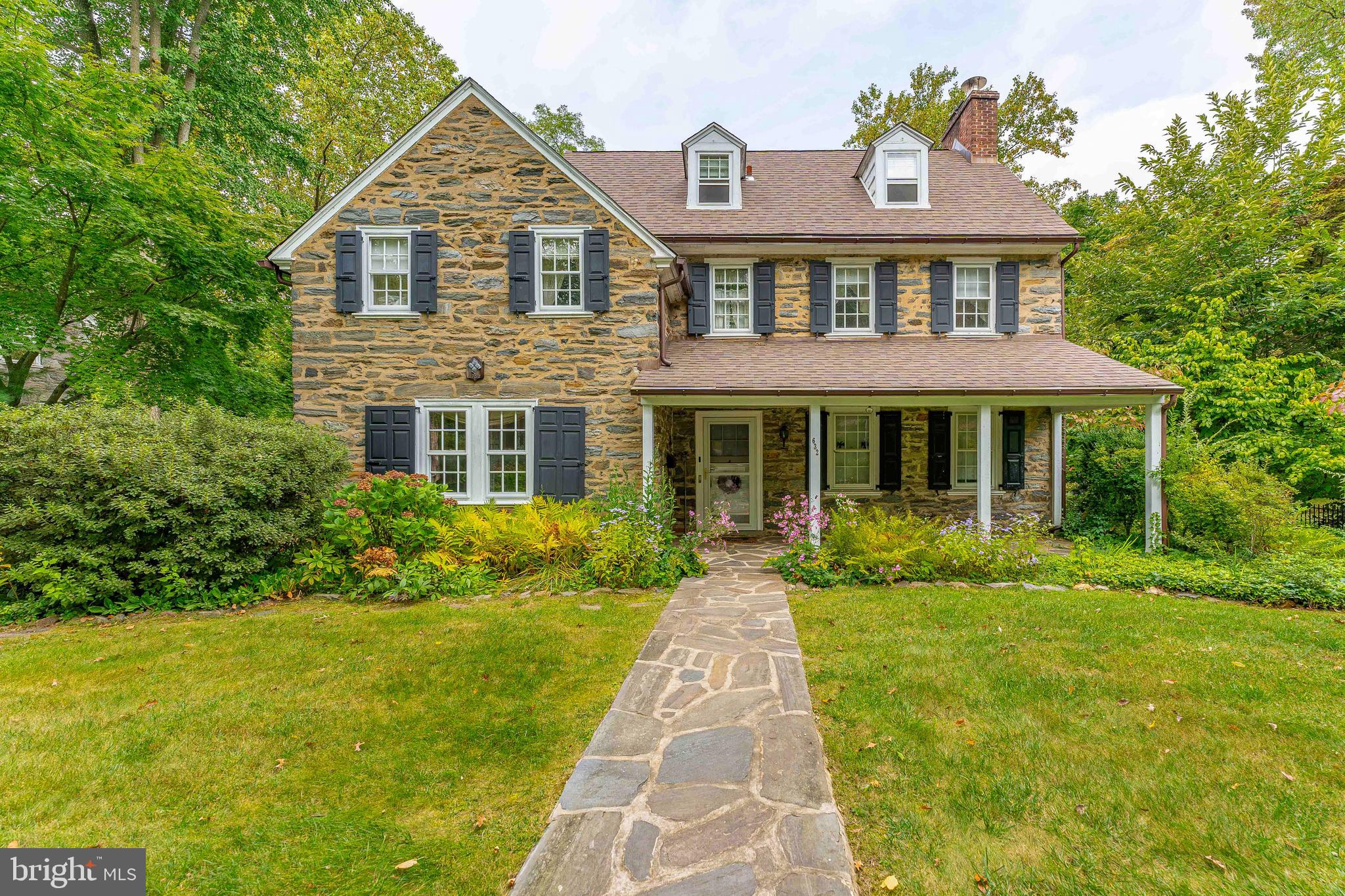 Welcome to 632 Winsford Road, a captivating 5-bedroom, 3.5-bath Colonial home nestled in the desirable community of Bryn Mawr. This enchanting three-story stone residence, complete with a charming front porch and a detached one-car garage, blends classic elegance with modern convenience. This home is perfect for the person wanting to add their own finishing touches to bring this home into all its glory! Upon entering, you’ll be greeted by original hardwood floors that flow gracefully throughout the home, showcasing their timeless beauty and craftsmanship. The inviting foyer welcomes you with a coat closet and a stylish powder room with vinyl flooring. To the right, the spacious living room features a classic wood-burning fireplace and opens onto a serene stone patio—perfect for outdoor relaxation. Across the foyer, double doors lead to an elegant dining room, enhanced by the soft glow of wall sconces. Beyond the dining area, the well-appointed butler’s pantry offers ample cabinetry, a convenient sink, and sleek granite countertops. The breakfast room adjacent to the kitchen provides easy access to the basement, patio, and a back staircase that intersects with the main staircase from the entry. The kitchen itself boasts beautiful granite countertops, tile flooring, and high-end stainless steel appliances, ideal for both everyday living and entertaining. On the second floor, the primary bedroom features built-in cabinetry and a second wood-burning fireplace, creating a cozy retreat. The ensuite bathroom includes a shower/tub combo, while a second full bathroom on this level offers a tub/shower combo. This floor also includes two additional bedrooms, perfect for children or guests. The top level is complete with a third full bathroom featuring a tub and two additional versatile bedrooms, which can serve as guest rooms or a home office. The lower level features an unfinished basement with laundry facilities and essential utilities. With ample private in the yard space for entertaining and a prime location close to local shopping and major routes, including I-76 and I-476, commuting is effortless. This home is ideally situated in a peaceful cul-de-sac, offering a quiet retreat while still being conveniently close to all that Bryn Mawr has to offer. Discover the unique charm and enduring quality of 632 Winsford Road—this exceptional home is a must-see!