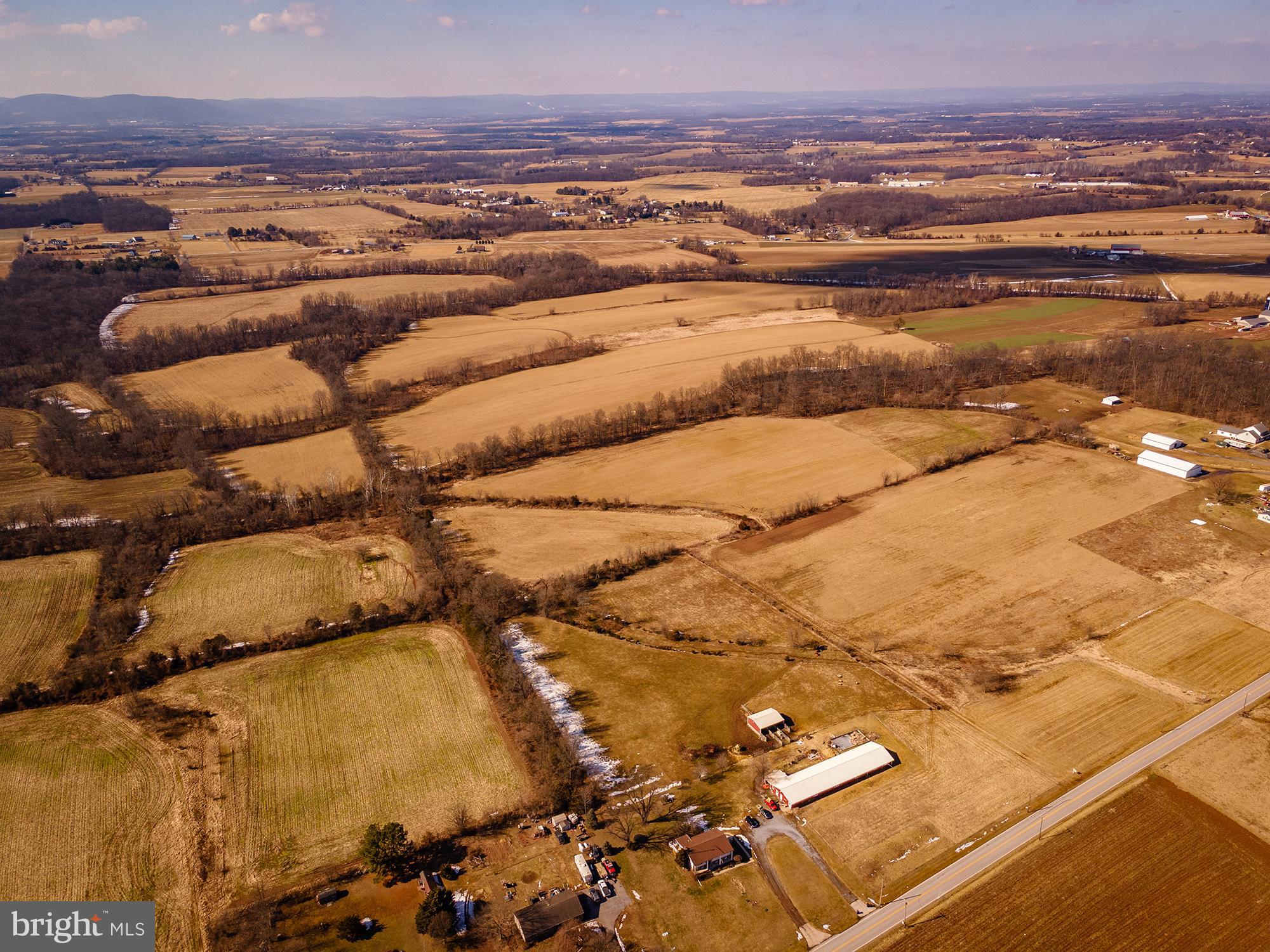 An unbelievable property in an incomparable setting. Crouse Mill Rd contains 108 acres of preserved, wonderfully flat land with some gentle hills, two deeded 80ft right-of-ways onto Crouse Mill Rd, and access through a farm driveway shared by 2300 Crouse Mill Rd. The property is eligible for continuation or reinstatement of the CREP program, and contains an original homesite that may be rebuilt or relocated with approval from Carroll County. There is also the existing right to build a tenant house within county guidelines. There are over 80 acres of tillable ground, currently being utilized for hay production (not in lease). There is a stream running through the Eastern side of the property. The location provides access within mere minutes to the center of Taneytown but offers COMPLETE seclusion and privacy with panoramic views. Feel as though you're in your own world and create an agricultural homestead, appropriate business pursuit, recreation property, or simply the home of your dreams on Crouse Mill Rd. This property is under an Agricultural Preservation Easement.