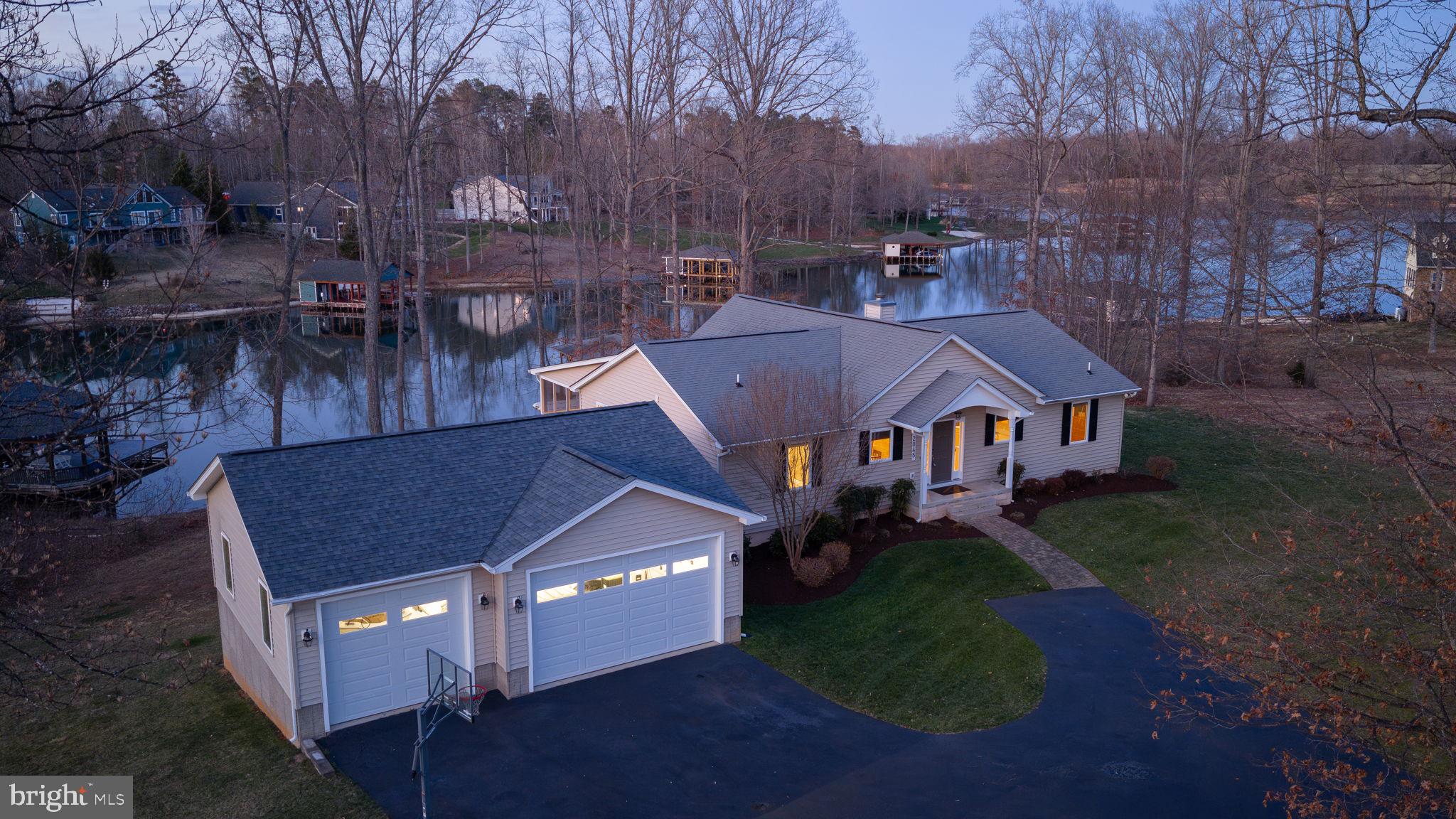 Relish in the unhurried moments of waterfront living at Lake Anna, Virginia in this classic waterfront retreat, located in the most desirable community on the private side of the lake, The Waters At Lake Anna — where days are longer, sunsets are better, and life moves at a slower, sweeter pace. With 190 feet of bulkheaded shoreline, deep water, a sandy beach, and your very own boathouse, this is the kind of place where summer memories are made—morning coffee on the dock, afternoons spent cruising or swimming, and evenings around the fire pit under the stars. Inside, with almost 3,800 square feet spread over two levels, this is everything you want in a true lake retreat—open, inviting, and built for gathering. The vaulted family room with a stone wood-burning fireplace sets the tone for cozy nights after a full day on the water, while walls of windows bring the lake views right inside. The open kitchen, complete with a center island and brand-new stainless steel appliances (2026), keeps everyone connected—whether you're cooking, hosting, or just hanging out. The lakeside primary suite offers the perfect escape with direct access to the screened porch—ideal for slow mornings with a cup of coffee and peaceful water views. With multiple bedrooms on both levels and a fully finished walkout basement featuring a second living area, rec space, kitchen/wet bar, and another lakeside suite, there’s room for everyone to stay, relax, and never want to leave. Step outside and it only gets better—a spacious composite deck (Trex Transcend Decking & Trex Signature Railing June 2019), fire pit for s’mores and stories, a sandy beach to play on, and a boathouse built for fun with two slips, electric lifts (including an 8,000 lb lift added in 2022), a sundeck, storage room, and two Wave Armour Apex 6 jet ski docks so you're always ready for a day on the water. Yes, even the kayaks, canoe and pedal boat all convey! Additional highlights include an oversized fully finished and insulated 3-car garage with a 24K BTU mini split, insulated doors, and WiFi-enabled jackshaft openers, plus a paved driveway and storage shed. All of this located in a golf cart–friendly, short-term rental–approved community that offers an in-ground pool, sandy beach, clubhouse, boat ramp, tennis, pickleball, basketball, and playground. Conveniently close to groceries, dining, coffee shops, and local favorites like Elk Creek County Store gas station and deli, Lake Anna Taphouse and The Yacht Club. This retreat is the perfect place to gather, unwind, and create lasting memories at the lake. See full list of improvements in MLS documents section and list of items that do not convey in the exclusions section. Main level Carrier HVAC system (2024).