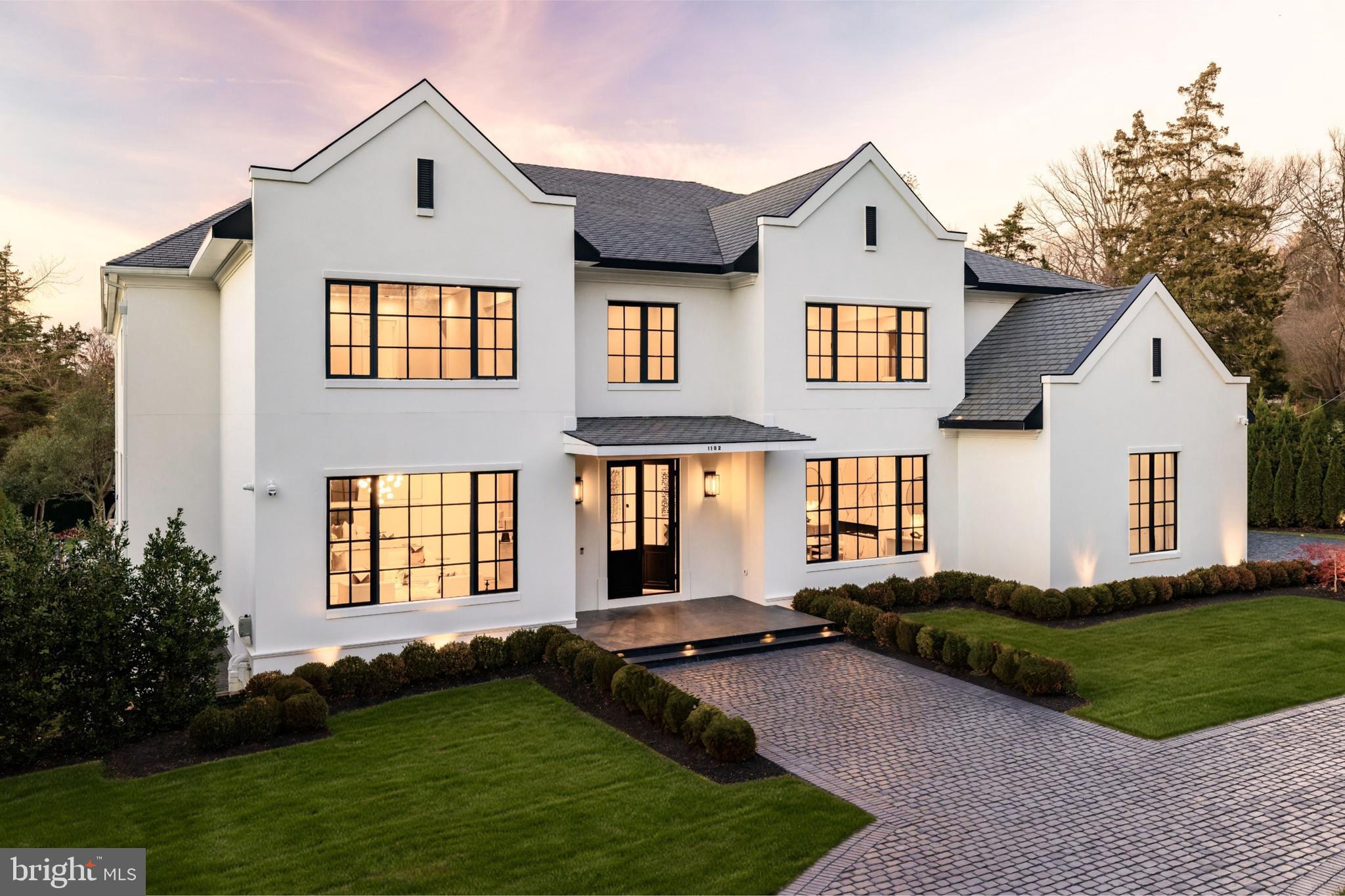 A new crown jewel in McLean, developed by Ambar, 1102 Chain Bridge Road commands attention in the prestigious Langley Farms enclave. A newly constructed triumph that fuses contemporary elegance with transitional château attributes, this estate is tailored for the digital age yet crafted with an artisanal touch seldom seen today. Spanning over 16,000 square feet, it is a showcase of forward-thinking design and enduring craftsmanship.

Set on a rare 0.8-acre lot, the approach reveals a gracious cobblestone motor court enveloped by sleek, mature privacy landscaping. Beyond grand double doors, a herringbone-floored foyer offers clear sightlines through the home’s depth, introducing 12-foot ceilings, solid walnut floating stairs, and 10-foot custom wood doors with Emtek hardware. These are testaments to the home's exacting attention to detail. Wide-plank engineered floors and recessed crown uplighting provide a refined warmth throughout.

Designed equally for grand entertaining and everyday comfort, the main level flows effortlessly between formal and informal spaces. At its center is an aspirational chef’s kitchen: dual waterfall islands clad in Spanish marble, Italian composite cabinetry, a vintage Viking 8-burner range, and a full Miele suite. A separate, fully enclosed spice kitchen with its own Miele appliances adds further versatility.

Three floor-to-ceiling collapsible glass walls open to reveal true indoor/outdoor resort living. A covered patio offers ideal al fresco dining, while the marble terrace introduces a stunning heated lap pool with spa, waterfall, hidden drainage, and an automatic cover. A private guest suite with direct patio access and panoramic pool views is quietly tucked away on the main level.

Upstairs, the primary suite is a sanctuary of serenity. Beyond a long corridor and double doors lies a generous sleeping room and private sitting area, divided by a custom linear fireplace. Two sets of French doors open to a private terrace with sweeping views. The spa-inspired bath is clad in Dekton and features radiant heated floors, eight shower heads, a Kallista soaking tub, dual water closets, and separate his-and-hers dressing rooms outfitted in custom Italian cabinetry with illuminated glass displays and center islands.

Additional upper-level bedrooms are grand in scale, each with tray ceilings, custom walk-in closets, and designer en suite baths. A convertible nursery offers discreet access to the primary suite. A spacious laundry room with dual islands and full-height cabinetry completes the upper level.

The lower level is designed for elevated recreation and wellness. Amenities include a professional home cinema, a full bar with a Dekton island, and a fireside lounge wrapped in Porcelanosa tile. A secure safe room with 36-inch concrete walls and a Fort Knox vault door offers peace of mind. The wellness wing is a true retreat, with a steam shower, commercial sauna, fitness studio, and walk-up access to the outdoors.

Engineered for longevity and performance, the home features a commercial-grade elevator, 600-amp electrical service, copper plumbing, five Carrier HVAC zones, and dual 80-gallon water heaters. Infrastructure is in place for a full-house gas generator. A central security suite monitors the 8-camera system, while a sophisticated URC system provides integrated control of Lutron lighting and concealed surround sound via in-wall iPads and smartphones.

The 54-foot four-car garage with soaring ceilings is a dream for the automobile enthusiast. Meticulous landscaping and artful hardscaping unify the estate’s bold presence with its refined aesthetic. With commanding architecture and an unrivaled array of modern amenities, 1102 Chain Bridge Road stands as one of the Capital Region’s most exceptional residential offerings.