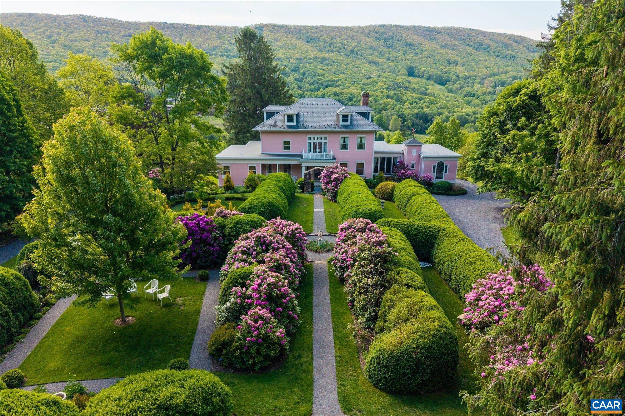 Perched atop scenic Routier Hill with commanding views of the valley, Roseloe Manor is a timeless jewel in the heart of Hot Springs, Virginia. Built in 1905 and expanded in 1918, this stately residence was once the centerpiece of a 126-acre estate and a wartime haven of a Baron and Baroness. Today, Roseloe Manor rests on 12 enchanting acres, graced by a formal boxwood and rhododendron garden that reflect its storied past. A comprehensive restoration has seamlessly blended historic charm with modern comfort, preserving exquisite details like a dramatic 9-foot stained glass window, carved European mantels, and a sweeping grand staircase. Gracious entertaining spaces include a formal dining room for 16, and a living room with expansive windows that showcase sweeping mountain views. A distinguished covered front porch welcomes guests with classic charm while inside, ornate fireplaces and Victorian craftsmanship define the refined living areas. All bedrooms are upstairs, including a serene primary suite with dressing room and steam shower bath. Just five minutes from the renowned Omni Homestead & Garth Newel Music Center, Roseloe Manor is a rare and exceptional offering nestled in the idyllic natural landscape of Bath County Virginia.,Granite Counter,White Cabinets,Wood Cabinets,Fireplace in Living Room,Fireplace in Study/Library
