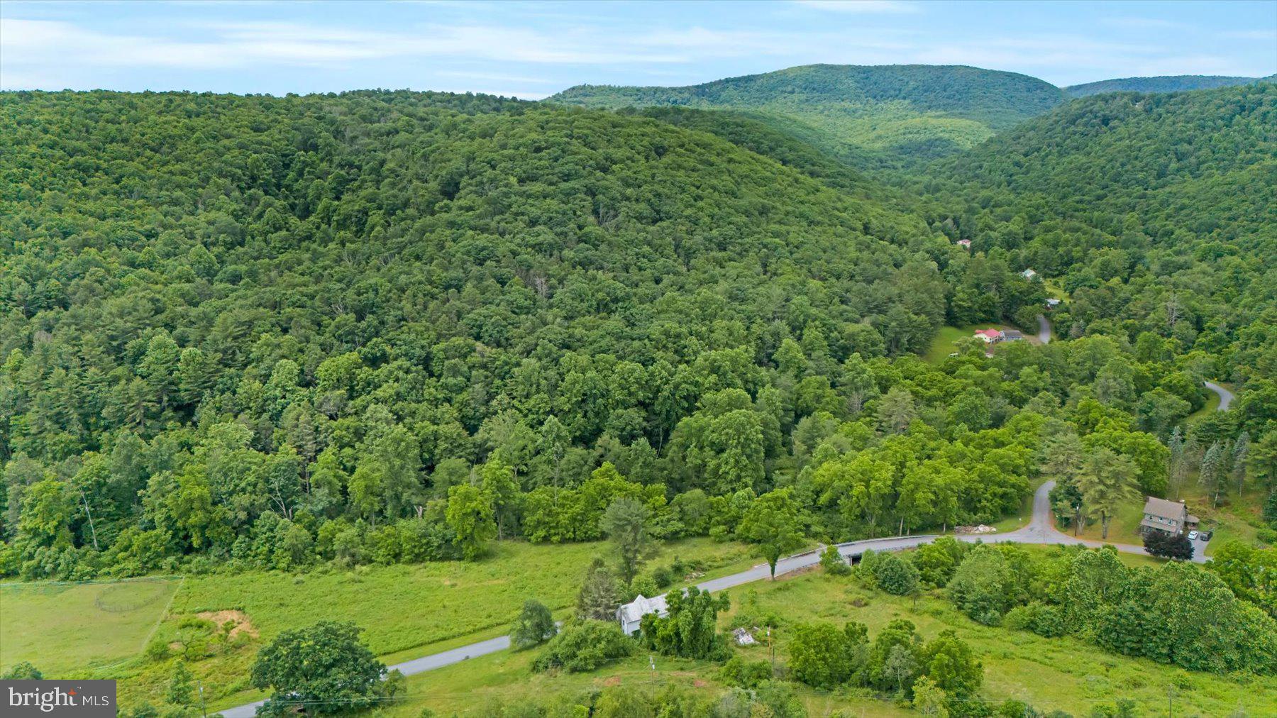 Contractors, investors, house flippers, buyers able to get a renovation loan - here is your chance to own 23 acres of land with a stream running through it, an abundance of wild black raspberries bushes, a private and peaceful setting with mountain views and a house that you can finish renovating at the fraction of the cost you would pay if the house was already completed - as the price per square foot that the house is listed at is well below the average for the area.  Bringing the land in at around $7200 an acre.   The price also takes into consideration that it will need a septic system.  A perc test has been completed.   The water is supplied by a spring and there are 2 wells on the property.  The house was gutted and new drywall, wiring with 200 amp panel as well as the plumbing was updated.  Baseboard heating is installed.  The unfinished 3rd floor attic space was drywalled and renovations were started to have a master suite with bedroom, walk in closet and full bath.  Kitchen and bathrooms will need completed.  Flooring will need completed.  It will most likely need a new roof.  Price reflects incomplete remodel.   House is being sold “as is”.    Only serious, pre-approved buyers are permitted to schedule a tour per the seller.