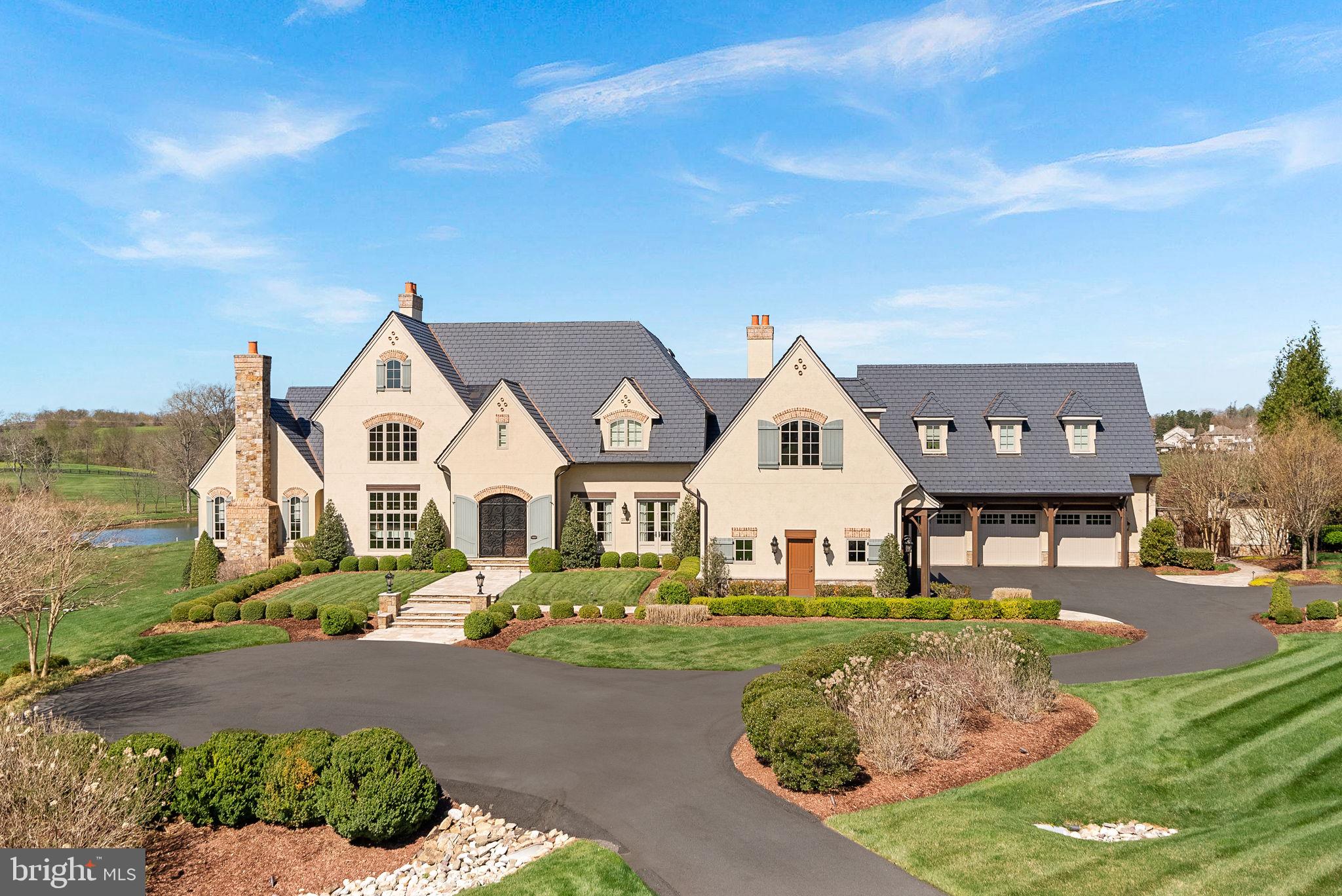 Imagine ending your day watching the most beautiful Loudoun County sunsets over the 7th hole of a Jack Nicklaus Signature Course—right from your private veranda! At Chateau Belvedere, a one-of-a-kind estate situated on 3 acres inside Leesburg’s exclusive Creighton Farms, that vision becomes your everyday reality. The home was designed and custom built by the renowned Galileo Signature, this tri-level residence is an architectural homage to English and French countryside manors, blending timeless elegance with modern craftsmanship over 14,000 sq ft of carefully curated interiors.

From the moment you approach the grand drive, every detail impresses. Meticulous landscaping leads you towards the grand entrance.  Inside, a floating curved staircase sweeps through the soaring foyer, illuminated by towering windows and anchored by curved walls that give the layout a fluid, gallery-like sophistication.

A refined formal living room with bespoke cabinetry hosts intimate conversations, while beamed ceilings crown the family alcove with its wet bar and French doors leading out to the heart of the home: The Belvedere—an open air veranda commanding the best panoramic golf course views in the neighborhood.

Culinary dreams come alive in a kitchen designed for both performance and beauty, complete with professional-grade appliances, a central prep island, and walk-in pantry. The adjacent breakfast nook feels like a European café, while the adjoining sunroom and heated patio each invite year-round entertaining. Your main-level primary wing offers a private luxury retreat complete with tray ceilings, fireplace, and a spa-inspired ensuite.

Upstairs, all four secondary suites have accompanying baths and ample storage.  Flexible living zones and a bonus kitchenette make this floor ideal for hosting or extended stays. 

A convenient elevator links all three levels, including a basement that rivals any resort: wine cellar with tasting room, exercise room, full size stage for concerts or recitals, cinema-style theater room, and the cozy fireside recreational area.

Step outside to enjoy the sweeping golf course views and the infinity edge pool with spa and fountain.   The outdoor spaces are thoroughly appointed, offering a full kitchen, exterior shower, and multiple conversation areas provide the perfect setting for all events large and small.  

Rounding out the home is a 3 car garage and an additional detached 2 car garage complete with 2 full size vehicle lifts.  Car enthusiasts can easily store  up to 7 vehicles indoors.  

The home also has a 1 year old Synthetic Slate Roof, Newer Geothermal Units and Commercial Whole House Generator.  

All of this and conveniently located near James Monroe Highway 15, Leesburg Airport, Washington Dulles Airport, and the Dulles Toll Road.   Chateau Belvedere isn’t just a home—it’s a world unto itself. 

Come experience the intersection of luxury, leisure, and legacy!