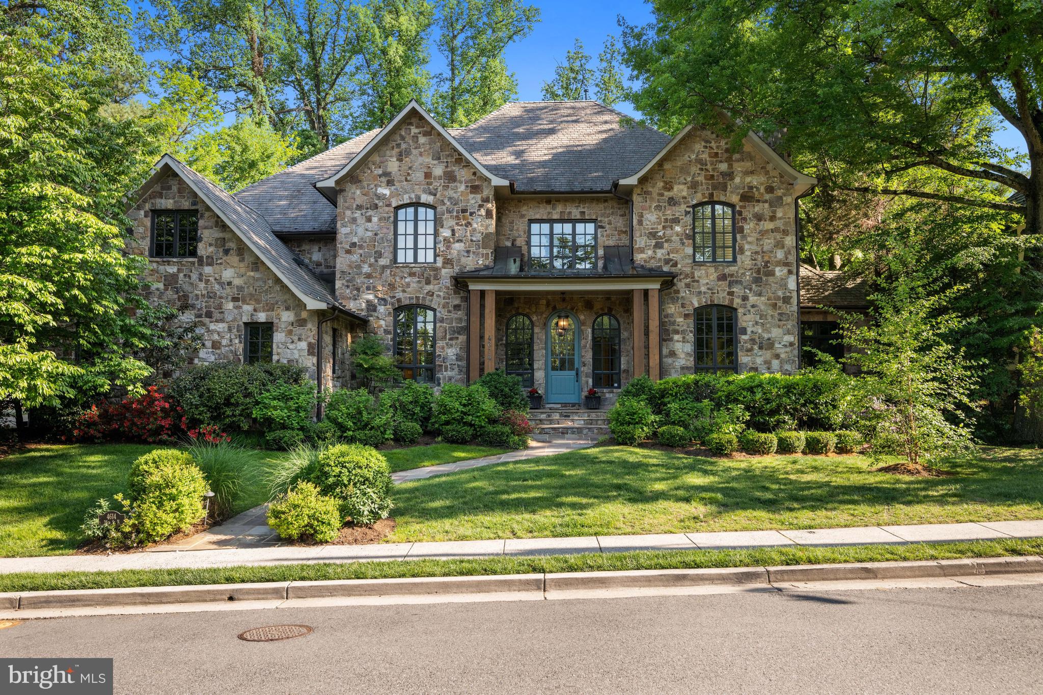 There is a particular kind of home that reveals itself slowly…where the quality is felt before it is seen, and where the weight of fine craftsmanship speaks to something enduringly substantial. Set on 0.69 acres, among the most substantial lots Country Club Hills has to offer, and thoughtfully crafted by the owner of BCN Homes as his own personal family residence, this extraordinary English Manor style estate with resort-like rear grounds represents the rarest of opportunities and is now offered to the market for the first time.

The estate-like setting is immediately compelling. Mature landscaping and towering trees create a remarkable sense of privacy and space rarely available in such a close-in location. The home itself commands attention with its timeless architecture, elegant symmetry, and a presence that feels substantial without excess.

The outdoor living experience is truly exceptional. Sliding glass doors across the rear of the home open to expansive terraces surrounding the 40x20 swimming pool and cabana. Designed for year-round entertaining, the cabana includes an outdoor kitchen with built-in grill, sink, icemaker and beverage refrigerator, while a dramatic stone fireplace creates an unforgettable centerpiece for gatherings. A private sport court adds yet another rare amenity to this remarkable property.

Inside, 11-foot ceilings and graciously scaled rooms lend an unhurried grandeur throughout, providing an extraordinary sense of openness and natural light across all levels. Oversized windows frame views of the surrounding grounds at every turn, while substantial millwork, wide-plank flooring, and refined architectural detailing lend warmth and sophistication to the home's expansive scale. Spanning nearly 9,850 finished square feet across four thoughtfully realized levels, the residence offers seven bedrooms and nine baths, each space scaled for the way refined families truly live. This is not volume for its own sake. It is space with intention.

A gracious foyer anchors the main level, opening to a formal living room with a masonry fireplace, a beautifully proportioned dining room, and a private library that offers the quiet gravitas every principal residence deserves. The heart of the home is the expansive kitchen, appointed with an elegant butler's pantry, a walk-in pantry, and a sun-lit breakfast alcove, opening directly to the rear grounds. The adjacent family room, with its handsome stone fireplace, flows effortlessly to the extraordinary outdoor environment beyond. A rear foyer provides a generous mud room, pool bath, service entry, three-car garage, and rear stairs to both the lower and upper levels, all designed with the full complexity of family life in mind.

The second level, with nine-foot ceilings, is anchored by a serene primary suite with a luxury marble bath. A vaulted upper family room provides an intimate gathering space away from the main floor, while three additional bedrooms, each of generous proportion, are served by well-appointed baths. A dedicated laundry room of exceptional size ensures that every practical consideration has been met with the same care as the architectural ones.

The third level offers a private retreat of its own: a bedroom, a generous bonus room, a full bath, and ample storage, perfectly suited as a guest suite, an au pair accommodation, or a secluded creative space. The lower level extends the home's entertaining capacity with a large game room, a recreation room with a masonry fireplace, a dedicated exercise room, a theater, a wine cellar, and an additional bedroom and full bath, ensuring that every member of the household, and every guest, has a world entirely their own.

Long regarded as one of the most prestigious residential enclaves in the greater Washington area,  this address represents North Arlington at its most desirable. Opportunities of this caliber rarely present themselves — and almost never with this level of scale and permanence.