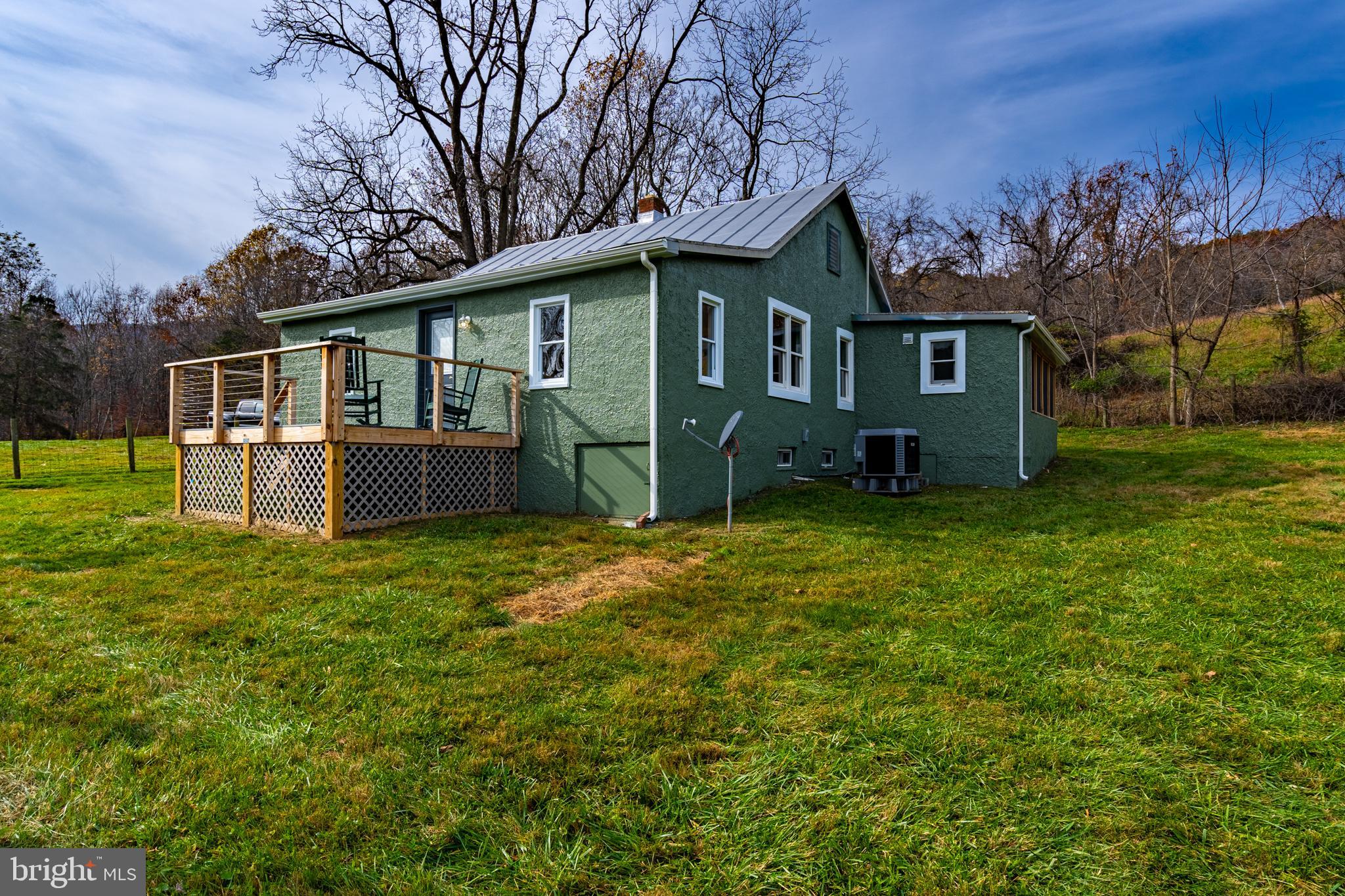 Recently renovated and flooded with natural light, this charming circa 1940's Bungalow is just waiting for you to make it your own. Situated on almost 6 acres, the home sits on a mostly level lot with rustic stone walls, a hand-built barn, and easy access to a freshwater stream which flows along the edge of the property. The property is situated on scenic Gooney Manor Loop, surrounded by Shenandoah National Park on three sides, and is just outside the historic village of Browntown.
The home has just undergone a full renovation. The interior and exterior have just been repainted, the original hardwood floors have been sanded and finished, and  modern HVAC and gutters have just been installed. The spacious kitchen boasts brand-new flooring, cabinets, appliances, and tile; while the bathroom has been expanded, re-finished, and updated as well. There is also a separate laundry room.
There are two large bedrooms, a living room, and a dining room divided by original craftsman pocket doors. There are two additional “flex” rooms with gorgeous exposure in three directions, perfect for a nursery, home office and/or studio - there is also easy access for plumbing to convert one to a second bathroom. The Bungalow’s flexible layout allows for maximum freedom to make the space work for you. 
The property features two outdoor sitting, BBQ and entertainment spaces where you can enjoy the fresh air and natural beauty of the countryside. Off the kitchen is a full, fan-cooled screen porch that overlooks a fenced-in garden - perfect for growing veggies or keeping animals. On the east side of the bungalow is a brand new raised deck that offers acres of unobstructed natural views and the calming sounds of the nearby stream. The classic red barn is ideal for small livestock if desired - or could be converted to a workshop or art studio. This property has something for everyone. The flexible layout can accommodate growing families, and the office space and Starlink high-speed internet access allow for seamless transition to a work-from-home setup. The expansive property allows for pets, gardening and other recreational activities, or just some good old-fashioned privacy. Don't miss out on this one!  List of updates is in the documents.