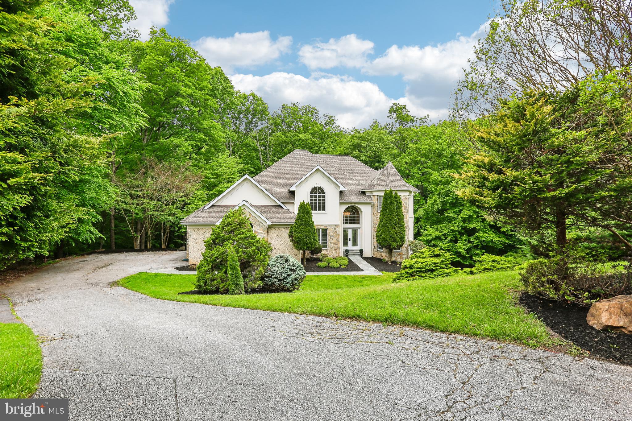 Situated on a private lot, this classic colonial by J. Paul Builders offers a spacious and thoughtfully designed layout with 5 bedrooms, 4 full bathrooms, and 1 half bathroom. The main level welcomes you with a bright, open two-story foyer featuring a double-entry staircase. Natural hardwood flooring extends throughout the main living areas. The open concept design creates seamless flow across the entire main level, making it ideal for both everyday living and entertaining. A spacious family room and a living room with a fireplace connect effortlessly to the dining area. The kitchen is designed for both functionality and hosting, featuring two wall ovens, and ample space for gatherings. A nearby half bathroom adds convenience. A main-level bedroom or office with an attached full bathroom and its own private entrance from the driveway offers flexible use. Perfect for guests, a live-in nanny, or a private workspace. A laundry room is also located on the main level. Upstairs, the home features a large primary suite with an ensuite bathroom and two walk-in closets. Three additional bedrooms and two full bathrooms provide generous accommodations, along with a versatile bonus room that can be adapted to a variety of needs. Each secondary bedroom offers direct access to a bathroom, enhancing comfort and privacy, with one bathroom also accessible from the hallway. Additional features include a dual-zoned heating and cooling system for enhanced comfort and efficiency. This home combines classic craftsmanship with a highly functional layout, offering both privacy and convenience in a sought-after location.