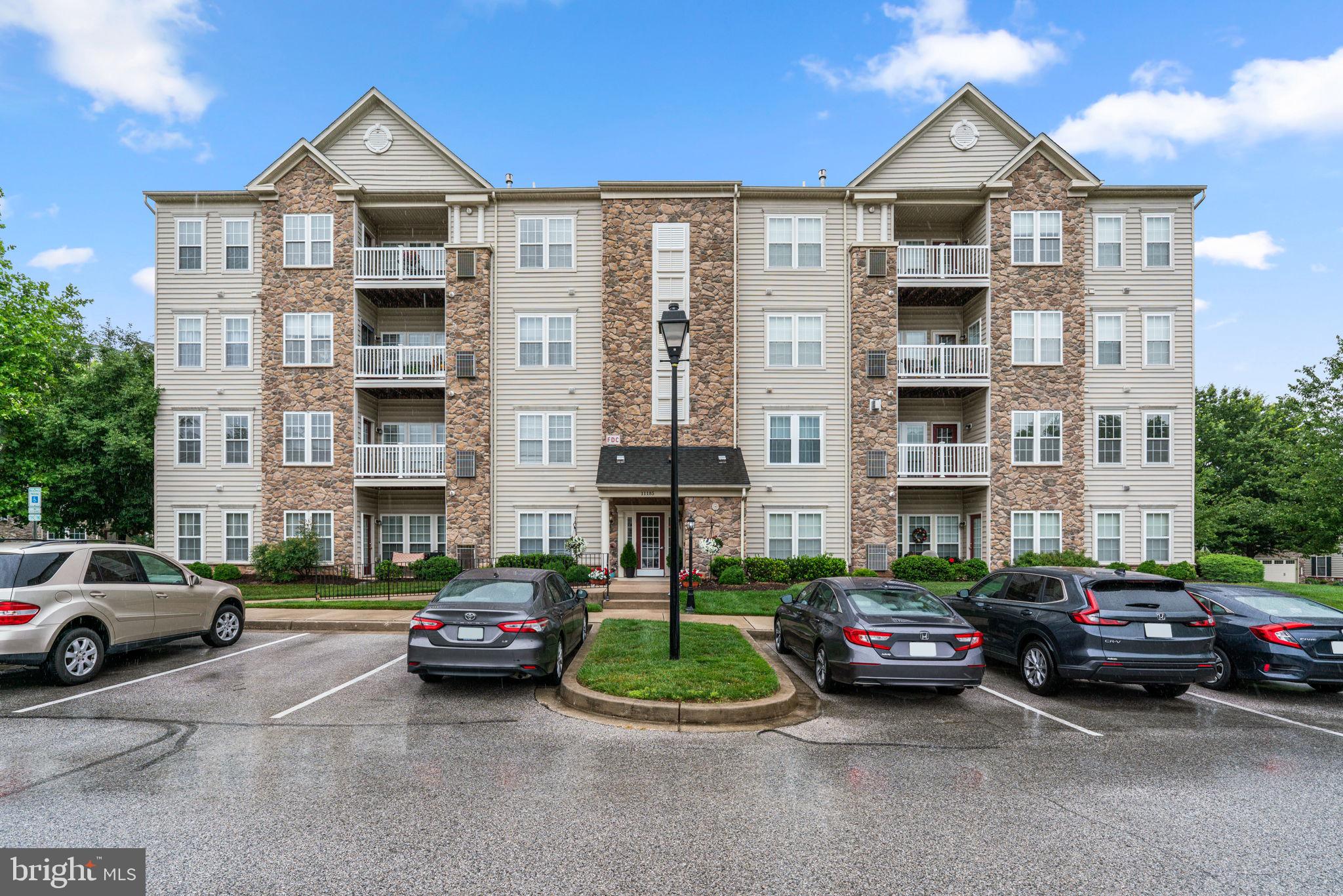 Beautifully maintained second-floor traditional-style condominium residence offering 2 bedrooms, 2 full bathrooms, and 1,357 finished square feet in the desirable 55+ community of Courtyards at Waverly Woods East. Convenient elevator access and a thoughtfully designed layout make this home ideal for comfortable, low-maintenance living. // Step inside the bright and inviting interior where an open-concept layout creates a comfortable setting for everyday living and entertaining. The combined living and dining room is enhanced by plush carpeting, a classic chandelier, elegant chair railing, and abundant natural light streaming in from the covered balcony. A cozy gas fireplace serves as a warm focal point, while a breakfast bar and pass-through window seamlessly connect the space to the kitchen. // The well-appointed kitchen features ample wood cabinetry, generous countertop space, sleek white appliances, a pantry, and a conveniently located laundry closet. Just off the living room, French doors open to a versatile den, ideal for a home office, library, or hobby room. // The spacious owner's suite offers a peaceful retreat with a ceiling fan, two closets, and a private ensuite bath featuring a dual-sink vanity. A generously sized secondary bedroom provides dual-entry access to an additional full bathroom, creating convenience for guests. // Enjoy morning coffee or unwind in the evening on the covered balcony overlooking the community. // Residents of Courtyards at Waverly Woods East enjoy access to exceptional amenities, including an outdoor pool, tennis courts, and beautifully maintained common grounds. // Select photos are virtually staged for illustrative purposes only.