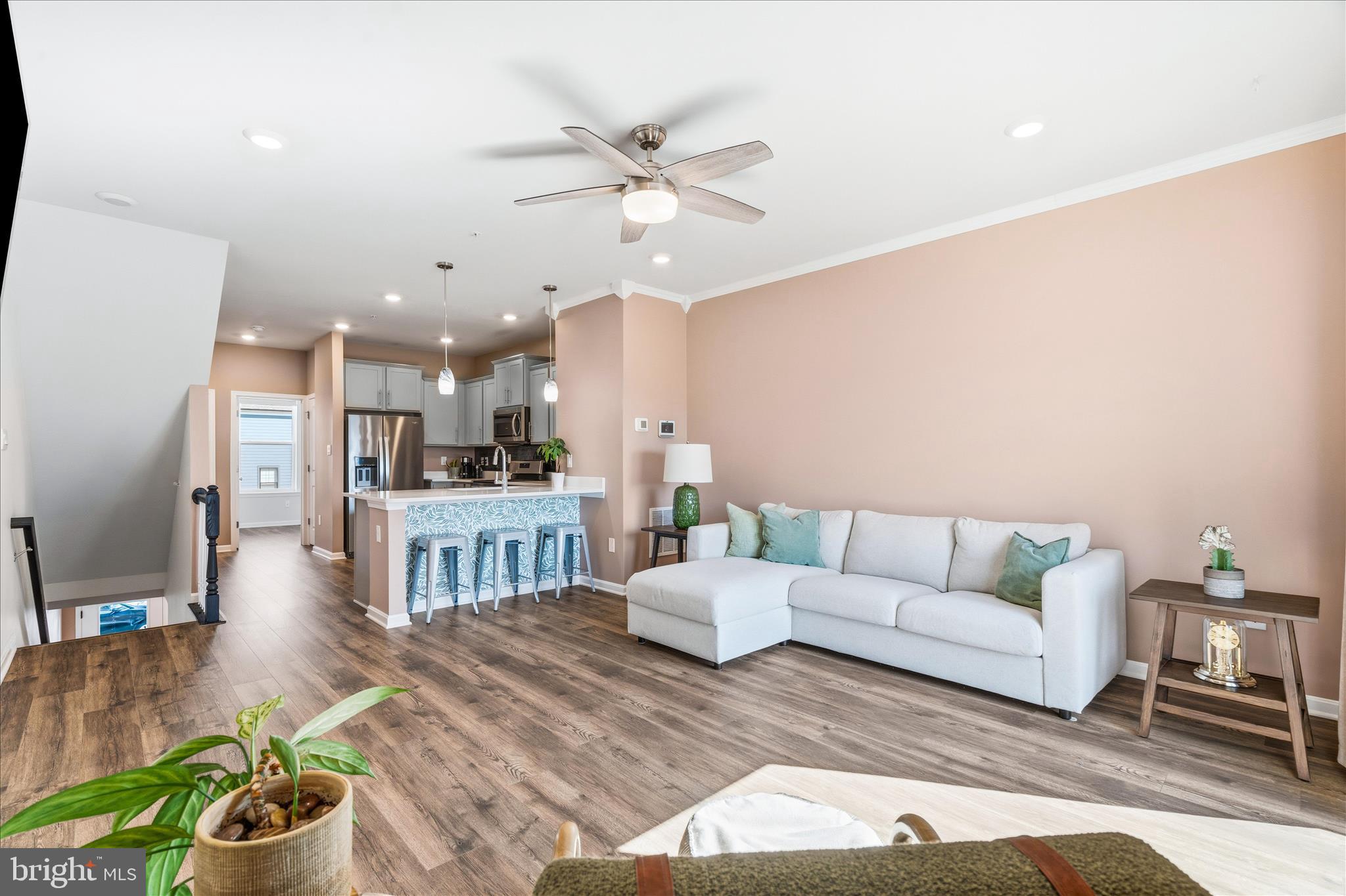 Welcome to this beautifully appointed 3-year-young townhome, walkable to vibrant Downtown Frederick! Offering 4 bedrooms and 4 full bathrooms, this thoughtfully designed home stands out with a rare and highly desirable layout - EACH BEDROOM FEATURES ITS OWN FULL BATHROOM, EVERY LEVEL OF THE HOME INCLUDES A BEDROOM, providing exceptional flexibility and privacy for guests, family, or a home office. Upon entering the foyer you have a generous amount of space for a drop zone and greeting guests.  You'll also find a bedroom with a walk-in closet and en suite bath.  Upstairs the main living space invites you in with an open-concept layout, 9 ft ceilings, LVP flooring throughout, a bright living/dining area and a modern kitchen equipped with stainless steel appliances and quartz countertops. Then step outside to the deck for easy indoor-outdoor living. This level also includes a bedroom and full bathroom. The upper level includes a convenient laundry area and two more bedrooms, including the spacious primary suite featuring a large walk-in closet and full bath with dual vanities, while the secondary bedroom also offers its own en suite bath.  Additional highlights include a garage for parking and storage, along with a community full of amenities—clubhouse with fitness room, pool, playgrounds and a dog park! ***Assumable mortgage at 5.75% for qualified VA buyers.***
