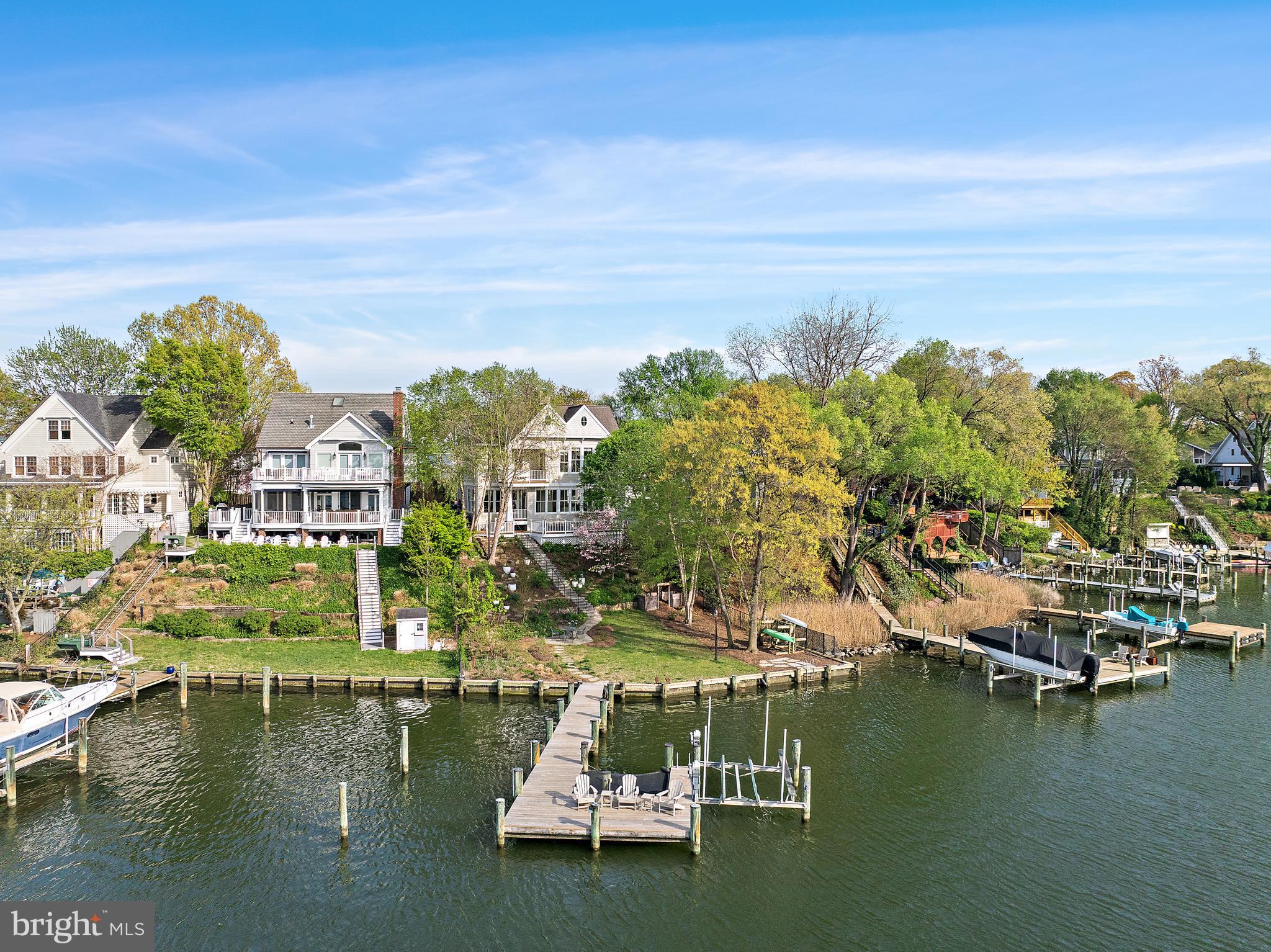 A stunning waterfront residence on Spa Creek, The Spa Creek House is a custom home designed by Alt Breeding Schwarz Architects with a landscape plan by Forested Creative Ecology. Set on a prominent .165-acre site once part of a historic city park, this property offers approximately 4,250 square feet of finished living space thoughtfully designed to capture sweeping creek views.
The exterior showcases cedar shake siding, Azek trim, Marvin aluminum-clad windows, a 30-year architectural shingle roof, and a 2-car garage with designer doors. Modern amenities include public water and sewer, natural gas, electric car charger, whole-house surge protection, owned solar panels, generator, and a robust 400-amp electrical service.
Enjoy approximately 76 feet of bulkheaded waterfront with a resurfaced pier offering 6+ feet of water depth, a 10,000-pound boat lift, electric and plumbing at the dock, kayak storage, and lounge netting. A stone wall built from original Main Street cobblestones adds historic character at the water’s edge.
Inside, the home features a dramatic two-story entry, white oak hardwood floors, custom millwork, three gas fireplaces, built-ins, and an open layout ideal for both daily living and entertaining. The gourmet kitchen is equipped with Wolf, Sub-Zero, and KitchenAid appliances, granite countertops, and custom Mouser cabinetry. Four/five bedrooms and four baths include a main-level bedroom, an expansive primary suite with spa-like bath, upper-level laundry, and a finished lower level with bedroom/office, full bath, library shelving, and custom bar.
Outdoor living is enhanced by Massaranduba decking, a bluestone patio overlooking Spa Creek, and a low-maintenance permaculture landscape installed in 2023 featuring fruit trees, berries, herbs, and native plantings. Additional highlights include a fenced yard, irrigation system, exterior lighting, security system, and private driveway with pavers.
A rare opportunity to own a distinctive, energy-efficient waterfront home just minutes from downtown Annapolis, offering deep water access, refined craftsmanship, and unparalleled Eastport waterfront living.