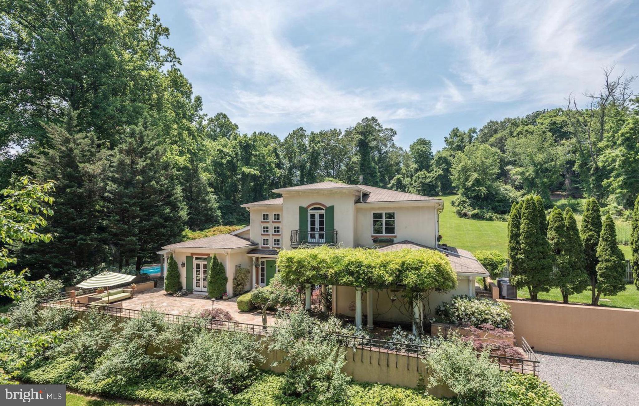 Welcome to a one-of-a-kind Tuscan-inspired estate nestled on a private 5-acre retreat in the heart of McLean.  This custom-built home, offering over 6600 sq/ft of living, seamlessly blends classic European charm with modern luxury, offering an unparalleled lifestyle of elegance, comfort, and seclusion

As you drive through the private, gated entrance, a long picturesque driveway winds through lush landscaping, setting the tone for this exceptional property. The gracious entrance welcomes you with a striking green door, high ceilings, and abundant natural light. Inside, the great room is a showstopper, featuring sky-high ceilings and a stately marble fireplace that creates a warm yet sophisticated ambiance. French doors throughout the home invite natural light and provide seamless access to the stunning outdoor spaces.

The gourmet kitchen is a chef’s dream, boasting handcrafted wood cabinetry, granite countertops, high-end appliances, and a large center island perfect for entertaining. A butler’s pantry with elegant glass cabinetry and a beverage fridge ensures convenience and style, while the formal dining room, adorned with a dramatic chandelier and natural wood finishes, opens to serene outdoor terraces, making it the perfect setting for gatherings.

The main-level primary suite is a private sanctuary, complete with a spa-like en-suite bath, a custom walk-in closet, and direct access to a private terrace. Additional bedrooms feature elegant chandeliers and access to balconies with breathtaking views of the lush surroundings. The lower level offers a cozy a billiards table, recreation room and a fifth bedroom perfect for leisure. 

Stepping outside, you’ll find a resort-style oasis designed for relaxation and enjoyment. The estate boasts an expansive outdoor pool surrounded by an elegant stone patio and wisteria-covered pergolas, offering a tranquil and picturesque setting. A sun-drenched terrace provides the perfect backdrop for al fresco dining, while the beautifully maintained pickleball court cater to an active lifestyle. Meandering pathways lead to peaceful garden spaces, inviting moments of serenity and reflection.

This breathtaking villa is ideally situated in a prestigious enclave of McLean, offering the ultimate privacy while maintaining proximity to the area’s finest shopping, dining, and cultural experiences. Just minutes from Tysons Corner, Great Falls Park, and major commuting routes to Washington, D.C., this home provides a perfect balance of seclusion and accessibility. More than just a residence, this estate is a sanctuary that embodies elegance and resort-style living.Don’t miss this rare opportunity to own a slice of Tuscany in Northern Virginia.