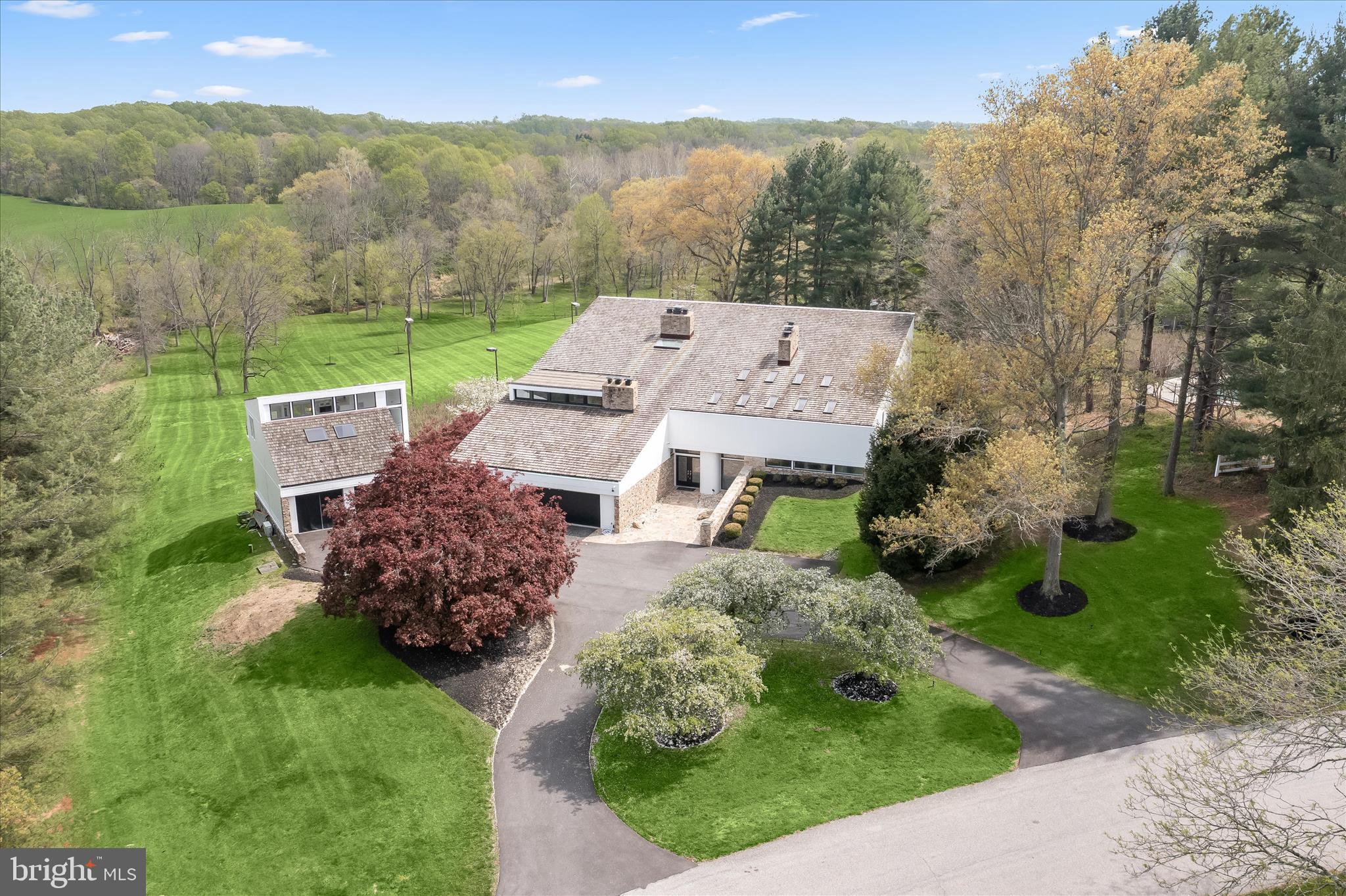 Extraordinary estate living on 6 private acres in the vibrant community; Farside. This one-of-a-kind contemporary in Ellicott City offers over 10,500 finished square feet of resort-style amenities, extensive 2026 renovations, and breathtaking valley views. With 6 bedrooms, 8 full baths, 2 half baths, and three fully equipped kitchens, this residence is designed for luxurious everyday living, multigenerational flexibility, and grand-scale entertaining. A dramatic two-story foyer welcomes you with marble and hardwood floors, a striking stone wall, and a cascading chandelier. The main level showcases expansive living and dining spaces with 6 fireplaces, a beautifully updated kitchen with new appliances, commanding center island, garden window, and breakfast area opening to a wrap-around deck. The adjoining family room features new windows and Anderson slider doors overlooking the indoor heated pool. A main-level en-suite primary bedroom with private deck and fully renovated bath offers ideal convenience.  The upper-level primary suite is a luxury retreat featuring new hardwood floors, loft, sitting room with fireplace, a fully renovated spa-inspired bath with freestanding tub, wellness room, dual walk-in closets, skylights, and private deck. Secondary bedrooms include updated hardwood flooring and beautifully appointed Italian-designed baths. The fully finished lower levels (two) deliver unmatched amenities, including a second kitchen, expansive recreation room with fireplace, sauna, steam room, billiards room, exercise room, and a full indoor sports court for basketball, racquetball, or pickleball. The spectacular pool solarium is a true showpiece with a heated indoor pool, two changing rooms, multiple toilets, vanities, shower, and new pool systems.  Extensive recent upgrades include new hardwood flooring (2025-2026), new carpet and paint (2026), new HVAC systems, water heaters, Andersen windows, updated lighting, and more. Six wood-burning fireplaces and six HVAC systems add comfort and efficiency. Outdoor living is equally impressive with a resurfaced circular driveway, new cedar siding, stone walkways, stone patios and stairs, multiple decks, fire pit, and mature flowering cherry trees perfectly sited and presiding over a serene, tree-fringed valley.  A detached garage with a spacious office, conditioned storage, an upper-level guest house with a brand new third kitchen, full bath, new flooring, and stainless appliances. Ideal for guests, au pair, or private workspace the guest house offers flexibility, hospitality and endless lifestyle options. This is a rare opportunity to own a truly distinctive estate blending privacy, luxury, and resort-caliber amenities in an exceptional Howard County setting near great schools, shopping and outdoor activities. Come home to a very special place to live, work, play and thrive!