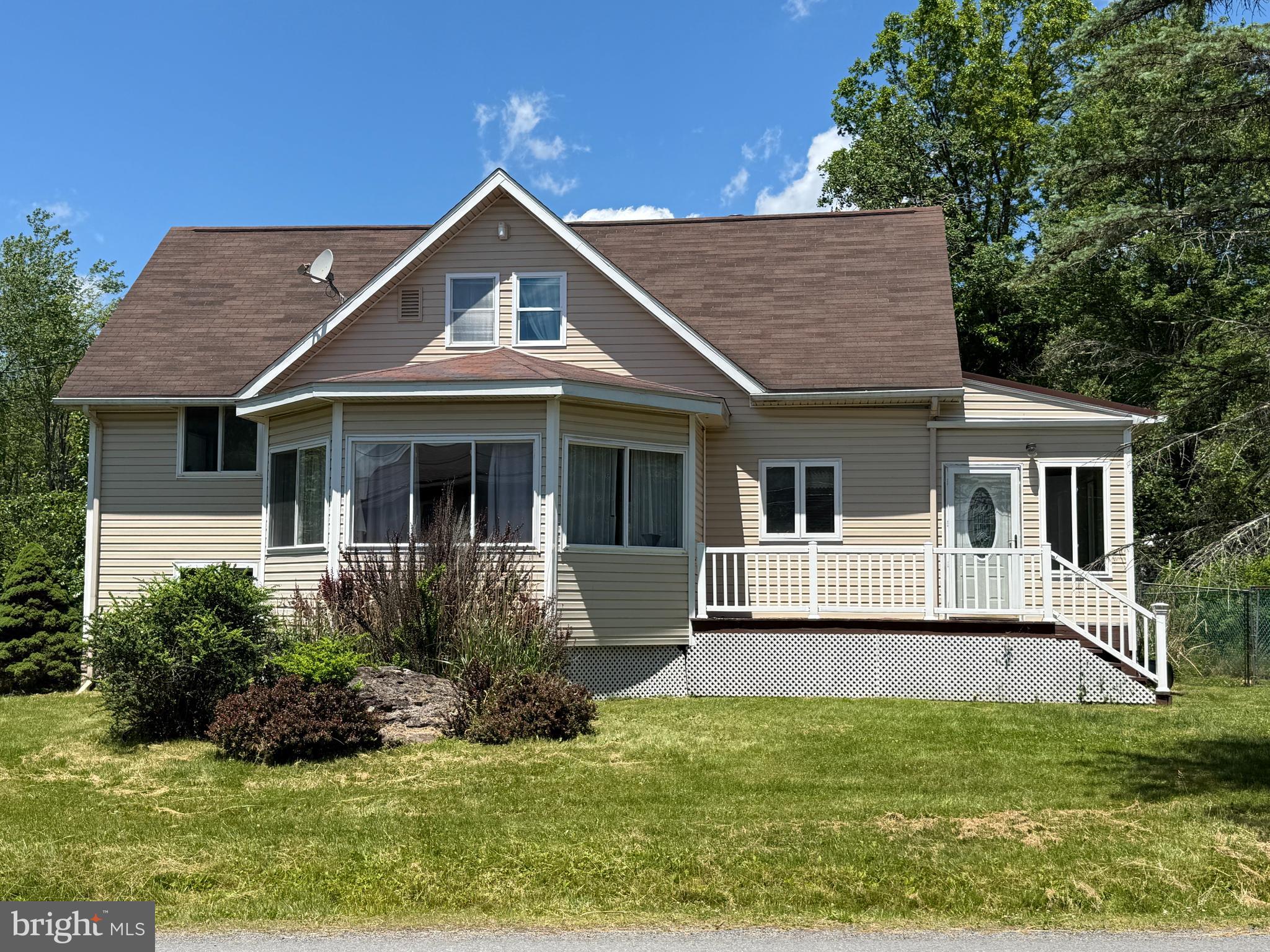 Welcome to this one-of-a-kind Cape Cod home in Arrowhead Lake, set on a flat lot with a peaceful lake view. This multi-level, two-bedroom, two-bath home is immaculately maintained, filled with natural light, and truly move-in ready. The lower level offers flexible living space with a washer, utility sink, mudroom, and room for a game or recreation area, along with the convenience of entering or exiting the home from this level. The front entrance welcomes you into a bright three-season room that leads into the main living area, where an updated kitchen features white appliances, an electric range, accented countertops, and hand-crafted inlaid tile flooring with a striking tree motif that flows from the front door into the kitchen. The kitchen opens comfortably to the living room, highlighted by hardwood floors, custom cabinetry, and a cozy wood-burning stove. A second custom inlaid tile motif extends from the wood-burning stove toward the staircase leading to the lower level, adding another layer of artistic detail. A sunroom/den with windows all around provides additional living space, while custom iron hinges, handles, and metal railings featuring artistic tree designs showcase the exceptional craftsmanship found throughout the home. One bedroom is located on the second level, with the upper-level bedroom offering knotty pine ceilings, natural tree limb posts and railings, and additional custom metal accents, creating a truly unique retreat. Complete with a deck, garage, electric baseboard heat, and lake views, this home blends comfort, creativity, and character—ideal as a full-time residence or a relaxing getaway.